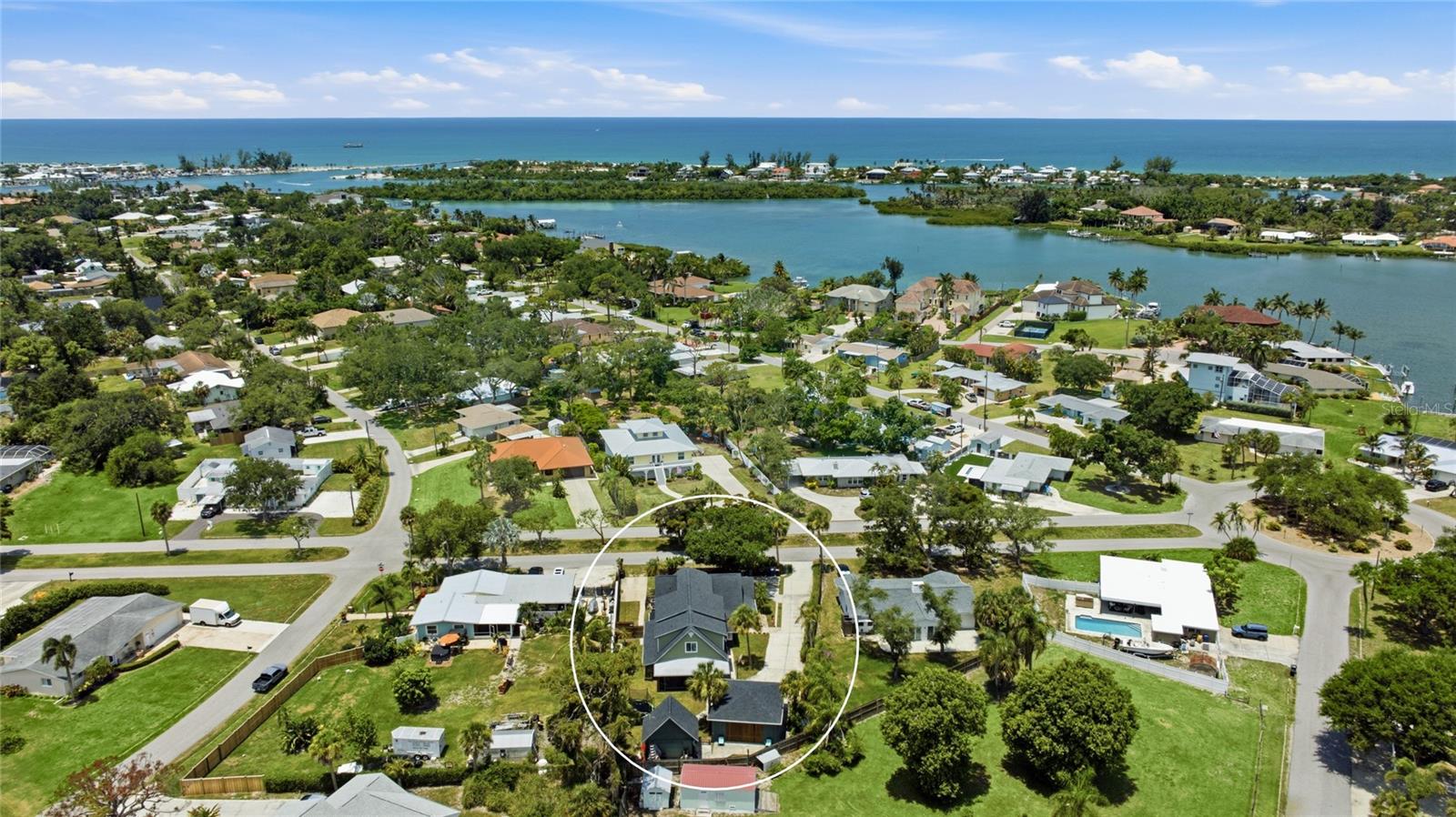 Welcome to a one of a kind coastal retreat tucked along a quiet, tree lined street in the heart of Nokomis, where the pace slows down and the Gulf sits only minutes away. Rare and versatile, this fully refinished property pairs a spacious main home with a fully separate attached suite, complete with its own address, for true multigenerational living. Wrapped in soft sage siding with crisp white trim, gambrel rooflines and dormer windows, the two story home carries all the charm of a classic Florida cottage while living far larger than first meets the eye. Inside, wood look luxury vinyl plank flows underfoot beneath recessed lighting in a bright, open concept plan. The remodeled kitchen is a true showstopper, pairing white shaker cabinetry and brushed gold hardware with dramatic Da Vinci Green quartzite counters from Brazil, a full height matching backsplash, stainless appliances and a peninsula with casual seating. It opens to a sunlit dining area framed by a sleek wood slat stair rail and a spacious living room with French doors to the screened porch, plus a cozy media room and a stylish butler's pantry with wine storage. Upstairs, four bedrooms are anchored by a serene primary suite with skylit dormer ceilings, its operable skylights fitted with electric Velux shades, and a spa inspired bath dressed in iridescent tile with a frameless glass shower and dual marble topped vanities. The oversized walk-in closet is a showpiece all its own, wrapped in custom built-ins that conceal a secret door opening to a private staircase down to its own entrance. A convenient upstairs laundry keeps daily routines close to the bedrooms, and the additional bedrooms are bright and full of character, served by beautifully updated baths with designer tile and finishes. What truly sets this property apart is the attached accessory dwelling, complete with its own separate address, private entrance and private driveway. Turnkey and full of coastal cottage charm, it offers two bedrooms and two full baths, one an ensuite, plus a renovated kitchen with white cabinetry and patterned tile, a bright living room, a secondary laundry and a private outdoor shower. Whether it hosts extended family, long term guests or rental income, it delivers genuine independence beneath the same roofline. Outside, the fully fenced grounds are a private tropical escape shaded by mature oaks and swaying palms, with room for a trampoline and basketball, a two story shed with a golf cart door, and an open air carport, all served by a long driveway. Kayaks tuck away easily, and the community offers two kayak launches to Lyons Bay just moments away. Peace of mind comes built in, with transferable warranties on the roof, the accessory dwelling foundation pillars, the windows and the siding. Close to Nokomis Beach, the Legacy Trail, waterfront dining and downtown Venice, with Sarasota and I-75 an easy drive, this is Gulf Coast living with room for everyone. Come experience all it has to offer. **THIS PROPERTY QUALIFIES FOR A 1% LENDER INCENTIVE IF USING PREFERRED LENDER. INQUIRE FOR MORE DETAILS.**