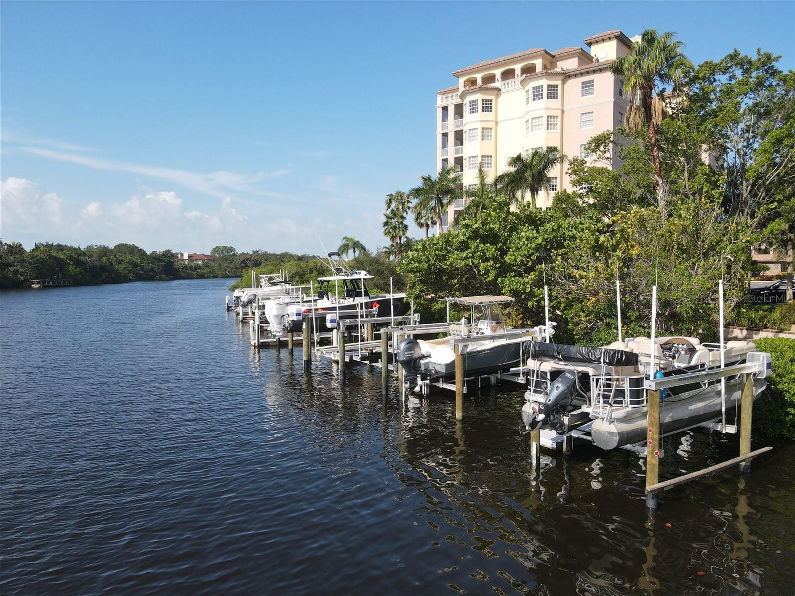 Luxury living with spectacular sunset waterfront views in the gated community of Phillippi Landings, offering boating access and a prime Sarasota location just minutes from Siesta Key Beach and downtown. This sixth-floor residence overlooks Phillippi Creek with glimpses of the Intracoastal Waterway and a peek of the Gulf from the private screened balcony. The 2-bedroom, 2-bath plus den floor plan features 10-foot ceilings, crown molding, and numerous upgrades including a newer A/C system, LG refrigerator, LG washer and dryer, KitchenAid dishwasher, Lumens ceiling fans, and upgraded lighting. The kitchen offers granite countertops, wood cabinetry, and stainless steel appliances, opening to the living area and screened balcony through 8-foot sliding doors for seamless indoor-outdoor living for relaxing or entertaining. The primary suite features wood flooring, two walk-in closets, and a spacious bath with dual vanities, garden tub, and walk-in shower. Residents enjoy resort-style amenities including a heated waterfront pool and spa, fitness center, clubhouse, kayak launch, dog park, and scenic boardwalk. High-end turnkey furnishings option available.