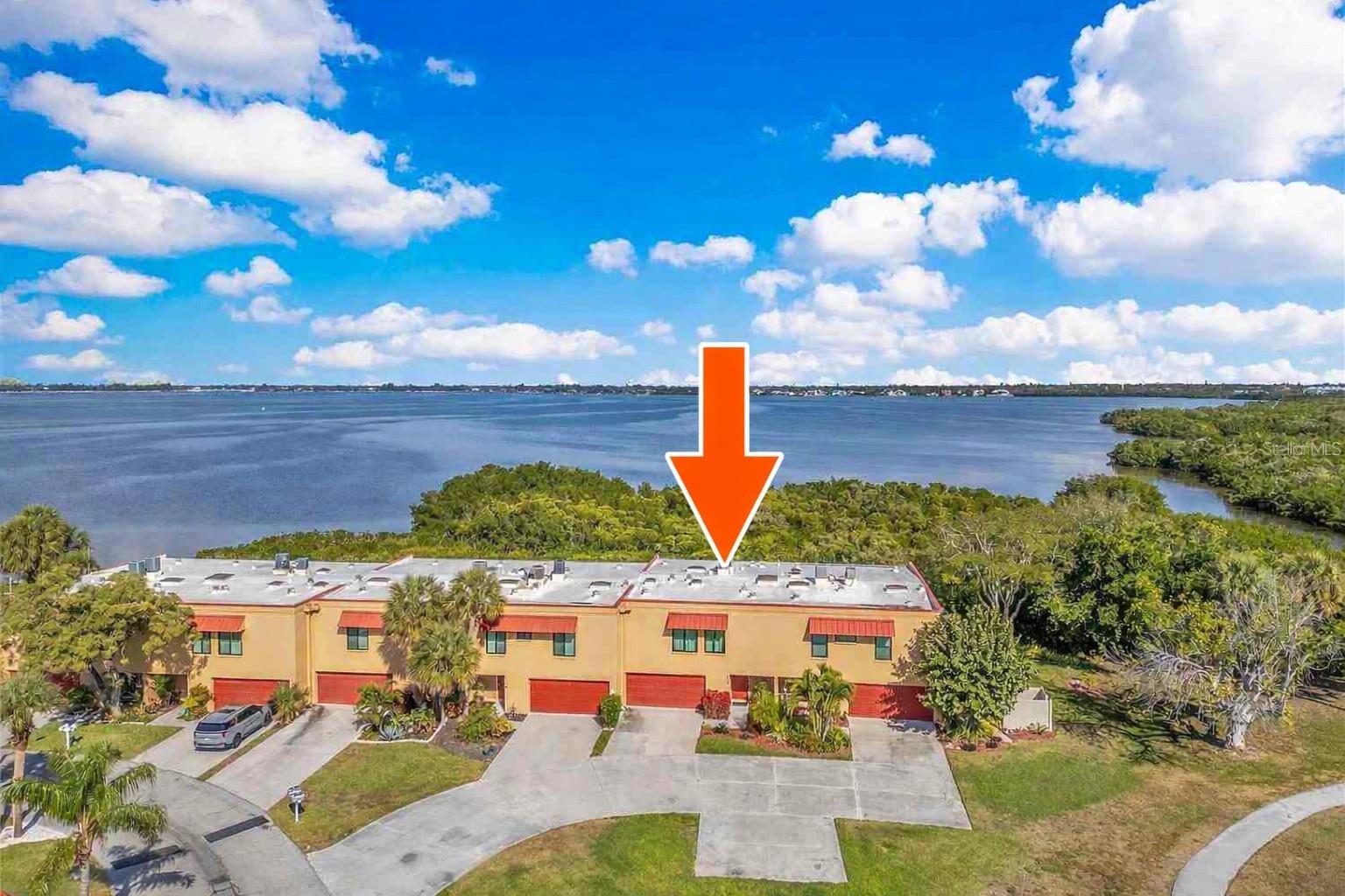 Virtually Staged. Each day begins with the soft shimmer of Palma Sola Bay, where changing light, passing clouds, and quiet movement on the water create a living canvas just beyond your windows. Located only three miles from the legendary beaches of Anna Maria Island, this immaculate, turn-key furnished waterfront residence offers a rare blend of coastal drama, privacy, and effortless luxury.

Arrival alone sets the tone. The ground level reveals an unexpectedly expansive, non-conforming great room, complete with its own dedicated HVAC system—a flexible, indulgent space ready to become a game room, media retreat, man cave, or additional living quarters. An oversized two-car garage with NEW EPOXY FLOORS and outfitted with workbench and shelving, adds both convenience and substance—rarely found, always appreciated.

Upstairs, the mood shifts from impressive to unforgettable. Sunlight filters across the water and into the living space, where ever-changing bay views anchor the room and draw you toward the outdoors. Just off the updated kitchen, the screened porch becomes your front-row seat to sunrise reflections and twilight skies—perfect for slow mornings with coffee or evenings spent lingering over a glass of your favorite vino as the day fades into calm.

The primary suite is a private sanctuary, generously proportioned and thoughtfully designed with a walk-in closet, a dedicated office nook for remote work, and a spa-like bath featuring dual vanities and an oversized walk-in shower—an indulgent space meant to be savored, not rushed.

Behind the scenes, the home delivers complete peace of mind. Both HVAC systems were replaced in 2024, and hurricane-impact windows and sliding doors throughout enhance comfort, quiet, and insurance efficiency. With over $150,000 in upgrades and renovations, every inch of this residence reflects care, investment, and pride of ownership.

For those drawn to the water, kayak access directly behind the unit offers spontaneous escapes into the serene beauty of the bay—where mornings are quiet, wildlife is abundant, and the pace of life slows naturally. The community itself elevates the experience with a clubhouse, game room, library, fitness center, and two heated pools, creating a resort-style atmosphere that feels both relaxed and refined.

All of this is paired with a remarkably inclusive $675 monthly condo fee, covering cable, internet, sewer, trash, and flood insurance—an exceptional value for waterfront living of this caliber.

This is not simply a condo.
It’s a coastal retreat, a daily escape, and a place where time stretches and life feels beautifully, intentionally lived.