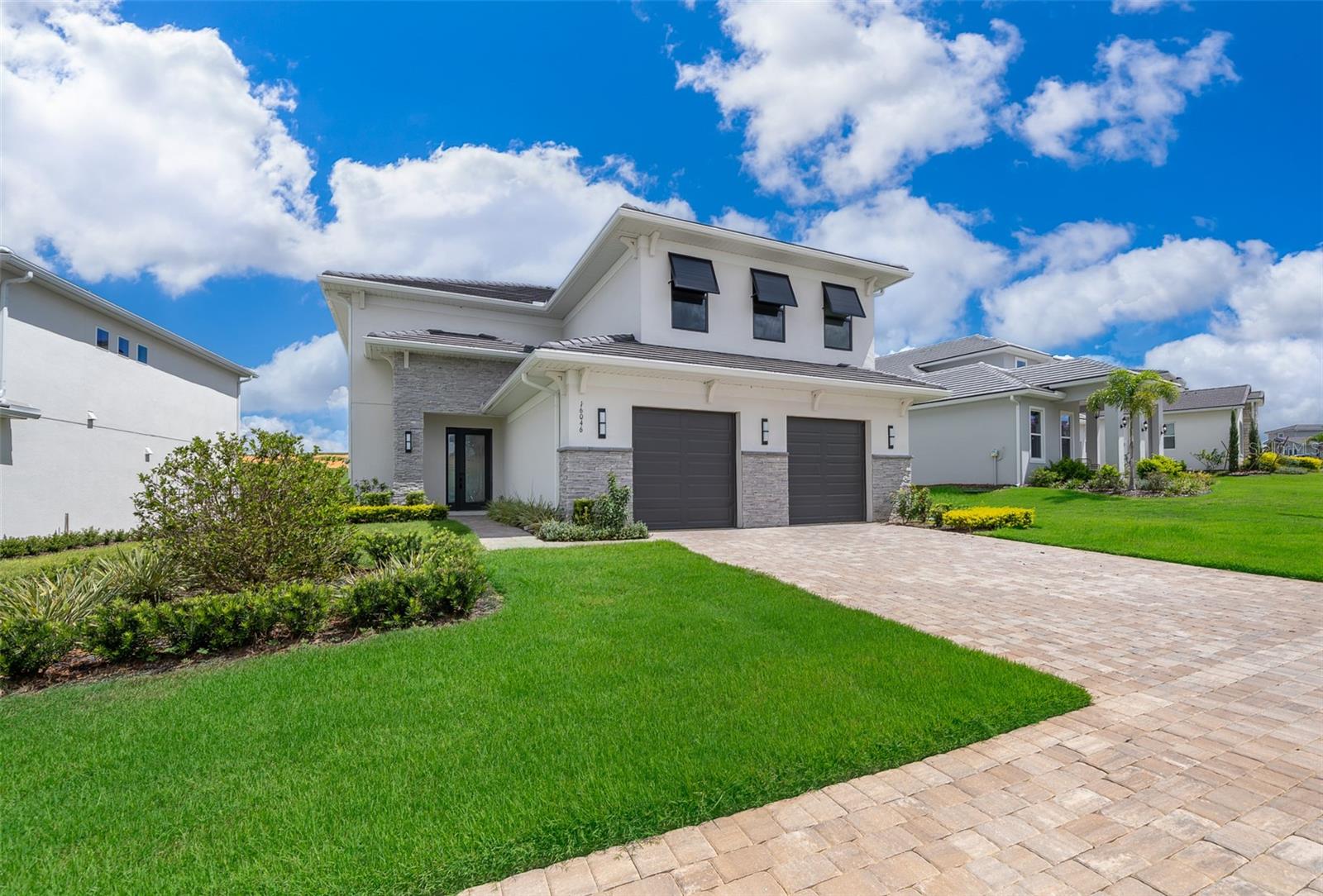An exceptional luxury residence nestled in the exclusive gated golf community of Bella Collina in Montverde, FL. This custom-built, contemporary 4-bedroom, 4.5-bath home showcases striking architectural design and modern finishes throughout.

Step inside to soaring ceilings and expansive windows that flood the open-concept living spaces with natural light. The main level boasts a sleek designer kitchen featuring shaker cabinetry, quartz countertops, stainless steel appliances, double ovens, a gas cooktop, an oversized island with seating, and a built-in wine cooler. The spacious dining area is enhanced by a dazzling crystal chandelier and opens seamlessly to the great room—perfect for entertaining or relaxing in style.

The primary suite offers serene views, plush carpeting, and a spa-like ensuite bath, complete with double vanities, a frameless glass shower, and a generous walk-in closet. Three additional bedrooms—one located on the main floor with private access and two upstairs—are thoughtfully designed with ample closet space and share beautifully appointed bathrooms.

Enjoy indoor-outdoor living with sliding glass doors leading to a covered lanai and lush backyard with sweeping views of the rolling hills and golf course beyond. Whether hosting al fresco dinners or relaxing in the fresh Florida breeze, this outdoor space is the ultimate retreat.

Additional highlights include: Motorized window treatments; Textured, modern accent walls; 2-car garage with stone accents; Elegant porcelain tile floors throughout the main living areas; Laundry room with storage and utility sink; Upgraded lighting fixtures; Situated on a premium lot with no rear neighbors.

As a resident of Bella Collina, you’ll have access to world-class amenities, including a Sir Nick Faldo–designed championship golf course, resort-style pool, full-service spa, Har-Tru tennis courts, pickleball courts, fitness center with complimentary classes, basketball courts, playground, dog park, boat ramp and fine dining—all within the security and serenity of a 24-hour guard-gated community. You'll also enjoy a vibrant year-round calendar of culinary, sports  and social events, offering an array of activities for every member of your family.