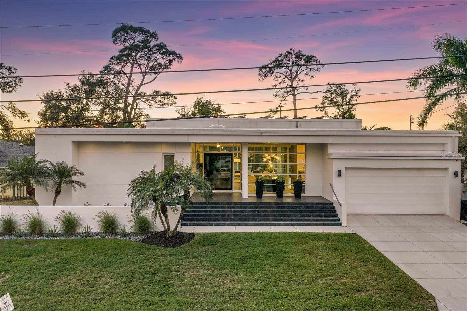 Under contract-accepting backup offers. This stunning modern residence sits at one of the highest elevations in Snell Isle / Placido Shores, offering breathtaking Vinoy golf course views overlooking Hole #7. Designed for effortless one-floor living, the home features a desirable split-bedroom floor plan, with two bedrooms sharing a Jack & Jill bathroom. The fourth bedroom is currently used as an office and includes an ensuite bath with additional hall access for guests. Soaring ceilings, skylights, recessed lighting, remote-controlled ceiling fans, and an open, airy layout creates an abundance of natural light throughout. Floor-to-ceiling panoramic impact sliding glass doors and windows seamlessly connect indoor and outdoor spaces, enhancing the home’s sleek contemporary design. The culinary kitchen is a chef’s dream, showcasing glamorous tile work, stone countertops, and a full suite of premium appliances including a 6-burner Miele cooktop, Miele refrigerator, dishwasher, and ovens, a Marvel beverage refrigerator, and a Sub-Zero wine refrigerator. A separate catering kitchen with its own dedicated entrance adds exceptional functionality, featuring an additional Miele dishwasher and refrigerator, multiple sinks, a Marvel ice maker, and a 60-bottle wine refrigerator—perfect for entertaining on any scale and plenty of cabinetry for additional storage. The private primary suite offers a spa-like retreat with a custom walk-in closet, soaking tub, oversized walk-in shower, dual sinks, and elegant finishes throughout. Additional highlights include tile flooring throughout, an electric fireplace in the family room, electric shades, zoned heating and air, central vacuum system, a 50-gallon Essency Wi-Fi compatible water heater, new front and rear gutters, a newer Halo whole-house water filtration system, and a striking double-wide glass pivot front entry door by WinDoor. Outdoor living is equally impressive, featuring a heated Gunite pool and hot tub with a newly installed pool/spa heater, , Rain Bird Wi-Fi compatible irrigation system, a large covered golf view lanai, fire pit, and a fully equipped outdoor kitchen with an Artisan built-in grill, sink, and custom HDPE marine-grade cabinetry designed for durability and water resistance. The home is hardwired with speakers inside and out and is fully compatible with a Sonos system. Additional features include energy efficient solar panels, an electric car charging station, pavered driveway and lanai, water softener, commercial-grade rear doors, and a full security system including security lighting. This is a rare opportunity to own a modern, contemporary golf-course home that perfectly blends luxury, design, and function in one of St. Petersburg’s most coveted neighborhoods—just minutes from downtown’s finest shops and restaurants.
