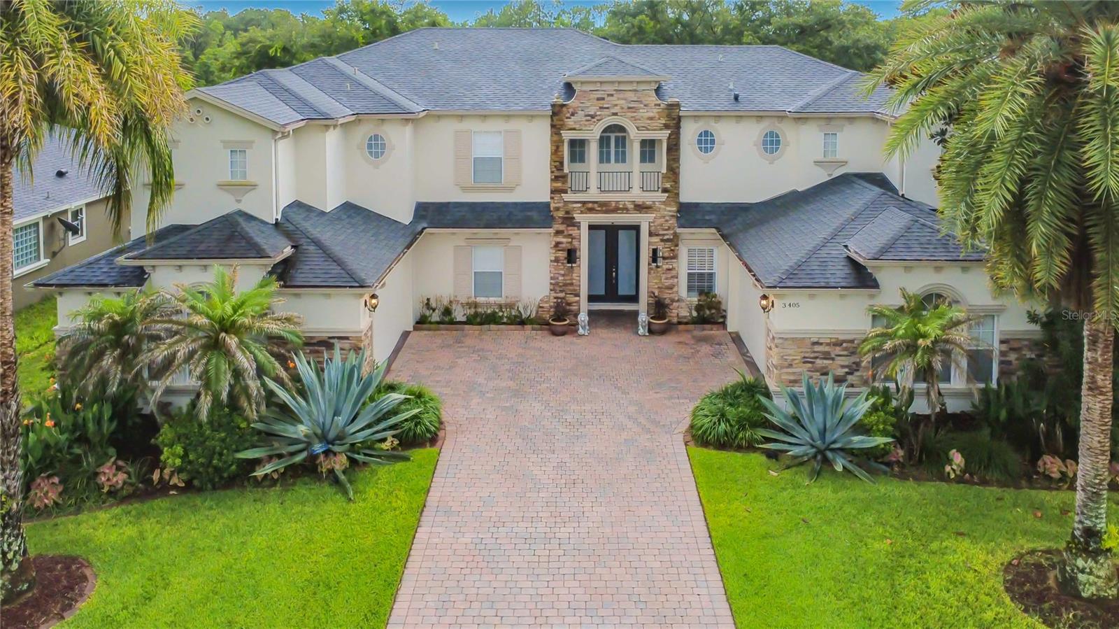 Tucked away on a beautifully positioned .26-acre homesite backing to a peaceful wooded area, this EXCEPTIONAL RESIDENCE offers the space, comfort, and lifestyle many homebuyers have been searching for.
Located in The Sanctuary, one of Oviedo's most desirable communities, this beautifully maintained 6-bedroom, 4.5-bath home boasts 4,332 square feet of thoughtfully designed living space, blending impressive ARCHITECTURAL DETAILS with everyday functionality.
From the moment you arrive, the home's striking CURB APPEAL makes a lasting impression. Double entry doors welcome you inside, where SOARING CEILINGS, abundant natural light, and expansive picture windows create a bright and inviting atmosphere. The formal living room serves as a stunning focal point, showcasing the home's dramatic two-story design.
Whether hosting special gatherings or enjoying quiet evenings at home, the SPACIOUS FLOOR PLAN offers room for everyone. The kitchen features Corian countertops, abundant cabinetry, a pantry, and a convenient walk-through BUTLER'S PANTRY leading to the ELEGANT formal dining room accented by a tray ceiling.
With six bedrooms and four-and-a-half baths, the flexible layout provides countless possibilities for today's lifestyle. Two bedrooms are located on the first floor, while four additional bedrooms are upstairs, allowing for a variety of living arrangements, home office space, guest accommodations, or hobby areas.
The SPACIOUS PRIMARY SUITE is designed as a private retreat, complete with a TRAY CEILING, comfortable sitting area, two WALK-IN CLOSETS, and a generously sized ensuite bath featuring dual vanities, a garden tub, and separate shower.
Upstairs, a spacious LOFT currently serves as a library and sitting area, offering additional space to relax, read, work, or gather.
Step outside and discover one of the home's most impressive features—an approximately 2,000-square-foot SCREENED ENCLOSURE with attractive paver flooring overlooking the WOODED BACKDROP. This expansive outdoor living space creates the perfect setting for morning coffee, weekend gatherings, outdoor dining, or simply enjoying FLORIDA'S YEAR-ROUND LIFESTYLE.
Adding to the home's appeal are TWO SEPARATE 2-CAR GARAGES positioned on either side of the driveway, providing exceptional parking, storage, and versatility.
Residents of The Sanctuary enjoy access to an IMPRESSIVE COLLECTION OF COMMUNITY AMENITIES, including a clubhouse, fitness center, resort-style pool, splash pad, playground, soccer field, tennis courts, basketball courts, volleyball courts, and numerous recreational spaces designed to enhance everyday living.
Combining GENEROUS LIVING SPACES, beautiful surroundings, sought-after community amenities, and a convenient Oviedo location, this is a property that truly offers the opportunity to enjoy the best of Central Florida living.
Schedule your private tour today and experience firsthand all that this REMARKABLE HOME has to offer.