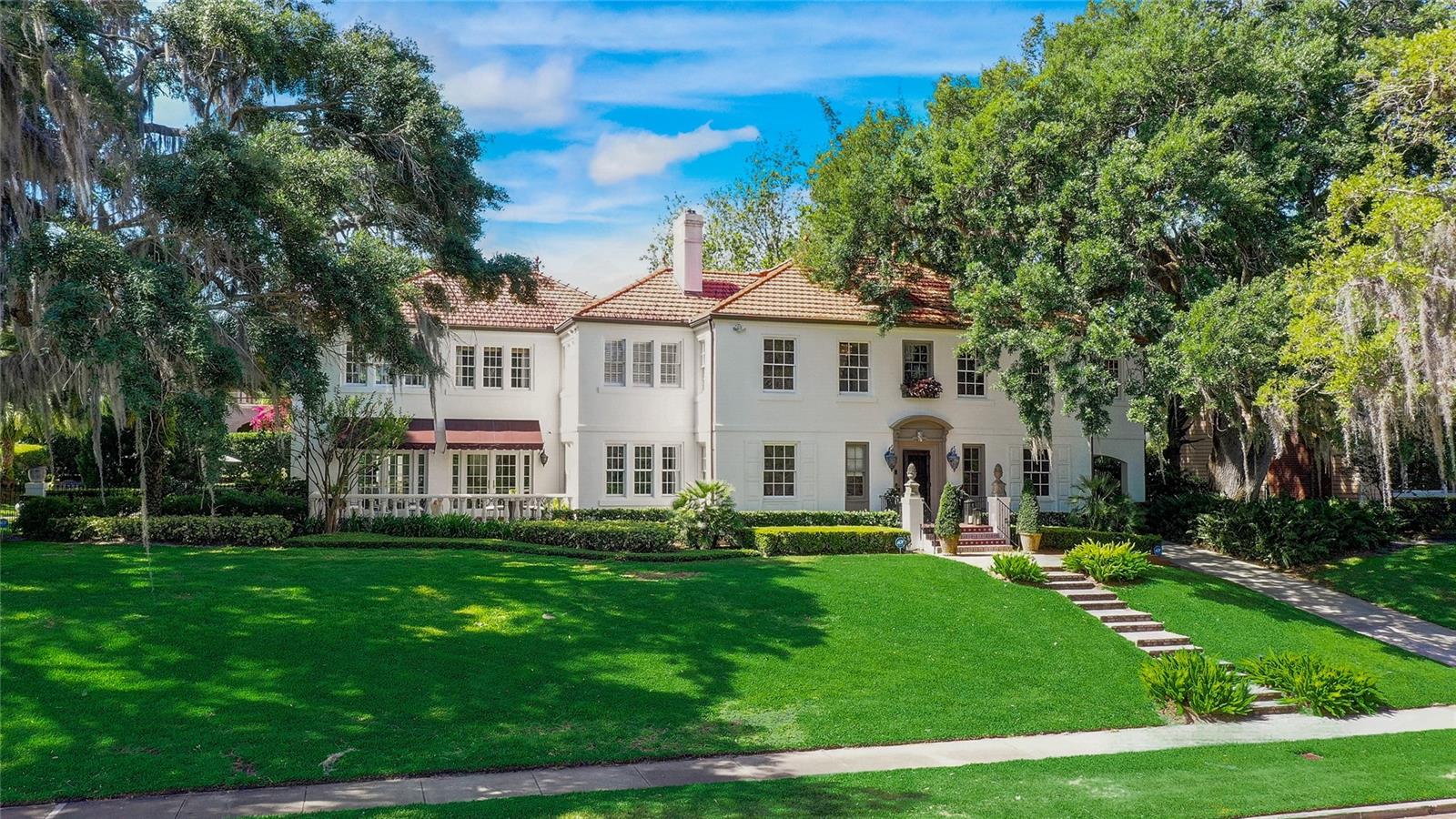 This amazing one of a kind two-story Mediterranian Estate overlooks Lake Adair located in the highly desired College Park with every conceivable upgrade. Upon entering the opulent foyer of the main house, you are greeted by a magnificent Swarovski crystal chandelier in the winding spiral staircase that drapes down to the first level. The main house boasts four bedrooms with an additional bonus room that can be used as an additional bedroom. There are four baths, two full half baths, and a spacious private guest house connected by a first floor covered breezeway. This magnificent home offers new room additions with many of the rooms overlooking the spacious saltwater pool and covered outdoor kitchen area. The open family room has one of three wood burning fireplaces with an open chef's kitchen that includes every modern convenience and an oversized stunning one of a kind quartzite countertop. The kitchen is equipped with top of the line appliances including a wi-fi controlled Thermador double door fridge and freezer, Viking grill cooktop, Jenn-air double oven, wine cooler,Bosch wi-fi coffee-latte machine, microwave oven along with a walkin pantry. These are just a few of the amenities offered in this kitchen.The completely equipped summer covered kitchen area has a large patio area ideal for entertaining quests, overlooking pool and private backyard surrounded by serene lush landscaping that offers total privacy. A separate living room with a parlor downstairs provides guests  with an additional relaxing area. Off the open great room is a covered patio with a beautiful lake view. On the second level, there are four bedrooms  and three full bathrooms. As you enter the expansive master suite, you are greeted with a large open foyer, a large open closet area, with a separate walk-in closet. The 15' x 14' master bath offers two separate sink areas, allowing an abundance of counter space, including a custom luxury massage jacuzzi bathtub for two with multiple jets, build-in TV stereo sound, private bathroom includes a bidet. Comes with a seven zone synched central sound system that can play grouped or separate room audio.