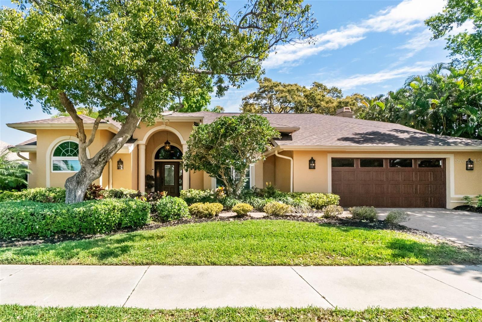 Meticulously renovated and move-in ready, this four-bedroom pool home offers stunning lake views in Palmer Ranch's prestigious Deer Creek. This gracious residence has been completely reimagined for the highest level of comfort, style, and peace of mind, boasting a 2021 roof, impact-rated doors and windows, lush tropical landscaping, and a sleek paver driveway. Upon entry, guests are immediately greeted with sweeping views of the expansive pool lanai and the tranquil lake beyond. The split floorplan is anchored by soaring ceilings and luxury vinyl plank flooring throughout. Architectural character abounds through a wood-burning fireplace, vaulted ceilings, skylights, tray ceilings, custom moldings, and plantation shutters. The 2022 chef's kitchen is a culinary masterpiece featuring custom ceiling-height cabinetry, lighted glass accent doors, and a generous island with a farmhouse sink, complemented by KitchenAid appliances (including an induction stove and double oven with convection), granite surfaces, a separate prep sink, an above-stove pot-filler, and Rohl faucets. The primary retreat serves as a private sanctuary, complete with a "speakeasy" door and sliding glass doors to the pool area.  A spa-like ensuite completes the primary suite featuring a steam shower, Victoria and Albert soaking tub, custom vanities with granite countertops and contemporary LED medicine cabinets, including a separate makeup area.  Three additional bedrooms, including one with its own ensuite, provide ample space for family and guests to relax. Outside, the expansive screened lanai and 2022 renovated pool with waterfall spa provide the ultimate backdrop for alfresco dining against a tranquil lake setting teeming with wildlife. Additional upgrades include an EV charger in the garage, a 2025 irrigation system, a custom Amish-built library wall and murphy bed, and an HVAC system with a whole house air filter and separate UV disinfection filter. Deer Creek is an upscale, guard-gated community featuring scenic lakes and a tranquil natural environment all just minutes from the Sarasota's world-class beaches, premier shopping and vibrant cultural attractions.