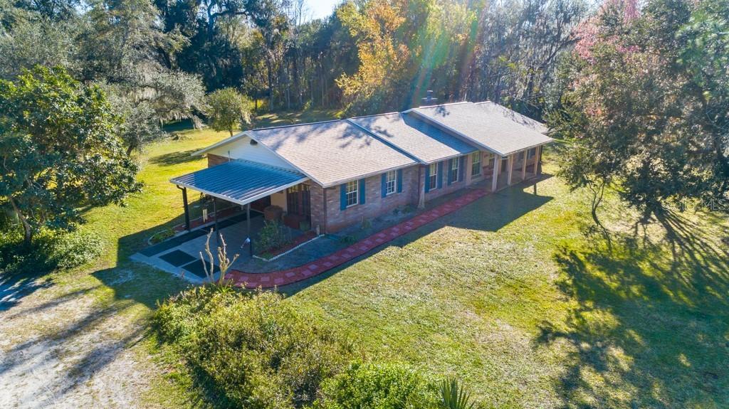 Bring your horses to this 3 bdrm, 2 bath home on 4.94 acres ideally located close to town.   Wood burning fireplace separates the living & dining rooms.  Spacious family room could be great office, 4th bdrm or converted to in-law quarters with separate entrance.  Front, rear & side covered patios.  Additional buildings include a detached 2 car carport, separate 16x40 RV pole barn, 2 stall barn & workshop.  There are 2 additional stalls & tack room that need some TLC.  Property is completely fenced with pond.   New architectural shingle roof & HVAC 2020.   This is a great country setting with lots of privacy yet just minutes to Intracoastal boat ramp, bike trail & a few more minutes to the beach.