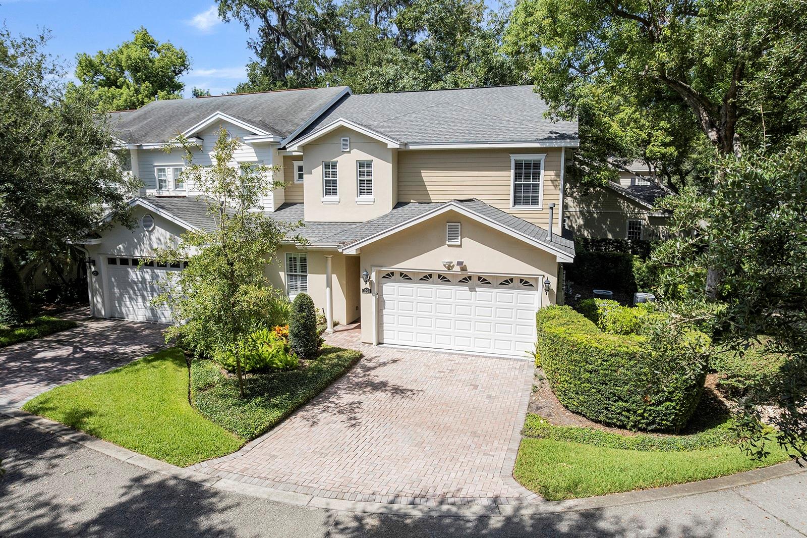 Tucked beneath a canopy of mature oak trees within the gated enclave of Country Club Oaks, this beautifully renovated fee-simple townhome offers an exceptional blend of sophisticated design, flexible living spaces and an unbeatable Orlando location. Featuring three bedrooms and three-and-a-half baths, the residence is thoughtfully designed with dual primary suites on the first and second levels, providing comfort and versatility for a variety of living arrangements. The heart of the home is a stunning, updated kitchen showcasing quartz countertops and a striking full-height quartz backsplash. Beautiful wood flooring flows throughout the main living areas, while plush high-end carpeting adds warmth to the bedrooms and upstairs gathering spaces. The first-floor primary suite serves as a private retreat, complete with a custom-designed closet system and a two-sided gas fireplace shared with the inviting living room. Upstairs, a spacious family room creates the perfect secondary living area, highlighted by a fireplace, an updated wet bar and two sets of French doors that open to a screened porch overlooking the golf course and surrounding treetops. The second primary suite features a beautifully renovated bath and custom closet, while the third bedroom, used as a home office, offers exceptional built-in cabinetry and a stylish en-suite bath. Designed for everyday living and effortless entertaining, the home offers multiple outdoor living spaces, including a screened patio on the first floor and the elevated screened porch above. An interior elevator provides convenient access between levels, while additional amenities include a spacious laundry room, an attached two-car garage, a brick paver driveway and a new roof installed in 2022. Residents enjoy low HOA dues and a prime location adjacent to the Country Club of Orlando, with easy access to the vibrant Packing District, the boutiques and restaurants of Edgewater Drive, downtown Orlando and major area destinations. Move-in ready and meticulously updated, this exceptional residence offers a rare opportunity to enjoy maintenance-free living in one of Orlando's desirable gated communities.