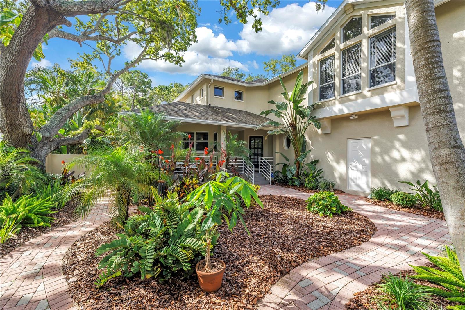 A rare offering in the coveted Carlton Estates, this extraordinary Mediterranean-inspired estate redefines luxury Florida living. Perfectly positioned on a sprawling private homesite outside the flood zone, this remarkable residence combines timeless architecture, exceptional craftsmanship, and resort-style amenities in a setting that feels worlds away, yet remains moments from the area's finest coastal attractions.
From the moment you arrive, the home's presence is undeniable. A circular drive, lush tropical landscaping, and a picturesque paved courtyard entrance create a grand welcome worthy of a luxury retreat. Inside, soaring 18-foot ceilings and sun-drenched living spaces showcase a seamless blend of sophistication and comfort, with every detail thoughtfully curated to elevate daily living.
Offering 3,462 heated square feet, four spacious bedrooms, two-and-a-half baths, and a generous two-car garage, the home has been extensively updated throughout. Rich hardwood flooring graces the upper level, while elegant plank tile flooring, crown molding, and professionally refreshed interiors and exteriors provide a refined, move-in-ready experience.
At the heart of the home, the stunning chef's kitchen was designed to gather family and friends. Solid wood cabinetry, granite countertops, premium appliances, and a custom built-in breakfast booth create a space as beautiful as it is functional. The expansive great room flows effortlessly to the outdoor living areas, blurring the line between indoor elegance and outdoor paradise.
The primary suite is a private sanctuary unlike any other, offering dual walk-in closets and a spa-inspired bath overlooking a serene waterfall courtyard, creating a daily escape that rivals a luxury resort. Upstairs, three additional bedrooms feature distinctive architectural details, including charming eyebrow windows that bathe the spaces in natural light.
Beyond the walls of the home lies a backyard retreat rarely found in Pinellas County. Set on an impressive 230-foot-deep lot, the property is enveloped by mature tropical canopy landscaping that creates a level of privacy few homes can match. The resort-style PebbleTec pool has been beautifully updated with new tile and is complemented by a newer heater and pump, a freshly rescreened enclosure, and PVC fencing, offering the perfect backdrop for entertaining, relaxation, and unforgettable Florida sunsets.
Homes of this caliber, on lots of this size and privacy, are exceptionally rare. Combining enduring Mediterranean elegance, extensive modern upgrades, and an unparalleled location near the Gulf's pristine beaches, private clubs, fine dining, boutique shopping, and premier coastal amenities, this is more than a home—it is a lifestyle reserved for the fortunate few.