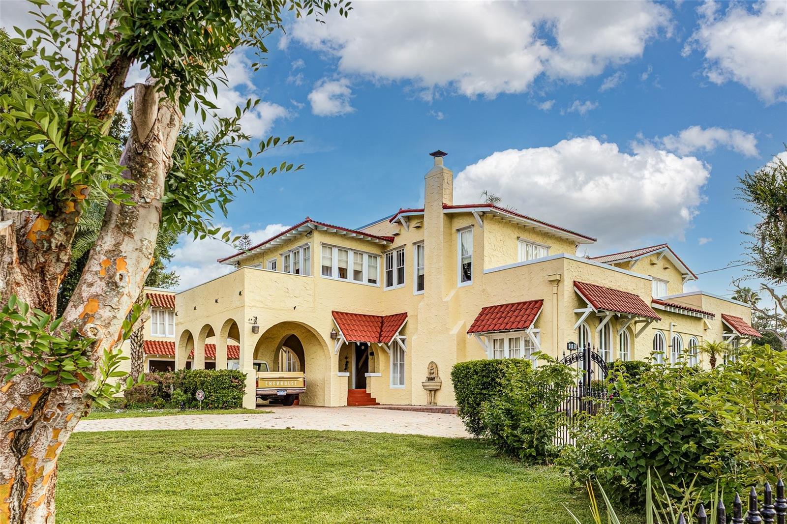 Introducing 845 E. Edgewood Drive — a piece of Lakeland’s past that has outlasted trends, outlasted time, and still stands as one of the city’s most prominent estates. Built in 1922 and set on half an acre, this Spanish Revival residence makes an unforgettable impression from the moment you step inside. At the heart of the home, a curved grand staircase sweeps through the entry with hand-forged wrought iron scrollwork, a soaring column, and dramatic architectural detailing that creates a truly remarkable centerpiece. Just beyond it, a glass-roofed indoor courtyard frames a tiered stone fountain surrounded by tropical greenery, with French doors opening into the main living spaces on all sides. It is not just a room — it is an experience. Throughout the home, artisan frescoed ceilings in rich terracotta, warm amber, and deep azure bring character and artistry to every space. Beneath them, the main residence offers 4 bedrooms, 3.5 bathrooms, a gourmet kitchen with professional-grade appliances, warm parquet wood floors, dramatic arched doorways, and French doors throughout. Beyond the main house, the property features a detached ADU complete with 1-bedroom, 1-bathroom, and full kitchen, offering exceptional flexibility for guests, extended living, a private retreat, studio, or workspace. The estate also includes a two-car garage, private pool, and mature landscaping designed for privacy, entertaining, and retreat. Located minutes from Downtown Lakeland, Lake Hollingsworth, Cleveland Heights Golf Course, Lakeland Country Club, local tennis courts, dog parks, dining, shopping, and some of the city’s most beloved destinations.
Rarely does a property offer this level of history, architectural detail, privacy, and presence in one of Lakeland’s most recognizable locations. 845 E. Edgewood Drive is a true one-of-a-kind estate with a story all its own. Come see it for yourself!