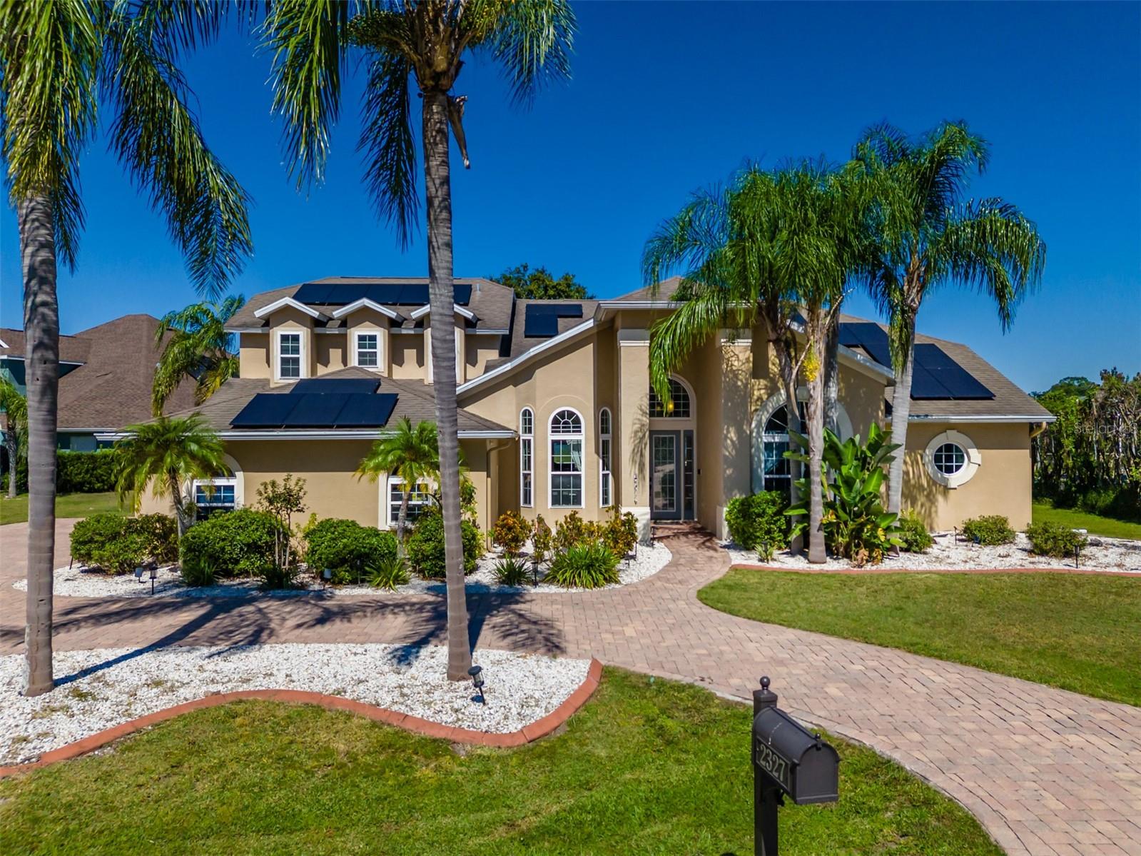 Experience refined lakefront living in this stunning custom-built 5 bedroom, 4 bath + office/study pool home nestled on 2.97 acres in Nature’s Reserve — an exclusive gated enclave of just 16 luxury estates in highly sought-after Land O’ Lakes. With a private dock, community boat ramp, and breathtaking water views throughout, this home offers the ultimate blend of privacy, elegance, and resort-style living.
From the moment you arrive, the impressive paver circular drive sets the tone for the grandeur within. Step inside and be captivated by the bright, open floor plan where panoramic windows and sliders frame an uninterrupted view of the sparkling pool & Spa, lush backyard, and serene lakefront.
To the left the formal dining room has bay windows and walks into the gourmet kitchen that is perfect for entertaining and features 42 inch wood cabinets, granite countertops, custom back splash, under cabinet lighting, breakfast bar, stainless steel appliances, and a large eating area with views out of the bay windows to enjoy that lakefront water view.
The kitchen overlooks the large living room that has built-ins and an electric fireplace for that cozy ambiance.
The large primary suite features wood flooring and has large windows with lakefront water views and has French doors out to the pool/patio area. The primary bathroom includes double vanities with granite counters, walk in shower with tile work to ceiling, and his and her closets.
The first floor 2nd bedroom/Guest Suite includes private full bath and private double door entry to pool area. The additional 1st floor bedrooms are also very spacious with a shared bath!
This home features a 2nd floor that shows a very large 5th bedroom(on floorplan) and full bath with 2 closets, but is versatile to be used as a bonus room, office, guest suite and more. Endless Possibilities! 
Step outside and unwind in your heated saltwater pool & spa with waterfall, all within a screened, oversized lanai with pavers perfect for year-round entertaining. Enjoy sunsets over the lake, launch a boat from your private dock, or use the community ramp for endless days on the water.
Though tucked away for maximum tranquility, this estate is in a prime location and is conveniently minutes from premier shopping, dining, The Groves, Tampa Premium Outlets, Wiregrass Mall, and major highways for easy access to Downtown Tampa and Tampa International Airport.
If you’re seeking a luxury lakefront lifestyle with space, privacy, and endless entertainment potential — this is the dream home you’ve been waiting for. This home even has recent over $40K in Solar that is fully transferrable with a 30 year warranty and fully Paid Off!!
Schedule your private tour today — opportunities like this are rare and won’t last! Make sure to click the link for the Video and Landing Page!