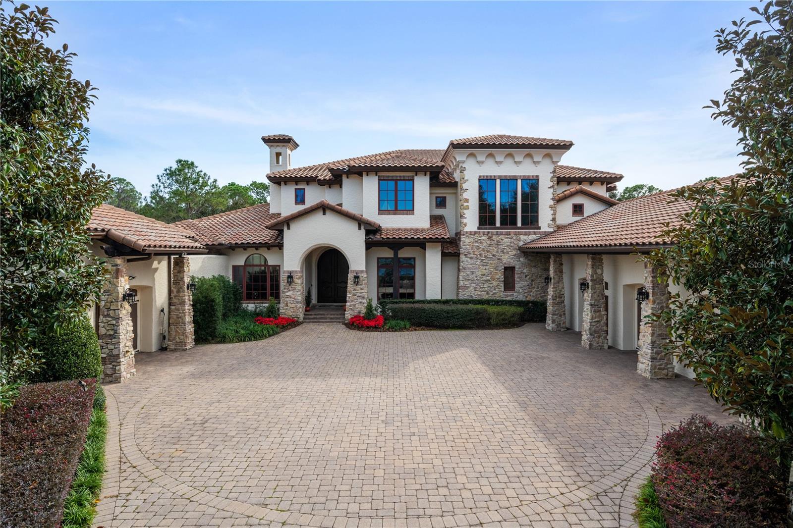 BEST BUY ON THE BUTLER CHAIN OF LAKES!! Rarely do you find VALUE and LUXURY in one place! At $479 a sq ft, this extraordinary J.RICHARD WATSON custom-built LAKEFRONT estate provides both VALUE and LUXURY + PLUS fantastic location within the guard gated golf course community of Keene's Pointe in Windermere, Florida. The Estate sparkles with fresh interior and exterior paint and all new LED lights throughout the home which accent the custom woodworking, cast stone trim, warm chisel edged travertine and hard wood floors throughout. Impeccably maintained by original owners, the estate features 6 Oversized ENSUITE Bedrooms, first floor home theatre, game room and study, plus TWO upstairs bonus rooms. As you step through the solid mahogany double entry doors, your eyes are drawn to the huge picture window with views of the large open pool, big backyard and lakefront beyond. The main floor hosts the primary retreat, a guest bedroom suite, an oversized living room, classic study with wood inlaid ceiling, dining room with hospitality bar, a custom built wine cellar, and vast kitchen-family room combination. The main floor seamlessly flows into an expansive game room and home theater, with panoramic views of this sprawling 2-acre property located on Lake Tibet Butler, the second largest of the highly sought after Butler Chain of Lakes. To the front of the home you can enjoy complete privacy as you gaze upon a beautiful pond with lighted fountain which adds the perfect ambiance to this serene location. Ascending the wide wooden staircase to the second floor, the soaring wood-inlaid ceilings, reaching heights of 30+ feet, captivate the senses. The upstairs gathering room which opens to a balcony serves as the focal point of the second floor, surrounded by FOUR huge ENSUITE bedrooms, each offering privacy and luxury. A mid-level bonus room provides versatile space for various purposes, adding another layer of flexibility to this exceptional residence! The exterior, bathed in the radiant glow of sunshine, mirrors the warmth within, with an impressively large outdoor living space that can be screen enclosed at the touch of a button. A deluxe summer kitchen and entertainment area, complete with a fireplace and walk-up bar, make this outdoor haven perfect for socializing. The south-facing open pool brings an abundance of light into the home throughout the day! A fully fenced yard, and boardwalk invites a scenic nature stroll down to the dock and covered boathouse on Lake Tibet Butler. Other unique amenities of this home include a full 3-car garage PLUS a detached single car garage currently modified as a personal gym with space sectioned off for golf cart parking. It also has an electric car charging station conveniently built in. This single garage is connected to the primary retreat through a private open courtyard with hot tub, fireplace and sauna for the owner’s exclusive use. With endless possibilities and a design that invites many interpretations, this amazing floor plan must be seen in person to be fully appreciated. Come, tour, and let your dreams find your forever home in this impressive Tuscan-inspired Estate built by Master Custom Builder, J. Richard Watson, one of top premier builders in the area, renown for his exceptional quality construction and design.