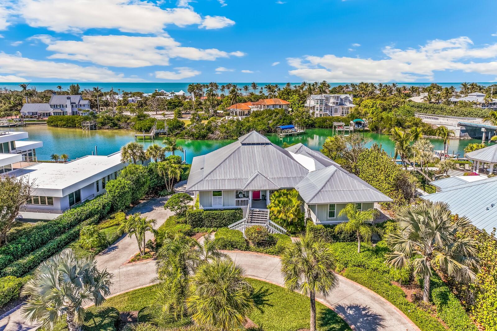 Located in the gated community of Boca Grande Isles, this well-maintained, 3 bedroom, 3 bathroom, waterfront home is a boater’s dream with direct access to Charlotte Harbor and no bridges to the Gulf of Mexico. The 2,715 sq. ft. residence features an open floor plan with vaulted open-beam ceilings, hardwood floors, custom built-ins, plantation shutters, and impact sliding glass doors framing serene canal views and leading to a screened lanai. The remodeled kitchen is appointed with quartz counters, Sub-Zero refrigerator, Wolf gas range, ample workspace, and a dumbwaiter. The living and dining areas flow effortlessly to a 48’ x 10’ screened outdoor space overlooking the water. The spacious primary suite offers canal views, patio access, a generous walk-in closet with washer/dryer, and a renovated bath with quartz counters, dual sinks, soaking tub, and separate rain shower. Outdoors, enjoy a composite dock with a 16,000-lb boat lift, 110’ seawall, two-car garage, golf cart garage, paved circular driveway, and plenty of backyard space with room to add a pool. An air-conditioned storage/workout room offers added versatility. This exceptional canal-front property delivers premier island living and easy Gulf cruising from your own dock.