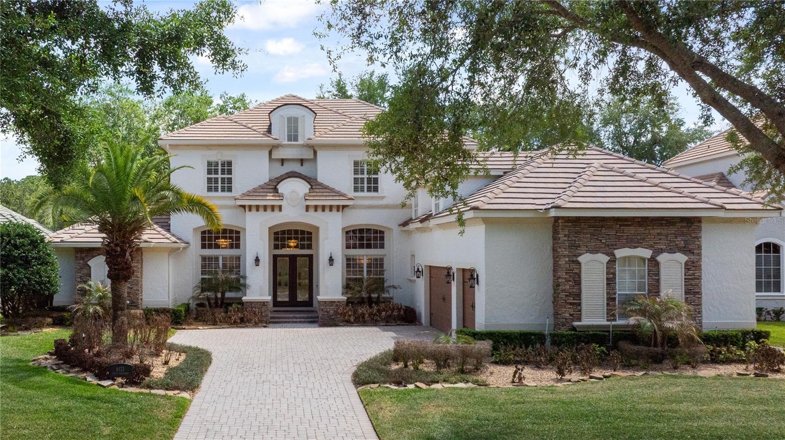 Sophisticated Elegance best describes this stunning remodeled 5 Bedroom/5FULL Bath/2 Half bath Golf Course Estate Home in Keene’s Pointe.  Upon entering this residence built by master custom builder J. Richard Watson, you will discover the seamless beauty of the 48 x 24 tiles that grace the entire main floor and set the tone for this gorgeous interior space filled with abundant natural light.    Your eyes are drawn to the impressive living and dining rooms that meld together in this open concept while already eyeing the dramatic Family Room view through a graceful arched cast stone passage into the “heart of the home”.   The remodeled kitchen and family room display an elevated level of design rarely seen today, equipped with new cabinetry and accent lighting accentuating the Cambrian custom countertops and back splash areas and new appliances by Wolf, Sub-Zero and Cove.        The adjacent Family Room has a clever hospitality bar hidden behind tall double doors so discreet and refined that you are delightfully surprised when you open them to see the mirrored walls and lighted cabinets storing sparkling glasses and a wine refrigerator!    Attractive fireplace framed out in a custom Cambria surround is flanked by matching accent walls to feature your most cherished collectibles.   From the foyer to the kitchen, you note several coordinated glass and gold chandeliers that highlight the ivory walls, fresh interior paint and new can lighting and ceiling fans throughout.   You will also find a large study, the primary retreat and a guest-ensuite bedroom on the main floor.    Just off the kitchen, a lovely staircase beckons you up to a mid-level reimagined home theatre with the latest in sight, sound and special effects.   New plush red leather recliners are enhanced with vibrations that mimic the main event on the screen to make you feel like you are in it – not just watching!   Other rewards include the private half bath, beverage bar, professional popcorn machine and extra seating to enjoy the ambiance without leaving the room!    Continuing up the staircase you will discover the second floor featuring 3 bedrooms, 2 Full Baths: (1 ensuite and 2 bedrooms sharing an oversized bathroom with dual vanities, and soaring ceiling with skylight!)  Both the enormous bonus room and the ensuite bedroom open to a screened balcony overlooking the pool, golf course and the nature preserve in the distance.  Second floor is all engineered hardwood throughout and all bathrooms are renovated.   The spacious outdoor screened living area is impressive as well, with a large pool with pebble tec finish tucked within so easy to maintain its pristine sparkle keeping nearby oak tree leaves out of bounds!  Enjoy the built-in fire pit and conversation area, along with a separate wet bar under the covered lanai.  There is an additional summer kitchen featuring a natural gas grill and built in “Green Egg” allowing you to manage most any cookout gathering!   Finally, light up any event you host any day of the year with the custom Massey Outdoor Landscape Lighting color carousel that allows you to choose your color for any seasonal holiday simply by pressing your app!    So, sit back and enjoy the view of the wide eighth fairway of the renown Jack Nicklaus Signature Golf Course in Keene’s Pointe.   Come live the lifestyle for which Keene’s Pointe is famous and add just an extra splash of refined elegance to the mix!
