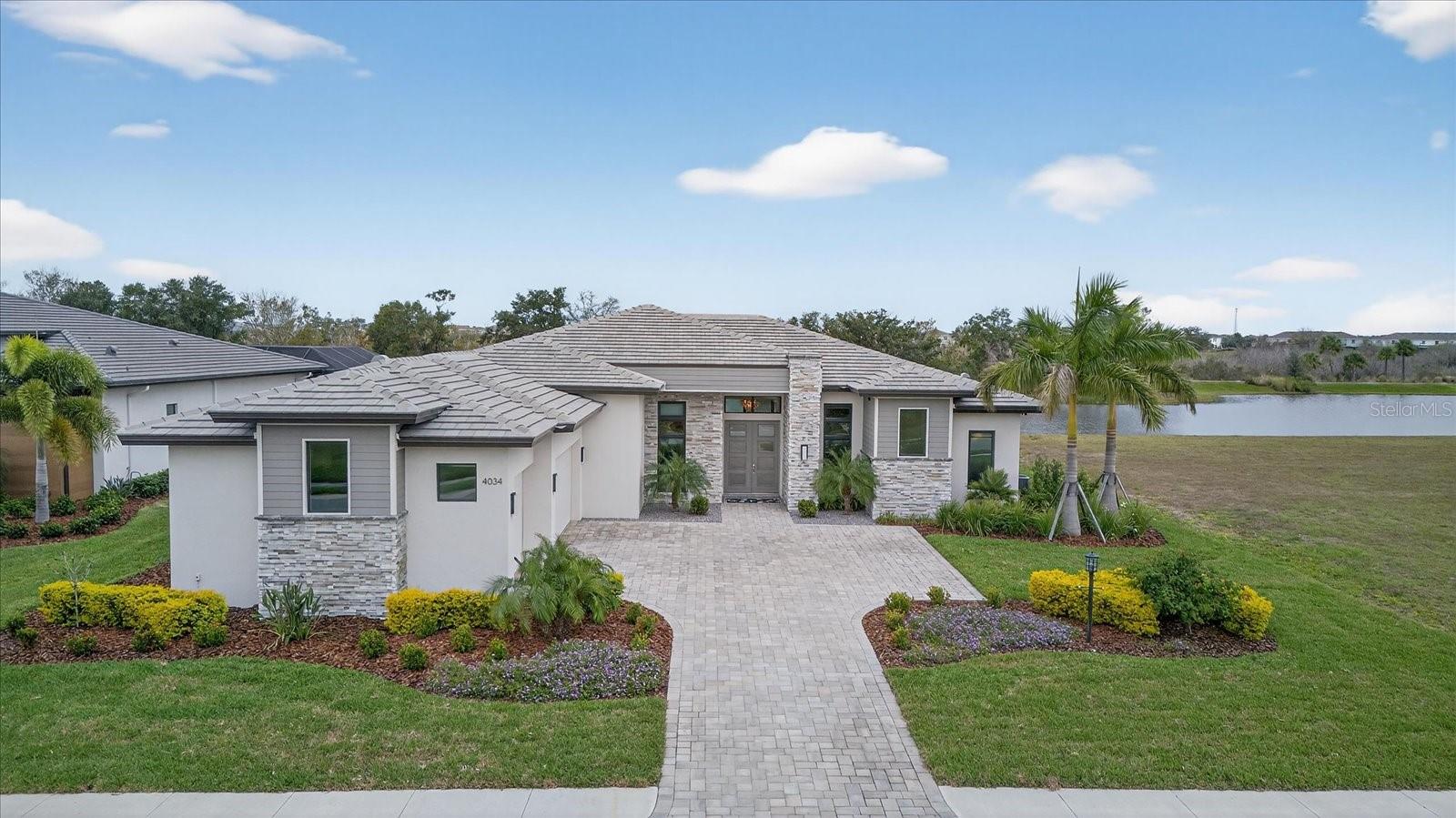 ***SELLER MOTIVATED*** Considering building a custom home or working with a luxury production builder but hoping to avoid the wait, delays, and punch lists? This 2024 Lee Wetherington custom single-story residence, offers the best of both worlds. Ideally positioned on a premium lot in Star Farms at Lakewood Ranch, the home is designed to enjoy sweeping western lake views and serene preserve surroundings.

Offering over 3,100 square feet of thoughtfully designed interior living space and an impressive 2,100 square feet of outdoor living, this home embodies refined Florida living. The layout includes four spacious bedrooms, four beautifully appointed bathrooms, a den/office, an oversized and versatile bonus room, and a generously sized great room ideal for both everyday living and entertaining.

At the heart of the home is an open great room floor plan centered around 24 feet of oversized, center-opening glass stacking sliders that flood the space with natural light and frame tranquil lake views. The living and dining areas are enhanced by 12-foot double tray ceilings with LED uplighting, creating a warm and elegant atmosphere. The chef’s kitchen features a Sub-Zero refrigerator, high-end stainless steel appliances, wine refrigerator, sleek quartz countertops with seating for four, custom wood cabinetry with accent LED lighting, and an expansive walk-in custom pantry.

Continuing the home’s seamless indoor-outdoor flow, the bonus room is equipped with 18 feet of unobstructed, disappearing corner glass sliders that open directly to the lanai. With over 42 feet of access to the outdoor space, guests can easily step outside to enjoy Florida’s year-round sunshine. Entertainment is elevated with a multi-zone Sonos sound system and a resort-style pool featuring three decorative fountains.

The owner’s suite is a private retreat, offering dual custom walk-in closets, a soaking tub, oversized walk-in shower, dual vanities, tray ceiling with LED lighting, a statement chandelier, remote blackout shades, and glass French doors providing private lanai access. Two out of the three guest bedrooms feature en-suite bathrooms, each offering spacious closets, chandeliers, vanity lighted mirrors, and blackout shades, providing comfort and privacy for family and visitors. 

The exceptional outdoor living area features an alfresco kitchen, refrigerator, natural gas fire table, a 10,000-gallon heated saltwater custom pool and spa, panoramic screened enclosure, and stunning leathered marble pavers set in a tight French pattern. Completing the home is an oversized three-car garage, fully insulated and climate controlled, offering ample storage, an epoxy floor, and two EV charging receptacles.

This energy-efficient smart home includes a tankless recirculating hot water heater, integrated camera system, smart deadbolt keyless entry, remote pool controls, smart HVAC systems, hard-wired Wi-Fi boosters, and a Ring video doorbell. Impact windows and doors throughout, along with remote hurricane screens, provide added protection, privacy, and shade. Additional features include custom built-in cabinetry and shelving, a functional drop zone, decorative cultured stone exterior accents, and natural gas throughout.

Residents of Star Farms enjoy access to on-site restaurants, a resort-style pool, pickleball and tennis courts, fitness facilities, and more. Skip the build time and start enjoying breathtaking sunset views today. This home is truly move-in ready!