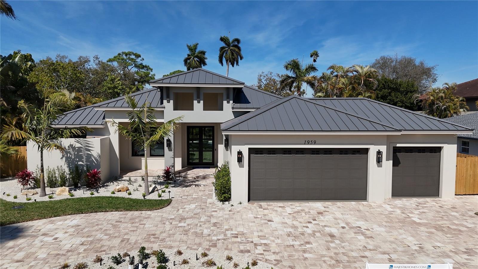 Welcome to 1959 Wisteria Street – a beautiful New Construction Single Story home, West of the Trail, that your clients will love!
This just-completed modern coastal single story home is located West of the Trail in preferred Flood Zone X, offering elevated storm protection and convenient access to Southside Village, Downtown Sarasota and Siesta Key beaches.
Designed and built with Majestik Homes' signature strength and style, this 3 bedroom plus office, 4 bath home blends architectural elegance with energy efficiency and storm-ready construction.
You will be awestruck as you open the home’s large glass-paneled double doors and step into a spacious foyer that flows seamlessly into an expansive great room filled with natural light and a striking entertainment wall — perfect for relaxed living and stylish entertaining. Panoramic sliding glass doors open to a private backyard oasis featuring a sparkling pool and spa, and a fully appointed outdoor BBQ area designed for effortless Florida entertaining.
The chef’s kitchen features high-end gas appliances, and the dining room is ideal for intimate dinners and larger gatherings alike. The Primary Suite is spacious and luxurious with its own private lanai. The spa-inspired primary bath offers both an indoor shower and a private outdoor shower for a true resort-style experience. Bedroom 3 includes an en-suite bath.
Situated on a generous homesite with large side yards and enhanced privacy, the property is complemented by a circular driveway and an oversized 3-car garage — providing ample space for guests, storage, and everyday functionality.
Beautifully staged and thoughtfully designed, this home showcases artwork from some of the local area’s most inspiring artists.
Easy to show — you won’t want to miss this exceptional opportunity.