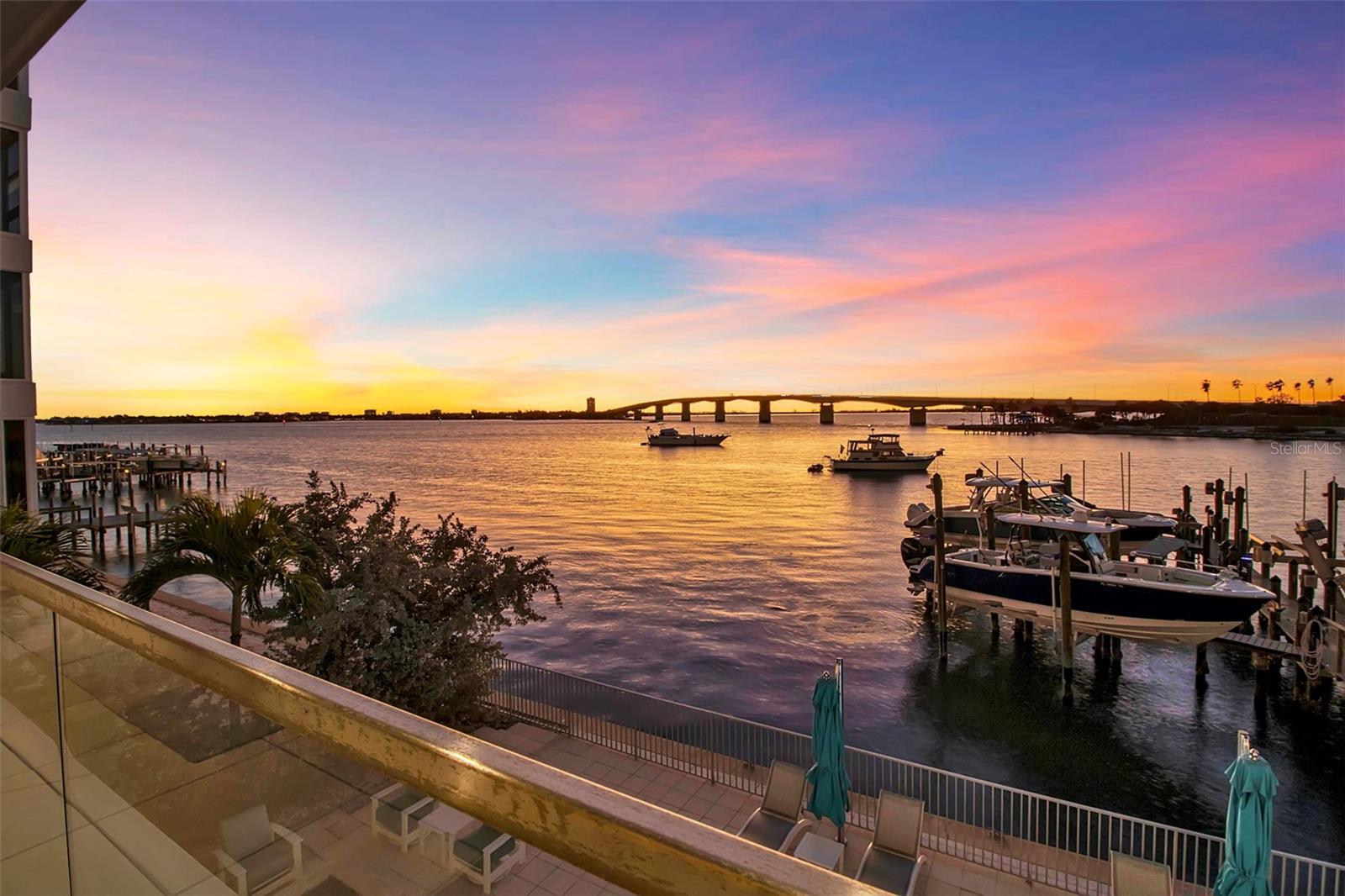 Modern waterfront sophistication takes center stage in this exceptional residence at One88 on Golden Gate Point, a boutique architectural landmark offering just eight private condominiums on Sarasota Bay. Widely regarded as one of Sarasota’s most exclusive addresses, One88 delivers a rare combination of privacy, design distinction, and unobstructed bayfront living. Upon entering the residence, a refined yet highly functional interior unfolds, thoughtfully curated with premier materials and bespoke craftsmanship throughout. Distinguishing features include DuChâteau engineered wood flooring, custom Italian cabinetry by Cucine Ricci, and striking architectural concrete elements by Ben Nettles—featured in the fireplaces, kitchen breakfast bar, and powder bath sink. Additional enhancements include recessed baseboards, two alcohol-burning fireplaces, and a temperature-controlled, 500-bottle wine cellar designed for the serious collector. A full smart-home ecosystem by Wicked Smart Homes seamlessly integrates motorized window treatments, lighting, and surround sound, elevating both convenience and lifestyle. The open-concept kitchen is anchored by a premium Thermador appliance suite, including a dedicated 75+ bottle wine column, complemented by designer Italian cabinetry, a statement tile backsplash, expansive island seating, and a custom-organized walk-in pantry. Positioned to capture sweeping bay views, the kitchen flows effortlessly into the great room, framed by floor-to-ceiling glass doors that open to a 575-square-foot westerly waterfront terrace—creating an exceptional indoor-outdoor living experience unique to this residence with a built-in gas grilling area. As well as 254 sq ft of private Eastern- facing terrace space off the owner’s suite. Secured elevator access into the unit’s foyer, with an additional locking glass door for extra security. The great room offers generous flexibility for furnishing and entertaining, enhanced by a built-in wet bar with dual beverage drawers. The owner’s suite serves as a tranquil retreat, featuring a private morning terrace and a custom spa-style bath unlike any other in the building. Two additional en-suite guest bedrooms, a well-appointed powder room, a spacious laundry room, and multiple storage closets complete the interior layout. This offering includes a private boat dock equipped with a rare 25,000-pound lift, along with two side-by-side parking spaces—one with an additional car lift—plus a utility lift and substantial private storage. Residents of One88 enjoy exclusive amenities including a rooftop terrace, waterfront fire pit, bicycle storage, garage carwash station, and a 70-foot lap pool overlooking Sarasota Bay. Ideally situated on Golden Gate Point, this extraordinary residence is just minutes from downtown Sarasota, St. Armand's Circle, Lido Key, Longboat Key, and Sarasota-Bradenton International Airport—offering unparalleled access to the region’s cultural, culinary, and coastal lifestyle.