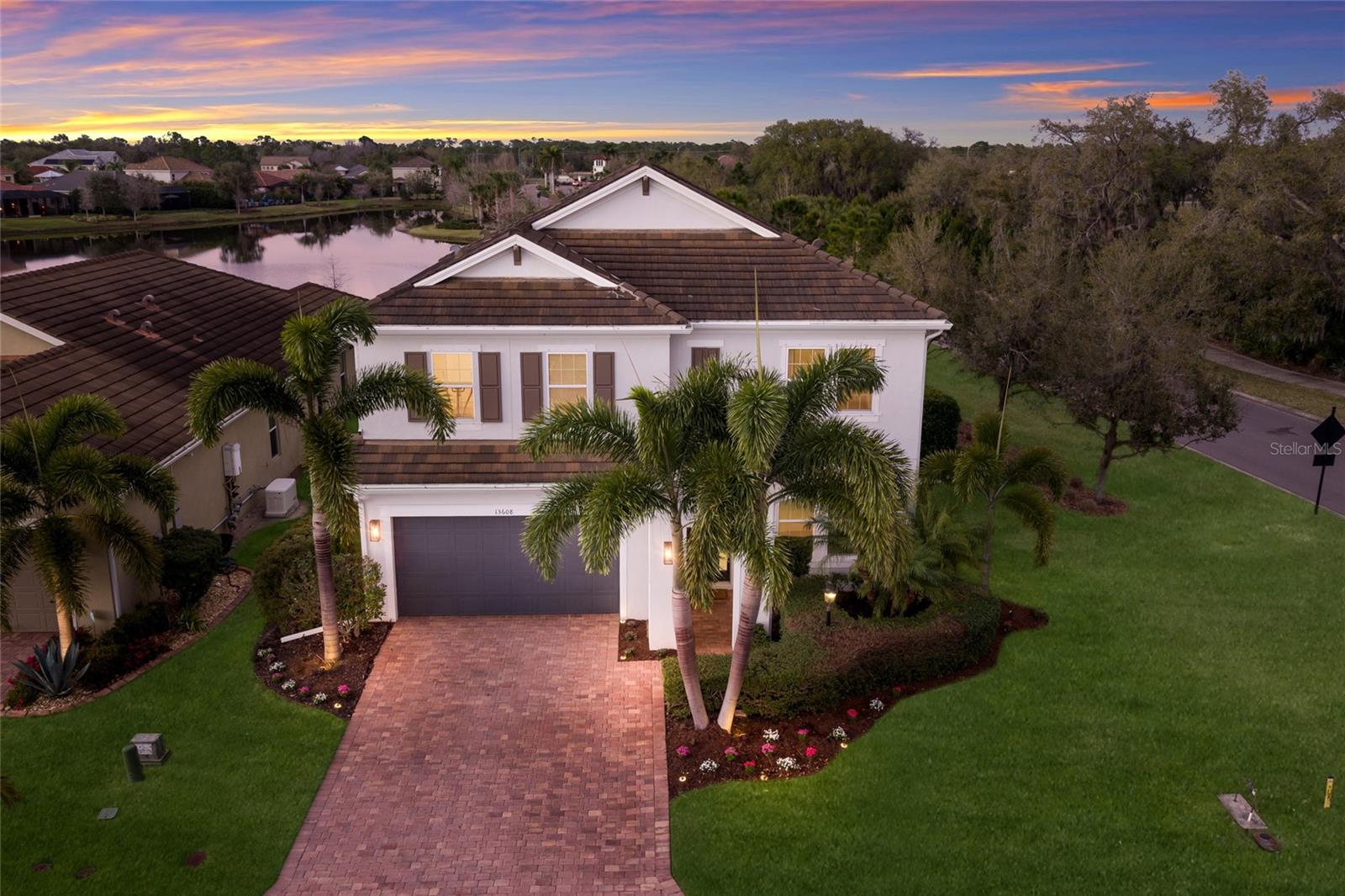 WELCOME to this STUNNING TWO-STORY Palmyra model by Meritage Homes offering 5 bedrooms, 3 bathrooms, a 2 car garage, and 2,906 sq. ft. of thoughtfully designed living space in the sought-after community of Savanna in Lakewood Ranch. Perfectly situated on a CORNER LOT, this home offers both space and privacy and is truly the perfect place to call HOME. As you step inside, you are greeted by a first-floor bedroom and full bathroom complete with a single vanity and walk-in glass shower, making it perfect for guests or a private home office. Continue into the heart of the home where the open-concept kitchen and living room create a bright and welcoming space filled with NATURAL LIGHT from numerous windows and sliders leading to the outdoor lanai and pool area. The living room features a beautiful BUILT-IN STONE ELECTRIC FIREPLACE, creating the perfect spot to relax and unwind after a long day. The chef’s kitchen is fully equipped with ample cabinet space, a TILED backsplash, BUILT-IN oven, cooktop, stainless steel HOOD, and NEW appliances, along with a kitchen island with seating that provides additional workspace and a great gathering place for family and friends. Just off the kitchen is a dining area overlooking the sliders and pool, making it the ideal setting for everyday meals or entertaining. The kitchen space is further enhanced with extended cabinetry offering extra storage and convenience. Upstairs you will find a spacious LOFT/MEDIA ROOM perfect for movie nights, a game room, or additional living space for the family. The expansive primary suite offers a peaceful retreat and features an ENSUITE bathroom with dual sinks and a large walk-in tiled glass shower, while the WALK-IN CLOSET is outfitted with cabinetry providing excellent storage and organization. Three additional bedrooms share a full bathroom with dual sinks and a tub/shower combination, and the laundry room is conveniently located upstairs. Step outside into your PRIVATE outdoor OASIS where the screened-in PAVER lanai features an extended covered area and a fully equipped OUTDOOR KITCHEN with stainless steel appliances and a stone wall bar with seating, creating the perfect space for entertaining. Enjoy the HEATED SALTWATER POOL and SPA, ideal for relaxing while soaking in the beautiful Florida weather. The backyard overlooks a peaceful pond, providing SERENE WATER VIEWS and the perfect backdrop for spectacular sunset evenings. Additional highlights include a built-in SURROUND SOUND SPEAKER SYSTEM on the first floor as well as throughout the outdoor pool area, enhancing both indoor comfort and outdoor entertaining. Savanna is a fabulous community with LOW HOA resort-style amenities such as a clubhouse, swimming pool, state-of-the-art fitness center, basketball courts, playground, dog park and numerous walking paths. Lakewood Ranch is known for their A+ rated school system and is perfectly located just a short ride to downtown Sarasota, St. Pete, world class shopping, fine dining and the FAMOUS Gulf beaches! Don't wait to make this your HOME and begin your FLORIDA Lifestyle!