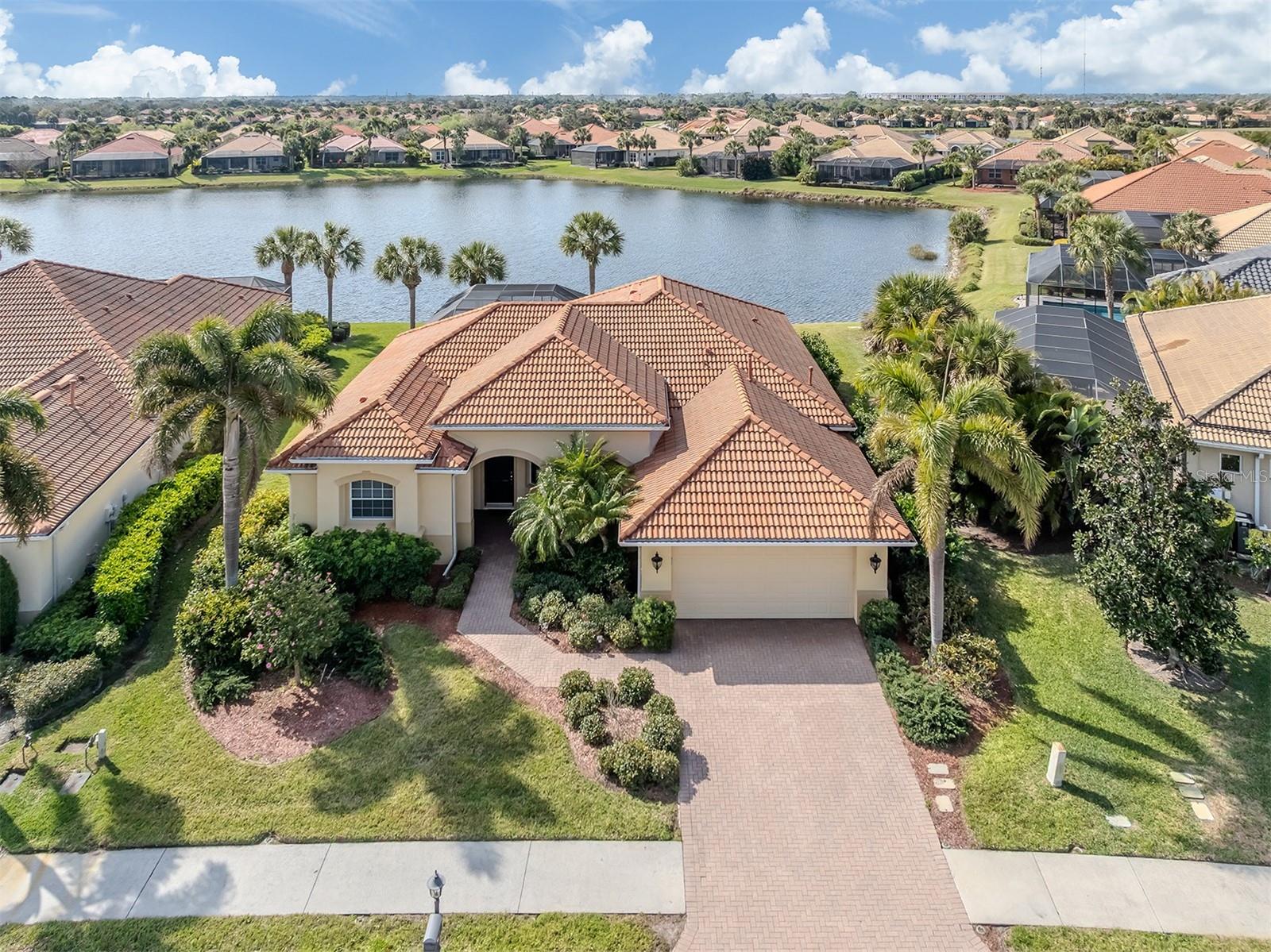 Welcome home to easy Florida living with peaceful lake views right in your backyard. This well-cared home offers 3 bedrooms and 2 bathrooms with a split floor plan that gives everyone their own space. The primary suite is a relaxing retreat with two sinks, a large soaking tub, a separate shower, and a private toilet area. You’ll love how bright and inviting the home feels, with water views from most rooms. The open kitchen is perfect for everyday living and entertaining, featuring granite countertops, warm wood cabinetry, a natural gas stove, and a breakfast bar for casual meals. A separate dining area provides space for family dinners or hosting friends. Thoughtful touches like tray ceilings, crown molding, plantation shutters, and a blend of tile and carpet flooring add comfort and style throughout. Step outside to your screened-in lanai and enjoy the sunny southern exposure. The screened  saltwater pool and deck make it a wonderful place to relax or entertain.  The backyard offers extra room to play, or simply unwind by the water. Other convenient features include an indoor laundry room, plenty of storage, walk-in closets in the primary bedroom, gas water heater, hurricane protection panels for the sliding doors, a tile roof, paver driveway, and a spacious two-car garage. The home is being offered furnished, making your move simple and stress-free. Located in the gated community of Venetian Golf & River Club, residents enjoy 24-hour security and outstanding amenities. The community offers an 18-hole golf course, clubhouse and pro shop, tennis and pickleball courts, a resort-style heated pool, fitness center, on-site dining, and a popular tiki bar. This is a wonderful opportunity to enjoy a comfortable, move-in-ready home in a beautiful setting with great community features — all while being close to everything you need: beaches, banks, shopping,  medical facilities, entertainment, bike trails, cultural events and more!