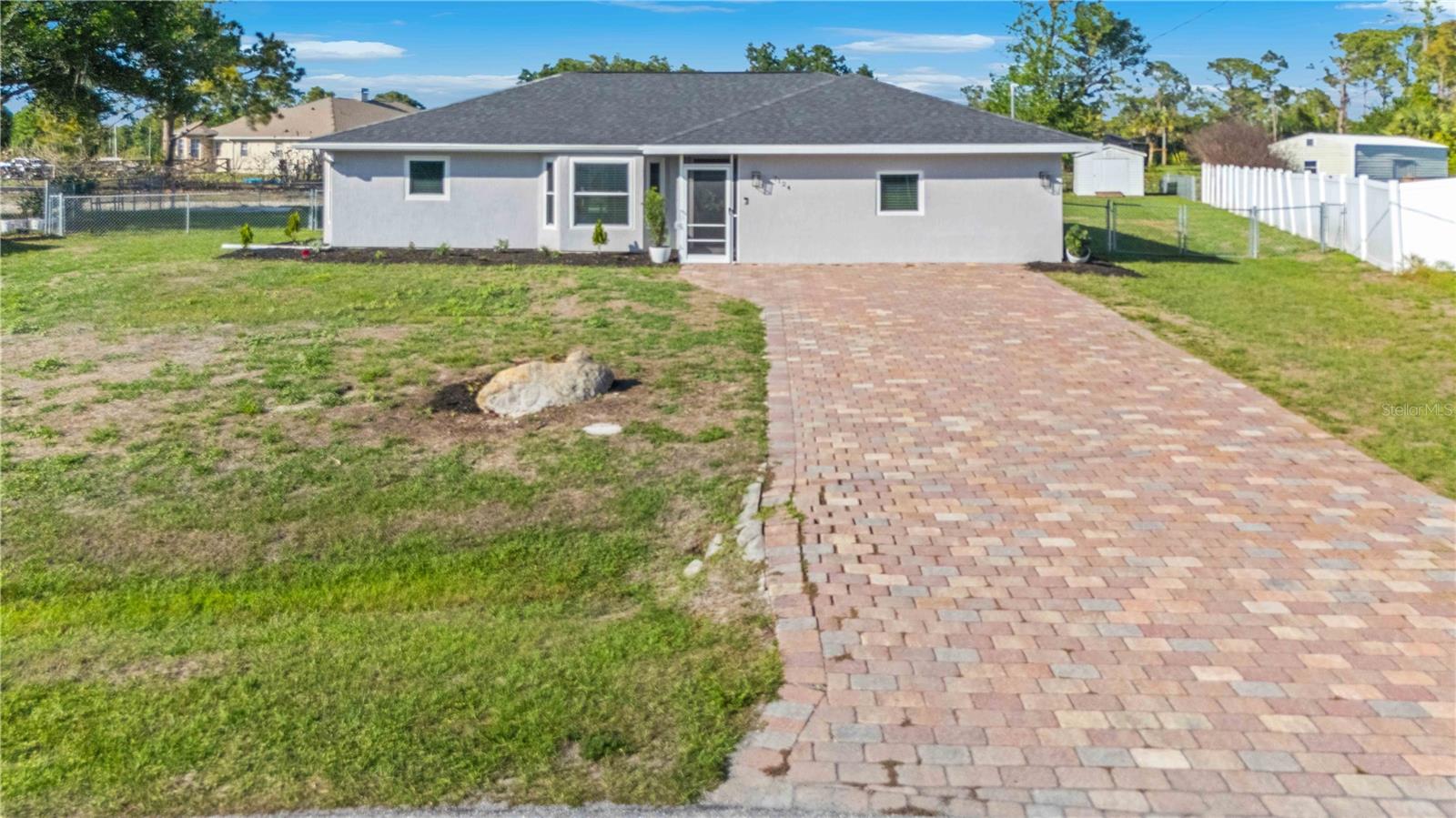 Welcome home to this beautifully updated 3-bedroom, 2-bathroom residence situated on an oversized lot (.42 acres) with a fenced in back yard. No HOA Fees, NOT in a flood zone, and protected by IMPACT RATED HURRICANE WINDOWS AND SLIDERS helping to keep your home protected and your insurance affordable. Brand NEW Roof in 2019, NEW water heater in 2020, and NEW AC in 2018. From the moment you step inside, you’ll appreciate the light, bright, and modern feel throughout. The heart of the home is the stunning, fully remodeled kitchen, featuring crisp cabinetry, stainless steel appliances, a stylish subway tile backsplash, and expansive granite countertops—perfect for cooking, entertaining, or gathering around the oversized island. The open-concept layout flows seamlessly into the dining area, where sliding glass doors bring in natural light and lead to the backyard, creating an ideal indoor-outdoor connection. The spacious primary suite offers a comfortable retreat, complete with an updated ensuite bath and modern finishes. Both bathrooms have been tastefully upgraded with contemporary vanities and fixtures for a clean, refreshed look. The garage was professionally converted/permitted giving you the unique aspect of having such a massive private room that could also be utilized as a private office or game room. Additional highlights include durable wood-look flooring throughout, recessed lighting, a neutral color palette, and generous living spaces ideal for everyday living or entertaining along with a metal shed. Conveniently located near shopping, dining, and major roadways, this move-in ready home is a great opportunity for a primary residence, seasonal home, or investment property.