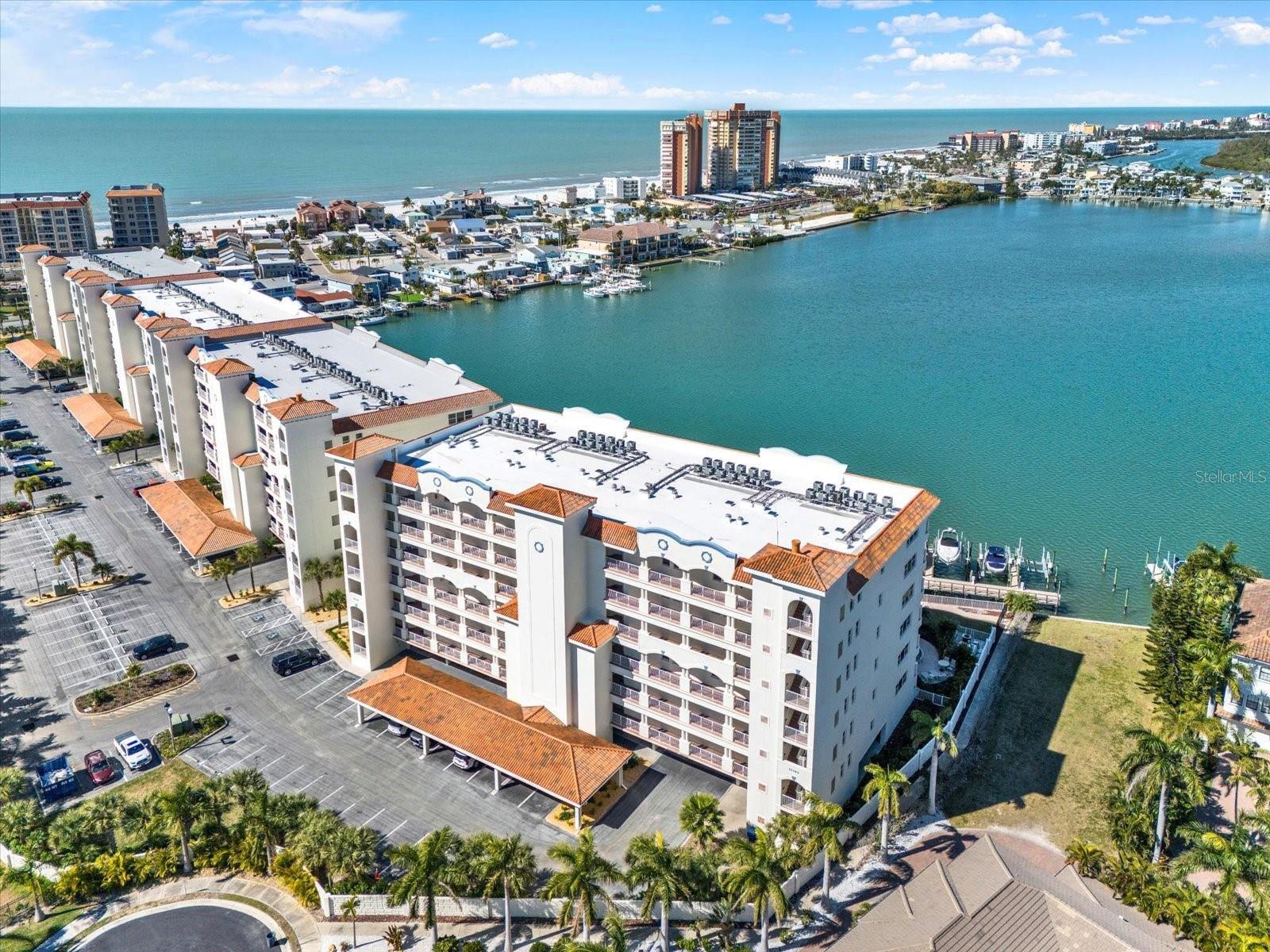 DON’T MISS THIS RARE OPPORTUNITY TO OWN A PIECE OF PARADISE IN THE PRESTIGIOUS, GATED REDINGTON SHORES YACHT & TENNIS CLUB! Located in the highly desirable La Bahia building, this 6th-floor END-UNIT residence offers 3 BEDROOMS, 3.5 BATHS, PLUS AN OFFICE/DEN, and over 3,000 square feet of refined coastal living, just steps from the gorgeous Gulf beaches. Built in 2007, La Bahia is known for some of the most breathtaking water views in the entire community, with panoramic views from every direction. The timeless interior features an open-concept layout with a spacious kitchen overlooking the main living area, complemented by plantation shutters and dramatic floor-to-ceiling windows framing the protected cove below. The kitchen is well appointed with granite countertops, stainless steel appliances, solid wood cabinetry, tray ceilings, a center island, and breakfast bar. Two generously sized guest suites each include en-suite baths, while the versatile den/study can easily function as a fourth bedroom and offers an attached half bath. The luxurious primary suite is a true waterfront retreat, featuring private balcony access through HURRICANE-IMPACT SLIDERS, DUAL WALK-IN CLOSETS, tray ceilings, and a spa-inspired bath with dual vanities, walk-in shower, and jetted tub. Additional highlights include abundant storage, SPACIOUS LAUNDRY ROOM, 2 HVAC SYSTEMS REPLACED IN 2018, NEW ROOF IN 2025, 2 UNDER-BUILDING PARKING SPACES, AND A DEEDED CABANA. This pet-friendly community allows up to 2 pets (25 lbs each) and 30-day rentals, making this an excellent primary residence, vacation home, or investment opportunity. Sellers will credit $10,000 at close toward paint/flooring with acceptable offer. Building updates include exterior painting completed in 2023. Residents enjoy resort-style amenities such as a heated pool and spa, fitness center, clubhouse, tennis and pickleball courts, and 24/7 gated security. Monthly dues include water, sewer, trash, recycling, pest control. Residents pay discounted internet cable fee from Spectrum 30$ months. Live the waterfront lifestyle you’ve been dreaming of and schedule your private showing today!
