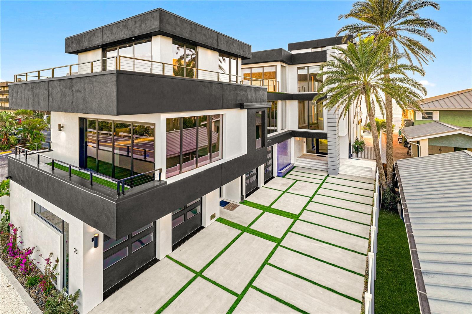 Designed for elevated coastal living, this exceptional New Construction delivers modern beachfront luxury. An artful blend of architectural distinction, state-of-the-art design, and modern innovation provides the ultimate in beachfront living.  With 8,042 AC sq ft combined, the gated estate includes a Main House with 7,000 AC sq ft and an attached Guest House with 1,042 AC sq ft, each with its own private entrance (per builder plan). The first level provides flexible spaces for living and entertaining with an expansive game room and full entertaining bar, sweeping beach views and expansive sliders to the pool. The first level continues with a private office, gym with sauna, full bath and guest bedroom, with elevator access to the remaining floors. The second living level boasts a light-filled living area, highlighted by a striking fireplace feature and framed by magnificent Gulf beach views that create a breathtaking backdrop for luxury living and entertaining. A custom floating staircase and glass-enclosed wine cellar make an immediate statement of refined design, while wall-to-wall glass sliders assure panoramic beach views at every turn. Designed for elevated entertaining experiences, a sleek dual-island chef’s kitchen showcases Wolf and Miele® gas appliances, custom cabinetry, a formal dining room and statement lighting. Purposeful design on the second level includes a state-of-the-art home theater with full surround sound and wet bar, library, ensuite guest bedroom with terrace. The gracious primary suite is a tranquil escape, where sweeping beach views greet you through wall-to-wall glass doors that open to a private terrace. Appointments include a morning bar, an opulent custom closet/dressing room, and a luxuriant spa-inspired bath with deep soaking tub and refined finishes.  Outdoors, a true oasis and your private coastal escape provides the ultimate in Florida coastal living with a custom 15’ x 30’ pool, floating spa and sun deck. The pinnacle of this beachfront lifestyle is found on the rooftop terrace where you’ll find unparalleled vistas of sea and sky for unforgettable entertaining. The two-level attached guest space offers a living area and kitchenette, along with a bedroom, bath, laundry room, and wrap-around terrace. The attached guesthouse offers a living area, kitchen, 1 ensuite bedroom, a powder room, x space, and rooftop terrace. Construction features include pilings, concrete block exterior walls and impact-rated windows and doors. Smart living features include an Elan home audio system. Completing this statement of distinction is a four-car garage, concrete drive and pool deck with artificial turf inlays, and meticulous attention to detail throughout—delivering a Gulf front estate that provides elevated luxury and coastal refinement. Located in a golf-cart-friendly coastal community with nearby parks, dining, shopping, an art center, library and convenient access to regional airports. Short-term rental use may be permitted pursuant to local regulations; buyer to independently verify all restrictions. Boat Dock located across the street is currently in permitting with final approval. See attachment for dock specifications.