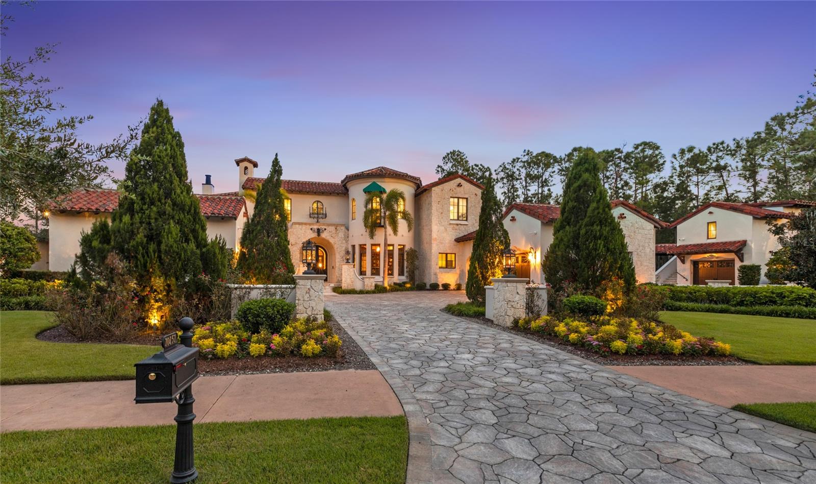 Nestled deep inside the coveted Carolwood neighborhood of Golden Oak at Walt Disney World® Resort, this nearly 11,000 sqft Mediterranean estate offers a rare combination of scale and one-of-a-kind details. Situated on a .79-acre lot, siding and backing to conservation, the home also enjoys serene pond views and ultimate privacy. Inside, soaring ceilings and a sweeping staircase set the tone, anchored by a custom crystal chandelier. A row of Disney-themed stained-glass windows adds a whimsical touch, overlooking the courtyard and sparkling resort-style pool. The chef’s kitchen overlooks a two-story great room and is designed for both function and beauty, featuring top-of-the-line appliances and extensive storage inside custom cabinetry. With 7 bedrooms and 7.2 baths, including a fully detached apartment over the garage, the layout is ideal for family or guests alike. The first-floor master suite is a private retreat, complete with two gas fireplaces, a sitting area overlooking the pool, and a spa bath with soaking tub and walk-in shower. Additional highlights include a Millennium Falcon–inspired theater, temperature-controlled wine room, Toothless pizza oven, an exact replica of the marble fireplace from Cinderella’s Castle apartment, and a massive game room perfect for entertaining, gaming, and/or homeschooling. Outside, the true resort-style setting is unmatched. A pool with grotto, spa, slide, and rock waterfall is complemented by multiple fire pits, expansive covered courtyards, and a summer kitchen for indoor/outdoor living. Car enthusiasts will appreciate the four separate garages, three outfitted with lifts to accommodate up to seven cars. Located just a short drive from Summerhouse and the Four Seasons Resort, this estate offers a rare opportunity to own one of Golden Oak’s most remarkable residences.