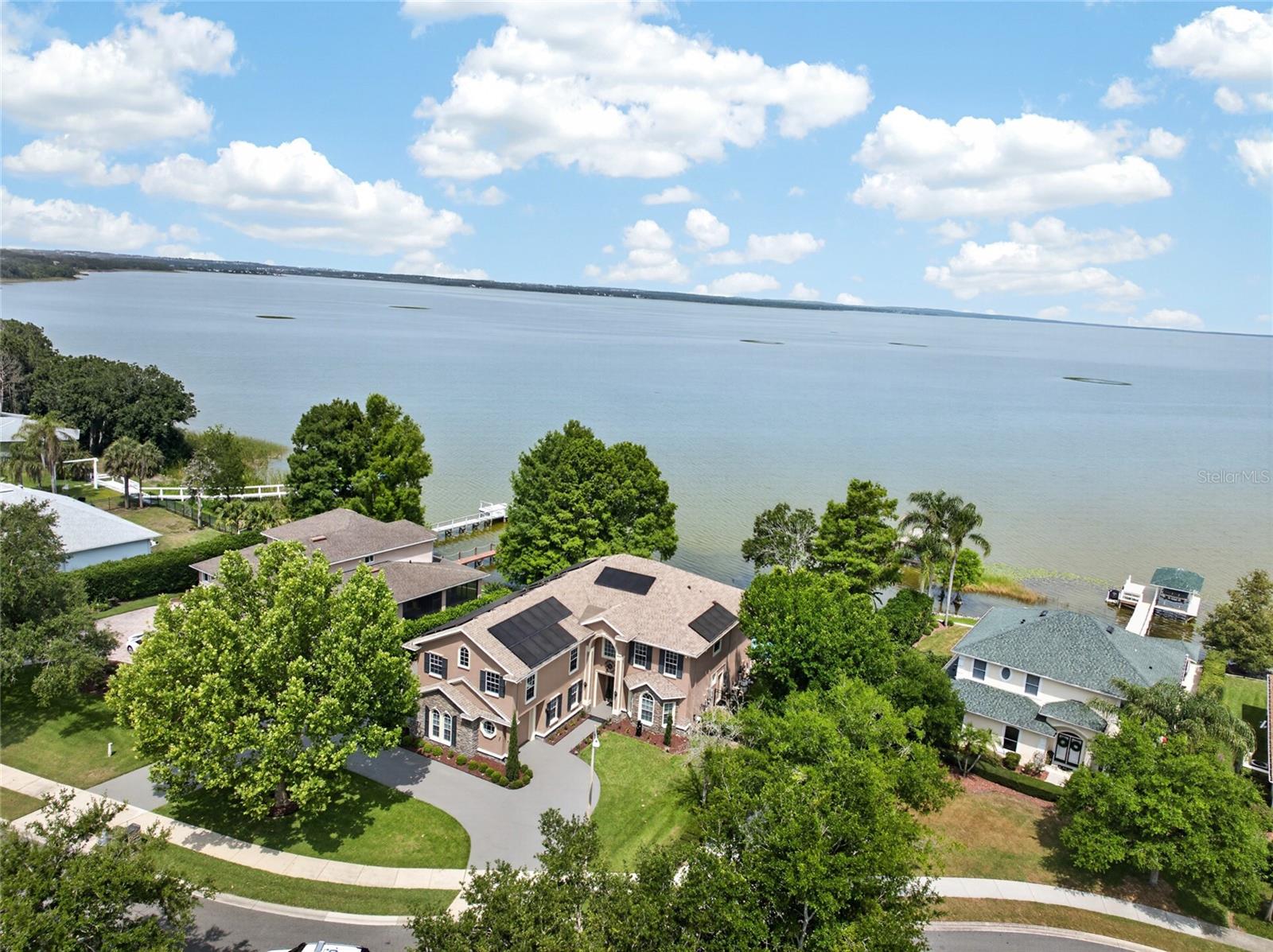 An unparalleled lakefront opportunity in Downtown Winter Garden **Seize the rare chance to own a premier waterfront estate where the true value lies in the spectacular lot, private dock, and an enviable golf-cart lifestyle ** Launch your boat from your private lift for a scenic 30-minute cruise to Mt. Dora or take your golf cart just minutes away to the historic downtown Farmers’ Market and restaurants **Positioned within a private, gated enclave directly across from the West Orange Trail, this property offers the ultimate Florida resort lifestyle outside, featuring a heated saltwater pool, raised spa, and a fully fenced, expansive lakeside yard ** Inside, the home boasts a massive primary suite +/16x26’ with tray ceiling, fireplace and a balcony with lovely lake views and massive +/-23x25 bonus room including a wet bar and  fireplace** The kitchen has a large cooking island w/sink plus a separate breakfast bar, stone counters, under cabinet lighting, a Jenn-Air double convection oven and lovely dining area overlooking the lake ** There's even an open wine closet/alcove with wine refrigerator off the kitchen ** First floor bedroom with an oversized walk in closet as a 5th bedroom or den (currently being used as a dining room) ** Other home upgrades include a newer roof +/-2022, 3 newer A/C units, a whole-home Katolight 40KW generator that runs +/- 90% of the home, crown molding throughout the home, ADT security system with cameras, boat house with new roof 2025, resurfaced pool +/-5 yrs ago & Aqualink pool/spa automation system and a 10’ seawall ** Relax on the covered screened patio with the Bose speaker system and prime outdoor living space including additional yard space beyond the  pool and patio ** 2 car garage plus a 1 car garage with easy access to the back yard perfect for bringing your boat or lawn equipment through ** LOW HOA fees $200 quarterly  ** All room measurements in MLS and on 3d floorplan are approximate. Buyer to verify. Tax record is incorrect - property has 5 bedrooms. Dock measurement is estimated. Buyer to verify. Solar panel lease to be transferred to buyer at closing.