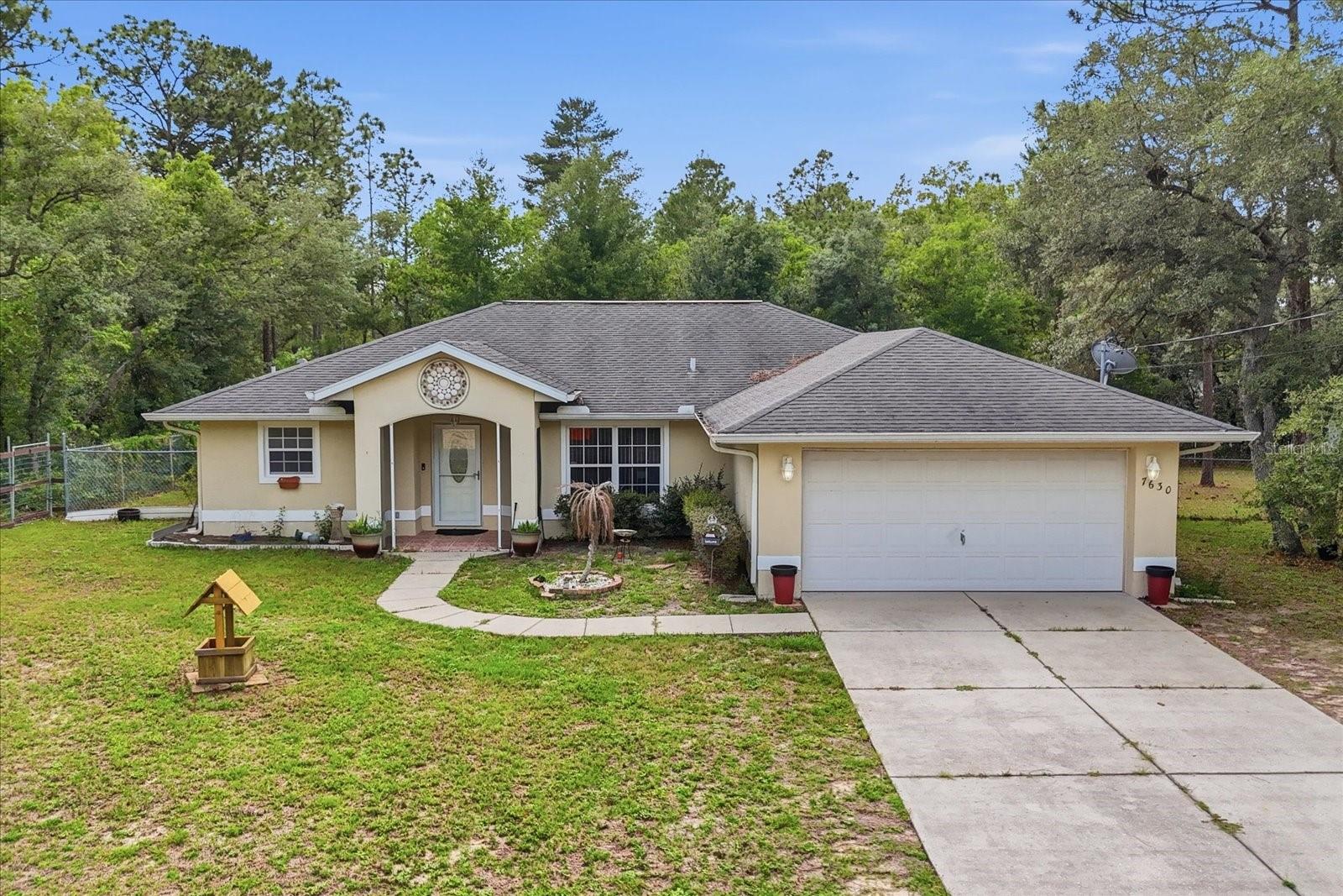 One or more photo(s) has been virtually staged. A cut above the rest! From the unique home design to the prime location, this three bedroom, two bathroom home truly stands out. Designed with function in mind, the home offers a spacious living area, a bartop kitchen, and a smooth flow into the dining room. The split floor plan places generously sized guest bedrooms and a full bathroom on one side of the home, while the owner’s suite sits privately on the other with an oversized walk-in closet and a large bathroom for added comfort. Tile flooring runs throughout most of the home for easy maintenance and lasting appeal, while the kitchen features wood cabinetry and stainless steel appliances. Indoor laundry, a two-car garage, and a covered screened back patio with an electric fireplace add even more everyday convenience. Out back, enjoy a sense of privacy with the home backing up to a large undeveloped parcel, plus an additional vacant lot next door is also available for purchase, giving the new owner room to grow and enjoy extra space(7648 N Galt Pt). Located not far from main access roads, this home keeps you close to Lecanto, Crystal River, and an easy commute toward Ocala while still offering that peaceful Nature Coast feel. This one is ready to be made your home!
