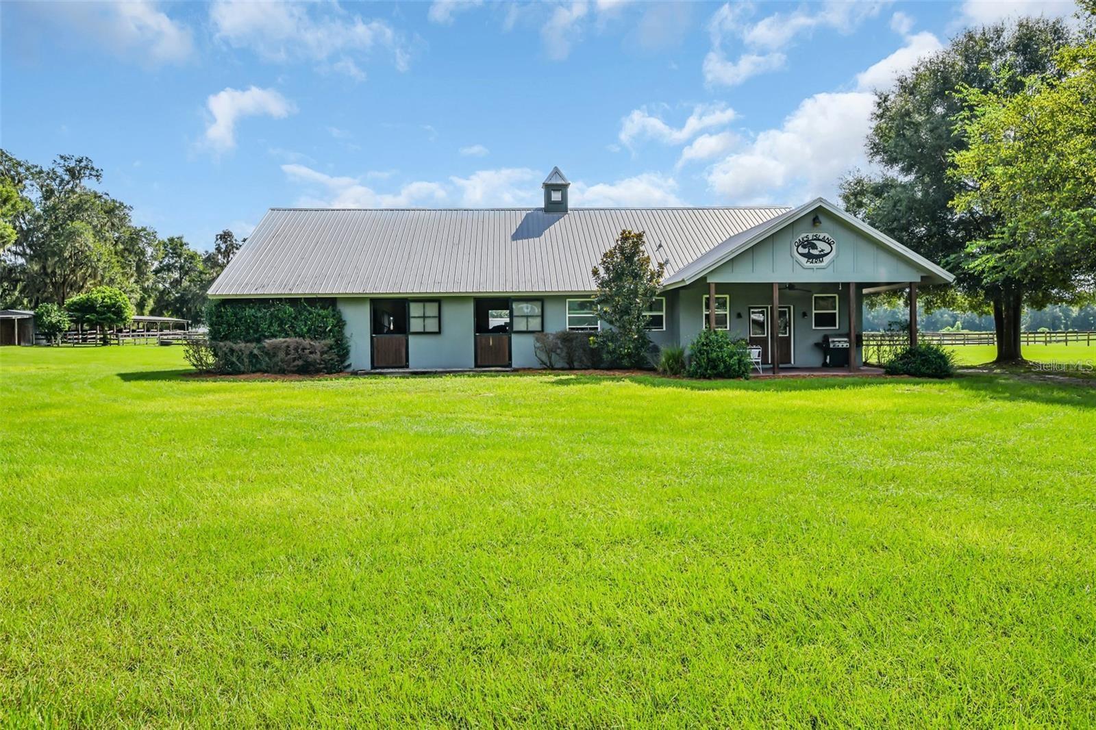 Tucked away on a beautiful winding paved road shaded by majestic old oak trees and surrounded by picturesque horse farms, this exceptional 10.58 acre equestrian property offers privacy, functionality, and peaceful country living. Conveniently located just 12 miles from the World Equestrian Center and only 4 miles from HITS Ocala, this property is ideal for horse enthusiasts or trainers seeking a premier farm setting. Fully fenced and thoughtfully laid out, this farm includes 4 pastures, a round pen, and multiple ideal build sites for a future custom home, offering plenty of space and flexibility. One of the pastures also features a run in shed for added convenience. The main barn built in 2018 is exceptionally well designed, it offers 5 stalls with European fronts plus 2 additional stalls for a total of 7 stalls. Each stall includes a rear access door, allowing for individual paddocks and private run outs. The barn is equipped with tongue and groove ceilings, ample lighting, fan hookups, Dutch doors with plexiglass tops, a wash stall with hot water, tack room and feed room. Attached to the barn is a fully finished studio apartment with a mini split unit, full kitchen, washer & dryer, and a beautifully upgraded bathroom featuring a tiled walk in shower. The second barn includes 8 airy catch pen style stalls plus an enclosed shop for equipment or tractor storage. Additional features include a 50 amp RV hookup with water at the well and quiet road access for riding directly off the property. Deed restrictions maintain the area’s quality with an 1,800 sq ft minimum, single family homes only. This is a rare turnkey equestrian opportunity in the heart of horse country, schedule a private tour before it’s too late!