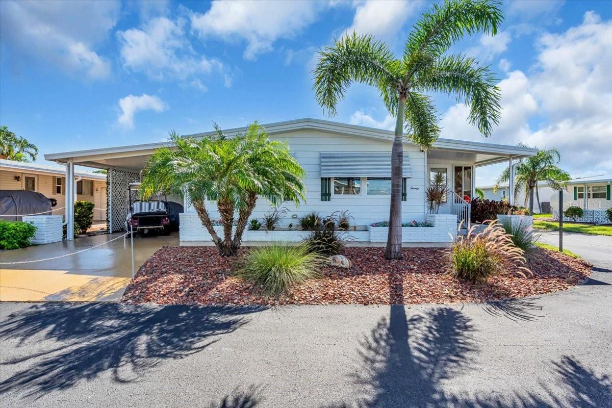 Absolutely stunning and just minutes from two public beaches. This beautifully updated and fully furnished home is located on and oversized corner lot in the highly sought-after resort-style waterfront community of Alameda Isles. Alameda Isles has its own marina with 58 boat slips and direct access to the Intracoastal Waterway and the Gulf of Mexico, this is coastal living at its finest. Welcome to this meticulously maintained and tastefully upgraded residence in this desirable 55+ gated community. Being sold turnkey furnished, this home is truly move-in ready. Major updates include a new roof and York A/C unit (2019) with warranty, hot water heater (2018), new electric panel and wiring (2025), and a new microwave (2025). All appliances are 2017 or newer. Inside, you’ll find no carpeting—only tile and luxury vinyl plank flooring throughout. Additional upgrades include six-panel doors, crown molding, new light fixtures, and updated ceiling fans. The custom-designed kitchen is a showstopper, featuring granite countertops, a large island with a built-in wine rack, tile backsplash, stainless steel appliances, a hidden dishwasher, a unique swing-out corner cabinet, and an open-concept layout that flows seamlessly into the living and dining areas. The dining area is perfect for everyday living and entertaining, featuring a dining room table with two leaves that expands to comfortably seat eight for holidays or gatherings with guests. The spacious enclosed Florida room offers privacy-darkening windows and an electric fireplace, creating the perfect year-round retreat. This home is being sold fully furnished—just bring your clothes and toothbrush. The furnishings are stylish and comfortable, including a sofa with dual recliners, a loveseat with dual recliners, and two additional individual recliner chairs—ideal for relaxing or entertaining. Situated on a beautifully landscaped corner lot with mature palm trees, the exterior is equally impressive. There is a private irrigation system on its own well, a newly painted driveway, and a large shed complete with a workbench, as well as a washer and dryer. The outdoor kitchen features a stainless steel sink with hot and cold water and granite countertops—perfect for entertaining. All extended roofs over the carport and Florida room were reinforced in 2024 for added peace of mind. Resort-style living truly shines at Alameda Isles. Residents enjoy a heated swimming pool and therapeutic spa, fitness center, and courts for tennis, pickleball, bocce, and shuffleboard. The beautifully landscaped private park includes picnic areas, a putting green, and a golf driving cage, along with scenic walking trails around several lakes with breathtaking fountains. The clubhouse serves as the heart of the community, offering free Wi-Fi, a full kitchen, library, craft and billiard rooms, sauna, and an expansive event hall overlooking the marina. Year-round social events, clubs, and seasonal activities create a welcoming and connected atmosphere. Additional conveniences include a 58-slip marina with direct Gulf access, RV and boat storage yard, woodworking shop, scenic walking trails, and five tranquil lakes. Alameda Isles isn’t just a neighborhood—it’s a lifestyle. Don’t miss this incredible opportunity to own your piece of paradise.