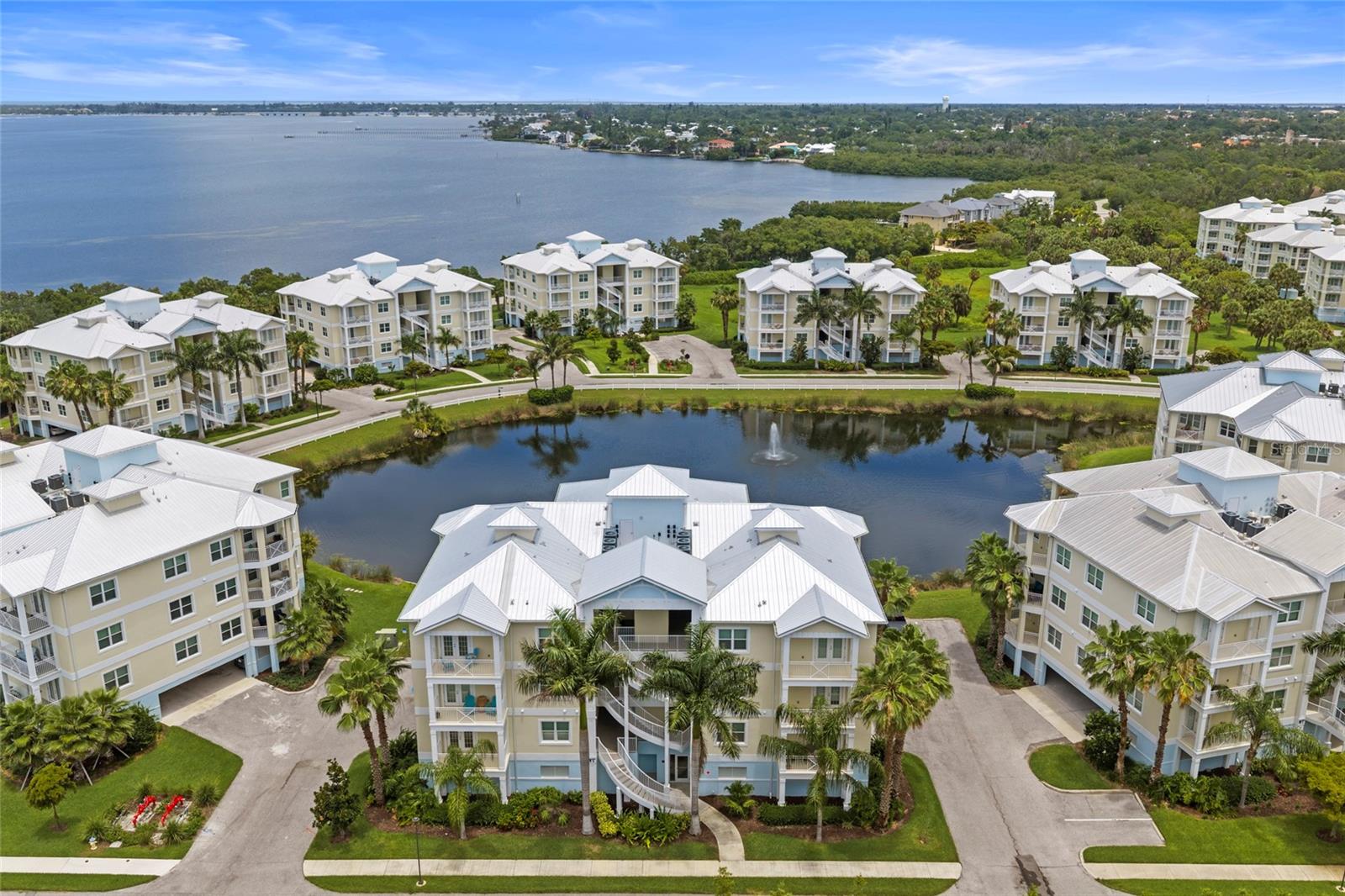 Welcome to resort-style living at its finest in this beautifully appointed two-bedroom, two-full-bath condo nestled within a prestigious gated waterfront community with breathtaking views of Palma Sola Bay. From the moment you arrive, the lush tropical landscaping, manicured grounds, and serene pond with fountain set the tone for an elevated lifestyle. Step inside to a bright, open-concept layout bathed in natural light from an abundance of oversized windows. The expansive great room flows effortlessly into the chef-inspired kitchen, featuring premium gray shaker cabinetry, striking granite countertops, a large island with bar seating, stainless steel appliances, and elegant pendant lighting perfect for entertaining or quiet evenings in. The primary suite is a true retreat, offering generous square footage, plush carpeting, multiple windows framing peaceful community views, and a spa-quality en suite bath complete with dual vanities, granite counters, a walk-in glass shower with ceiling-mount rain head, a luxurious soaking tub, and designer tile throughout. The spacious second bedroom is equally well-appointed with its own walk-in closet and easy access to the second full bath. Additional highlights include a dedicated laundry room with full-size Samsung washer and dryer, upper cabinetry, and a utility sink a rare and coveted feature. Community amenities include a resort style pool, boat and kayak launch, fire pt, billards room, barbeque areas, tranquil lakeside grounds, and access to stunning Palma Sola Bay just moments from Anna Maria Island, IMG Academy, top-rated dining, and the best of Florida's Gulf Coast lifestyle.