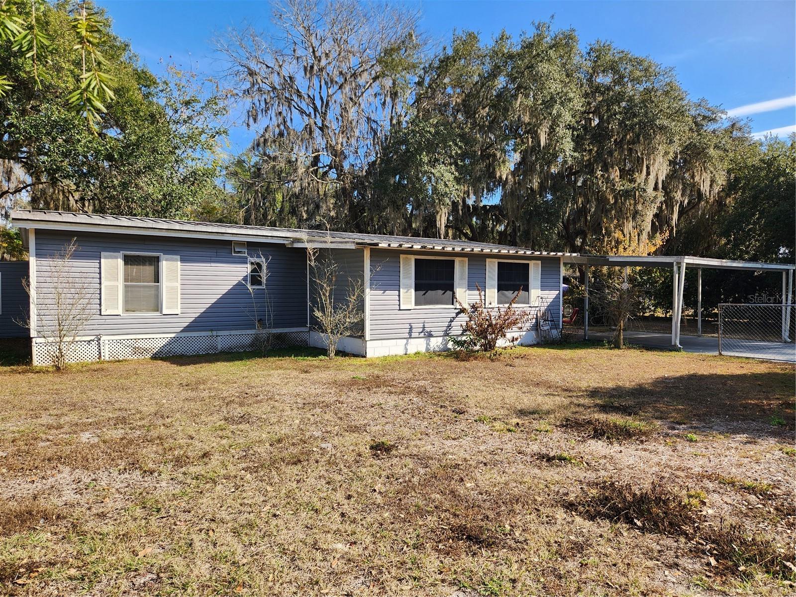 Welcome to this charming 3-bedroom, 2-bathroom mobile home. This property offers comfortable living with plenty of extra space for your hobbies and/or storage. Completely fenced in yard, 2 storage sheds, and a small workshop. Nice carport for parking out of the sun or rain. Whether you are looking for a cozy starter home, downsizing, or seeking an investment opportunity, this property delivers great value with room to grow. There is an office/study/playroom off of one of the bedrooms. A bonus space off of the living room. Spacious kitchen which overlooks the dining room.