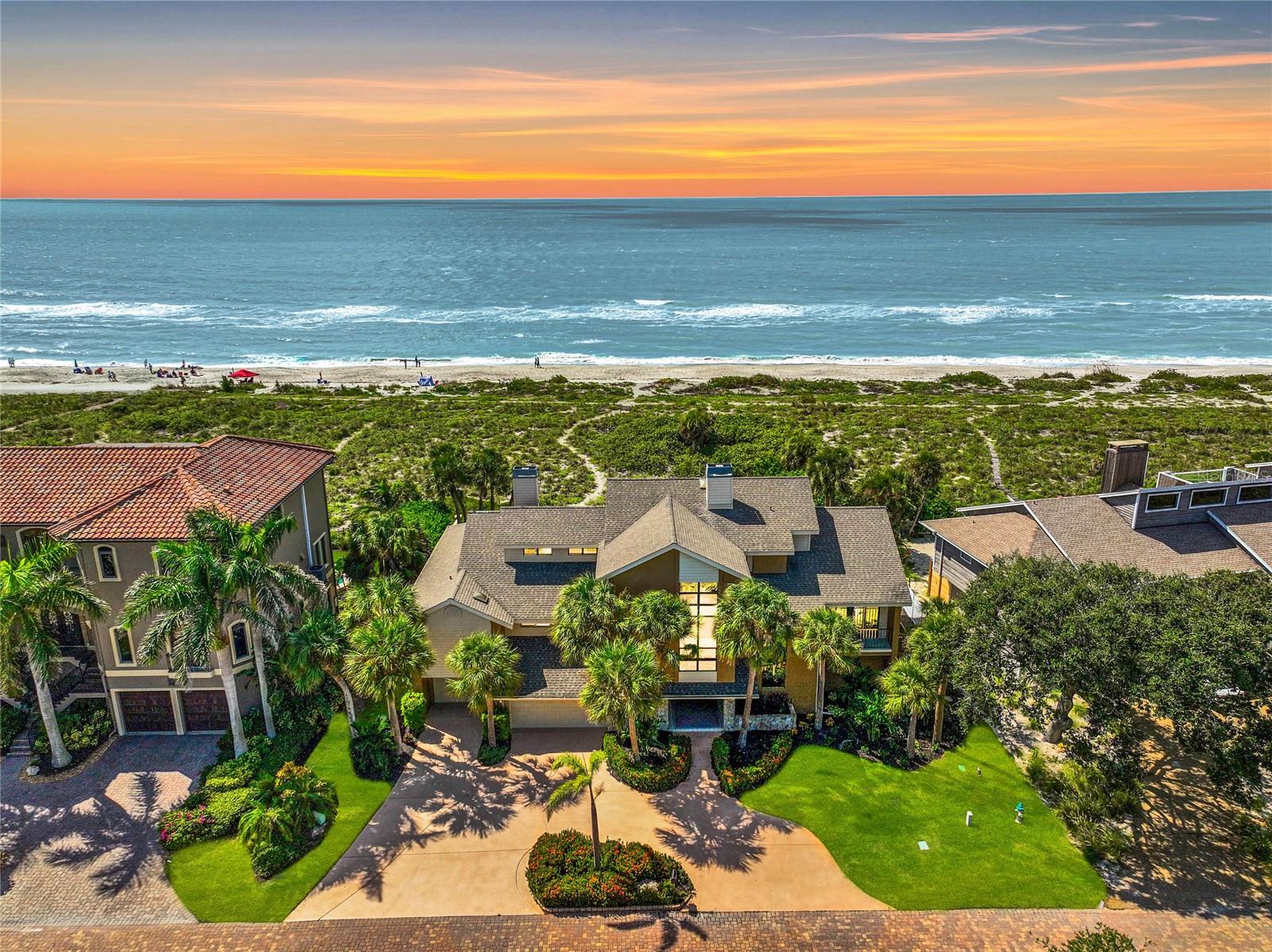 HURRICANE UPDATE - WATER NEVER REACHED THE HOME (INSIDE) - New and Improved Price! Welcome to your exclusive Gulf of Mexico beach house retreat on Siesta Key, where luxury seamlessly merges with the allure of Turtle Beach in Tortoise Estates. Located on the Gulf, this 4-bedroom luxury residence epitomizes coastal living, offering private beach access and spectacular, panoramic views of the Gulf of Mexico stretching from Lido Key to the Venice Inlet. As you step inside, an elevator or staircase leads you to the main floor, where cathedral ceilings welcome you to a world of opulence. The formal, but open concept, living and dining rooms feature a wall of sliding glass doors that open to the screened porch offering panoramic views of the pristine beach and exterior landscapes. The heart of the home lies in its open concept living space, featuring a kitchen, family room, and casual dining area. Enjoy morning coffee on the deck and daily meals with ocean vistas, conveniently prepared in the well-appointed kitchen, complete with an electric cooktop and breakfast bar. The family room is brightened by cathedral ceiling windows, anchored by an incredible, two-story stone fireplace that creates a cozy, serene space that is connected to the screen porch by a wall of expansive sliding doors and breathtaking beach views. The main level hosts the private primary suite, a sanctuary with high ceilings, abundant natural light, and an ensuite bathroom featuring a soaking tub, shower, vanity with extensive space and two walk-in closets. The bedroom has beach views and sliding doors that open to the covered porch, which has floor to ceiling screens and runs the full 80’ length of the home connecting it with the family room, kitchen, dining and living rooms. The porch ties the entire main floor together and provides a weather protected perch to enjoy spectacular Gulf views and mesmerizing sunsets. A private office with a wall of built-in drawers and glass cabinets is the perfect venue for remote working and completes the main living level. The upper floor offers a perfect oasis for family or guests, featuring two spacious bedroom suites with sliding glass doors that open onto an expansive sundeck with incredible, panoramic views of the Gulf while providing a private, sunbathing space. A third bedroom flooded with natural light overlooks the front of the property. It includes garages for three cars, storage for kayaks, watersports, bikes, & outdoor gear. The first floor has a covered entry located just off the circular driveway that opens to a two and ½ story entry hall, stairway and private elevator servicing all three floors. As you enter you will find a finished, expansive space of more than 1,400 square feet. This space consists of a recreation room, and serving area perfect for pool side entertaining, as well as an additional flex space that is currently being utilized as a suite. This first floor opens, via three glass sliding doors, to a private outdoor oasis featuring a lawn and plantings, sun drenched patio, heated saltwater swimming pool, oversized heated spa, and an outdoor shower. This haven is hidden from the view of beachcombers & sunbathers by 200 feet of environmentally protected rolling sand dunes. A private, serpentine path connects your oasis to the Gulf waters and the sands of Turtle Beach. This Florida dream home isn’t just a residence; it’s a gateway to a lifestyle of sun, sand, & endless possibilities. ¤ Please see 3D Tour and Video ¤