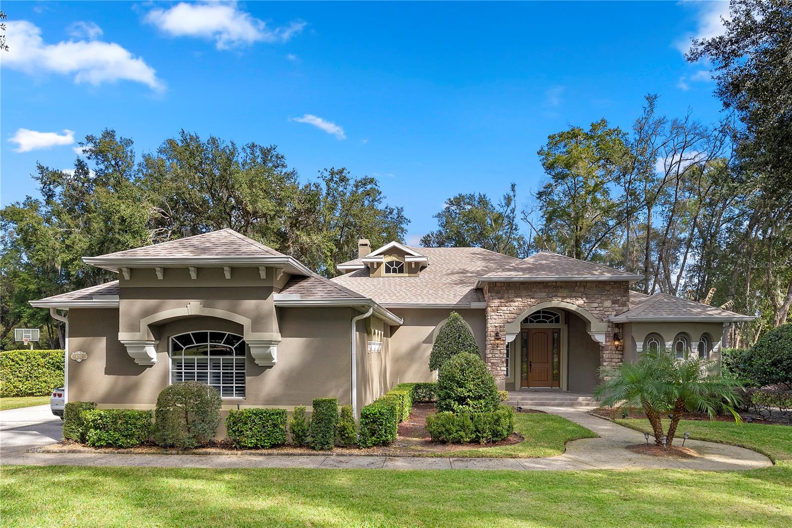 Experience the perfect blend of "country quiet" and modern prestige in this gorgeous 4BD/4BA pool home. Located in an exclusive gated community on a lush one-acre lot, this estate is framed by majestic oak trees and backs to a serene conservation area.
The interior impresses with solid wood flooring, plantation shutters, and bronze fixtures throughout. Upon entry, soaring bay windows offer immediate views of the shimmering pool. The gourmet kitchen is a chef's dream, featuring solid maple cabinetry, granite counters, a tumbled marble backsplash, and stainless appliances. It flows seamlessly into the family room, anchored by a wood-burning fireplace and custom built-ins.
The primary sanctuary offers poolside French doors and a spa-like bath with dual vanities, a garden tub, and custom "his and hers" closets. For the connoisseur, a dedicated wine cellar adds an extra layer of luxury. Upstairs, the expansive bonus room features a full bath and a screened balcony overlooking the water.
Outside, a covered brick-paver lanai leads to the pool, while the side-entry 3-car garage and full sprinkler system provide modern convenience. Minutes from Lake Mary/Heathrow shopping and I-4, this is the ultimate private sanctuary.