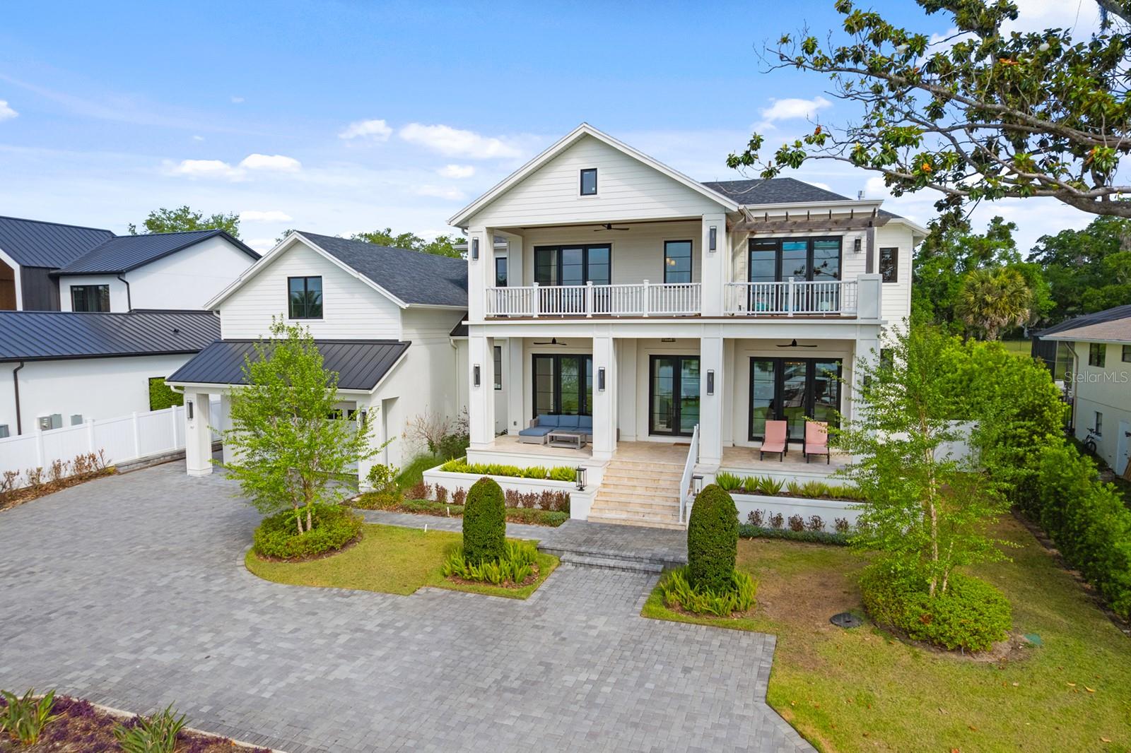 Under contract-accepting backup offers. Welcome to 747 N Lake Sybelia Drive, an extraordinary lakefront estate gracefully positioned along the desired northern shoreline of beautiful Lake Sybelia. Completed in late 2023, this breathtaking California Coastal-inspired residence spans 4,755 square feet on an expansive 0.76-acre homesite, blending timeless architecture with refined finishes to create a lifestyle defined by elegance, comfort and effortless lakefront living. Ideally situated on a gently sloping lot, the home captures stunning elevated views of the water, offering a rare sense of privacy, tranquility and perspective. Thoughtfully designed interiors are filled with natural light and crafted for everyday living and exceptional entertaining. The main level showcases a beautifully appointed chef’s kitchen anchored by an oversized island and complemented by a spacious walk-in butler’s pantry. Open-concept dining and living spaces are framed by picturesque lake views, while the expansive great room seamlessly connects indoor and outdoor living. A private office, guest suite and dedicated pool bath complete the first floor. Upstairs, a versatile loft and homework nook provide flexible living space, while two en-suite bedrooms and a serene primary retreat offer exceptional comfort and privacy. The luxurious primary suite and one secondary bedroom open to a spacious lakeside balcony, an idyllic place to enjoy morning coffee, evening sunsets and sweeping water views. Exceptional outdoor living spaces surround the home. A welcoming covered front porch offers the perfect vantage point to enjoy lake views and watch boating activity, while the expansive rear covered lanai is designed for year-round entertaining with a summer kitchen and generous space for lounging and dining. Overlooking the beautifully landscaped backyard, complete with bamboo-lined fencing for privacy, is a sparkling saltwater pool and spa by Titan Pools, thoughtfully designed for resort-style enjoyment and capable of both gas and electric heating. Uniquely embraced by water and recreation, the home enjoys tranquil lake vistas to the south and the stunning pool retreat to the north. The waterfront experience is elevated by a newly constructed composite dock with a heavy-duty dual-motor lift, while a thoughtfully designed shell-base boat ramp provides seamless, eco-conscious access for launching watercraft directly from your property. Adding even more versatility, a 500+ square-foot unfinished bonus room above the garage offers incredible potential for customization, ideal for a media room, guest retreat, fitness studio or creative space. Plumbing has been extended for a future bath or bar, and the space is currently enjoyed as a golf simulator. Car enthusiasts will appreciate the impressive four-car tandem garage featuring soaring 15-foot ceilings designed to accommodate vehicle lifts, premium wall-mounted jackshaft openers for maximum overhead clearance and a separate side-access bay ideal for golf cart storage. Engineered for longevity as much as luxury, the home features an extensive stormwater drainage system with hard-piped gutters designed to protect the land and prevent erosion. Ideally located, enjoy a short visit or golf cart ride to Maitland City Centre and Homer Hough Park at Sybelia Point, while the shopping and dining of Park Avenue are just minutes away. Convenient access to Interstate 4 and express lanes ensures effortless travel throughout the greater Orlando area.