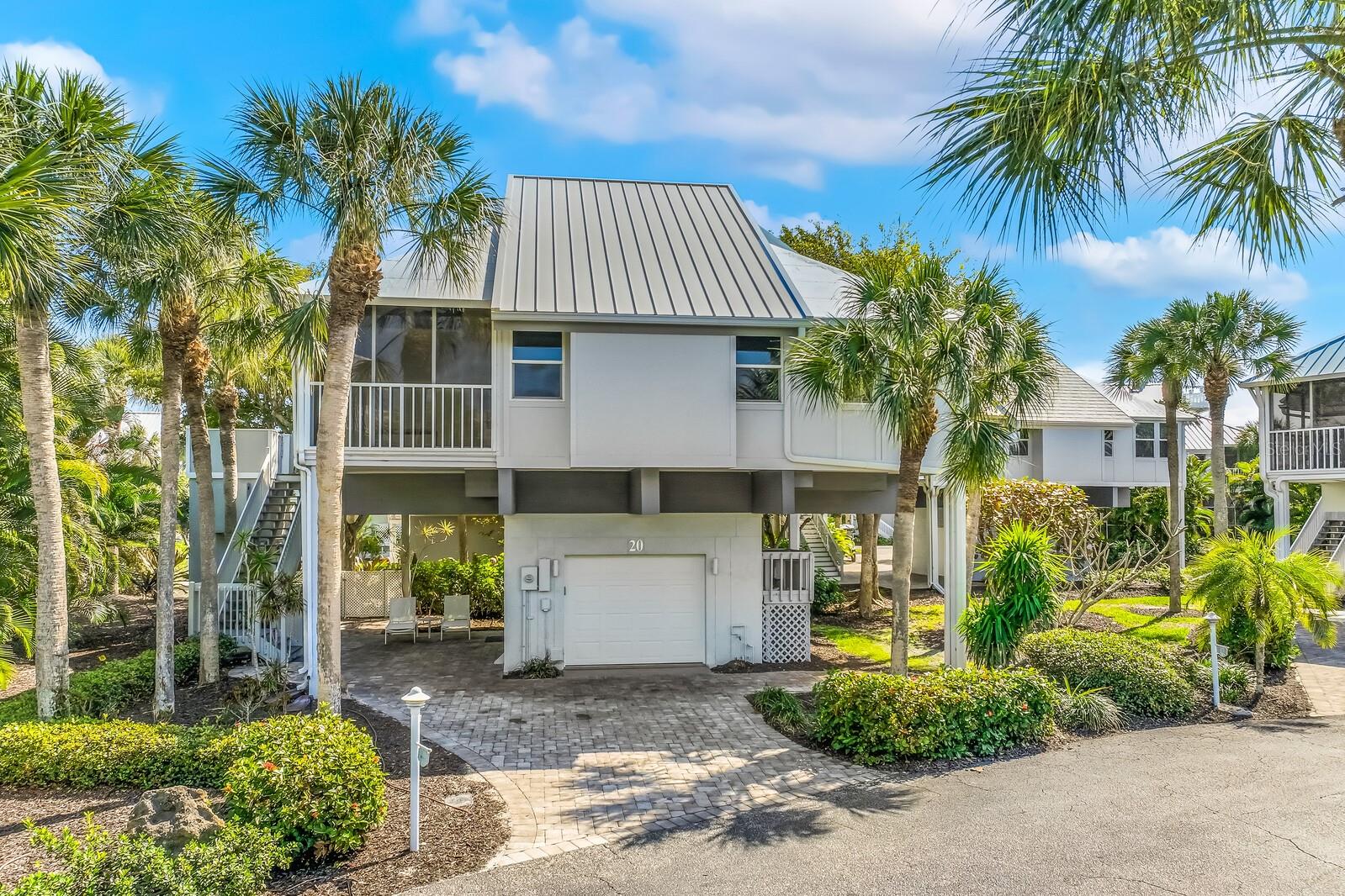 Fully renovated Village Home in the gated Boca Grande Club, offering 3 bedrooms, 3 baths plus a fourth kids’ room and over 1,600 square feet of living space, including approximately 400 square feet of thoughtfully added living area. Designed with a coastal-contemporary aesthetic, the home features an open-concept layout with vaulted ceilings, abundant natural light, enclosed sunrooms, and a striking new fireplace that anchors the main living space. The gourmet kitchen showcases premium LG appliances, quartz countertops, and designer fixtures, seamlessly blending style and functionality. The reimagined primary suite offers a spacious walk-in closet and a spa-inspired bath with dual vanities and a large walk-in shower. The loft level has been expertly transformed to include a private bedroom and full bath, creating an ideal retreat for guests or family. Throughout the home you’ll find designer tile, new hardwood flooring, updated doors, trim, and hardware, along with modern conveniences including a full-size in-home washer and dryer and outdoor elevator lift. Significant upgrades include impact windows, Hardie siding, Trex decking, a newer roof, open-air lift, and a 2017 HVAC system, ensuring both durability and peace of mind. Enjoy west-facing outdoor living with beautiful sunset views and glimpses of the Bay and Gulf, along with a garage and private garden area. Located just steps from the secluded beach, this home offers the perfect blend of privacy and coastal lifestyle. Residents of the Boca Grande Club enjoy an exceptional amenity package including Gulf-front dining, three pools, tiki bar, fitness center, yoga and water aerobics, eight tennis courts, and gated security.