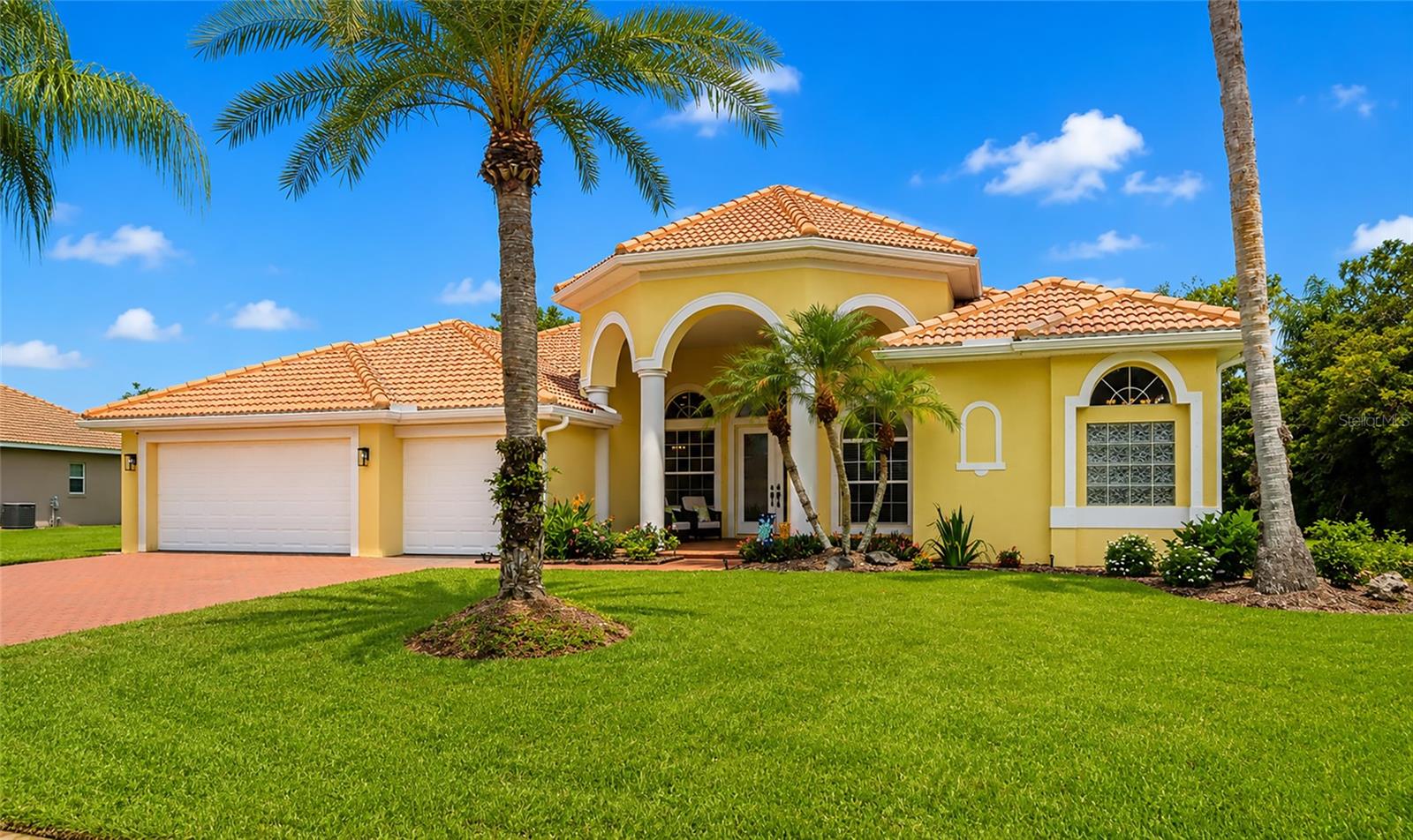 A rare find near Lakewood Ranch! Discover the ultimate combination of space, luxury, and major tax savings in the highly desirable community of Country Meadows. Set on a sprawling, private half-acre lot—a true rarity compared to the tight lot sizes of newer construction—this exceptional 4-bedroom, 3-bathroom pool home offers a premium lifestyle with LOW HOA fees and NO CDD fees on your tax bill. From the moment you arrive, the brick paver driveway, pristine tile roof, and charming covered front porch deliver unmatched curb appeal. Inside, French entry doors open to an expansive open floor plan flooded with natural light, featuring soaring 12-foot ceilings and dramatic 13-foot tray ceilings. The heart of the home centers around a functional kitchen with a sunny breakfast nook and aquarium-style windows that frame your private outdoor paradise. Effortless indoor-outdoor living comes alive with sliding glass doors from three separate rooms opening to a massive screened lanai. Relax by the freeform pool and spa with a spillover waterfall, all surrounded by lush, mature landscaping that ensures total privacy. The split floor plan features a primary suite sanctuary with a built-in workspace, dual walk-in closets, a garden soaking tub, and a separate walk-in shower. On the other side of the home, a pocket door closes off the fourth bedroom wing, creating an ideal private en-suite or multi-generational studio with a dedicated workspace and a full bath with direct pool access. Recent premium updates include a freshly painted interior, upgraded bath countertops, a 2024 smart washer/dryer, a 2023 water heater, and an app-controlled security system. Ideally located just north of SR-64, you are minutes from the very best of the Lakewood Ranch area—including Waterside dining, polo matches, and vibrant farmers markets—plus UTC shopping, Ellenton Outlets, and the world-renowned beaches of Anna Maria Island. Enjoy the location without the high cost of living!