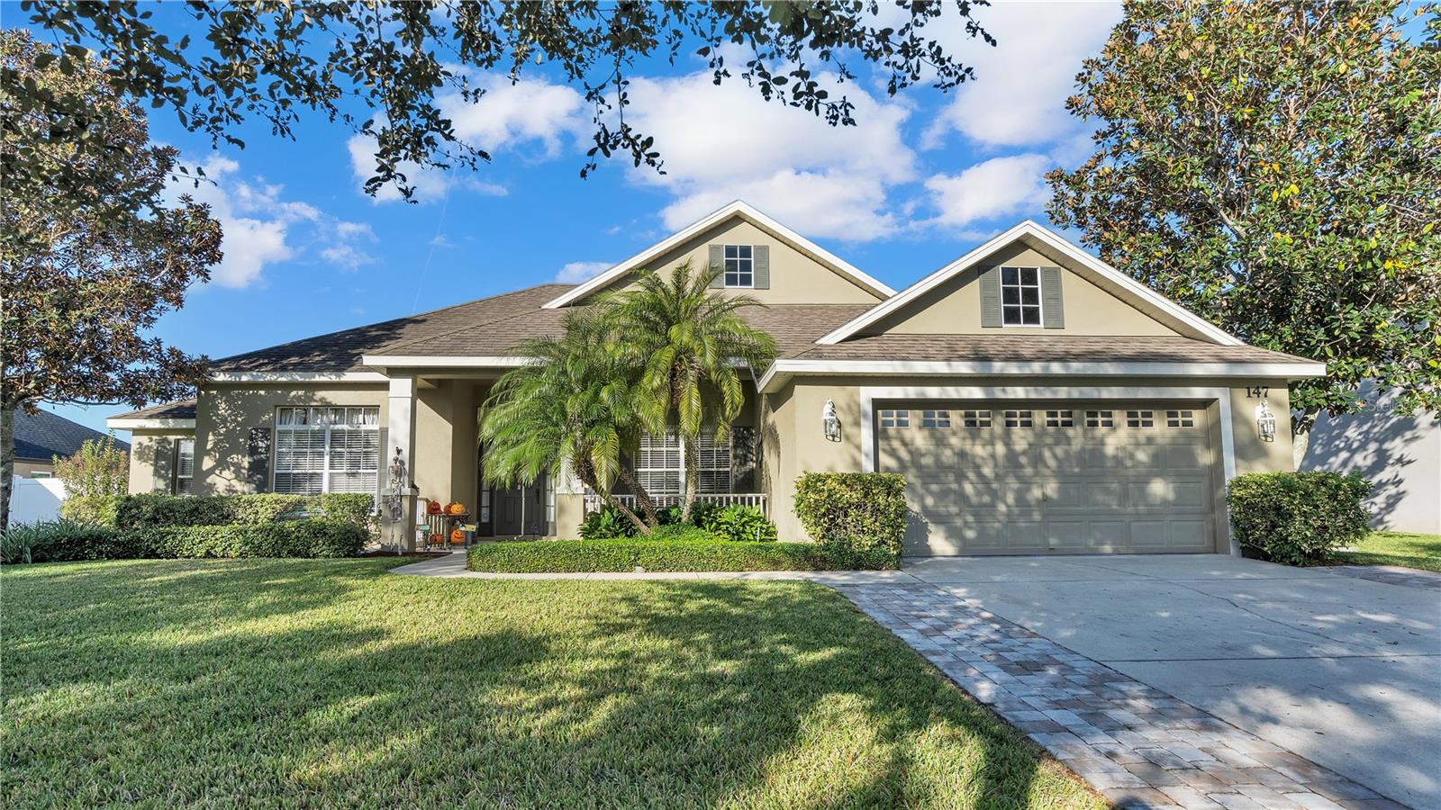 Welcome to the serene and exclusive Estates of Auburndale, a gated community surrounded by lush, mature hedges and a lifestyle of elegance, comfort and convenience. Low HOA and NO CDD! As you drive through this remarkable community, you'll notice the well-maintained homes that create an ambiance of beauty and elegance where residents invest in their homes. Now, the opportunity awaits you to own a stunning 3-bedroom, 2-bathroom home with a flexible space that can be transformed into a den, office, or whatever suits your needs. This home boasts 2018 square feet of living space and a total of 2847 square feet situated on a generous lot of a quarter acre! A brand new roof completed November 2023 to eliminate all your worries of a HUGE expense. Admire the updated pavers that were installed on each side of the driveway ensuring easy access to and from your vehicle while adding a touch of beauty to your property presence. As you walk to the front door this home welcomes you with the well -manicured yard, lush green grass and perfectly groomed hedges and pre-matured trees that present you to an inviting front porch with a sitting area. Step on in to the open floor plan with spectacular laminate flooring that gleams as it basks in the natural sunlight that streams through the exceptional sliding glass doors. The living room serves as the heart of the home, with the kitchen and dining room situated off of it, making family gathering or entertaining a breeze with cooking and socializing together. A chefs kitchen awaits you with beautiful JettaStone countertops with plenty of space to prep your meals, a stainless steel farm sink, stylish backsplash, plenty of cabinetry for storage, and a breathtaking kitchen nook, perfect for morning gatherings before you start your day . The owners' suite is 13x19 featuring Berber carpet, a beautiful tray ceiling, access to the screened in lanai through the sliding glass doors and a master bathroom that is sure to capture your heart with its deep garden tub, perfect for hot bubble baths to unwind and rejuvenate. Dual sinks adding convenience to your morning or evening routine and a nice walk in closet. You'll find the other 2 bedrooms and the office right off the living room offering family and guests their own space. Bedroom 2 and 3 have Berber carpet, ceiling fans and access to the second bathroom that has a spacious linen closet and direct access to the screened in lanai. The screened in lanai overlooks the backyard, a space to enjoy the outdoors, rain or shine. The backyard itself is an oasis with thick, healthy grass and a fully fenced in yard, providing both privacy and security. Updated pavers ensure easy access to the side of the house, allowing gate access. There's plenty of room to install a future pool, or simply enjoy the open space for entertaining and recreational activities. Ride your bike or take a stroll to the community pool which has a kiddie and adult pool, playground, basketball courts and a turtle habitat that is exceptional to see. Minutes from I-4 and Polk Parkway making commutes friendly.  This is more than just a house; it's an opportunity to become a part of a thriving, vibrant community where pride of ownership and a warm welcoming spirit are the cornerstones of everyday life. Don't miss the chance to be a part of this exceptional community, make this house your HOME today.