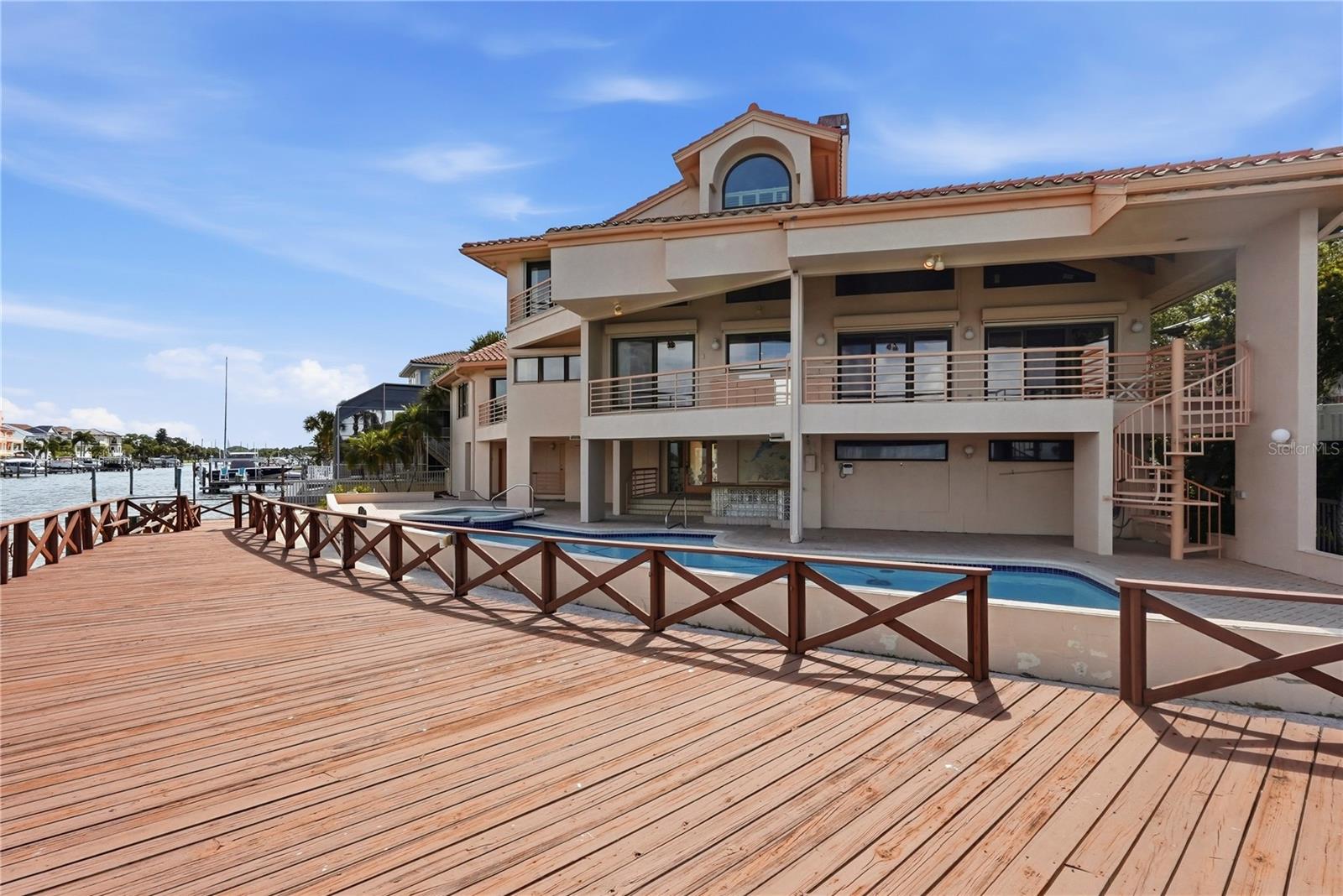 This magnificent estate is set on an exceptional location and lot with 102 ft frontage a wide open billion-dollar view of BOCA CIEGA BAY and yearlong 180-degree SUNSET views this estate masterpiece spans over 4155 sq ft of refined interior living space. A dramatic open-concept three story which wraps around the living area with a commanding fireplace that anchors the soaring cathedral ceilings. The sweeping water views from each room on the second level is where you can capture synchronized sunset views and compliments with large balconies and outdoor cook top and refrigerator for entertaining. The high caliber of kitchen appliances alongside elongated island provides exceptional versatility for entertaining as well as two resort-type bars. Outside the home transforms into a private oasis with spa and resort-type sparkling pool full 180 degrees of water views. The pool bathroom has washer and dryer hook-ups, shower, vanity, and benches.  The wood deck spans most of the property. Additional highlights include Primary Bedroom with ensuite and Hugh walk-in closet, two additional bedrooms also ensuite and a loft. The three garages has parking for 4 vehicles. Quality high grade superior structural elements built this custom masterpiece in 1990 with many extras. Hurricane Shutters, Central Vacuum, Elevator, pet bathtub are just a few. The famous Vaughn McCarthy & Sons of PVC architects designed it and a full set of blueprints are available.  PASADENA YACHT AND COUNTRY CLUB is one of the finest country club communities on the west coast of Florida. Enter through the 24/7 Guard Gate to a refined lifestyle full of pastoral land and mature landscapes. PASADENA YACHT CLUB AND COUNTRY CLUB is a very sought after community and this masterpiece is offered for the first time. Come and enjoy the ultimate in Florida lifestyle.