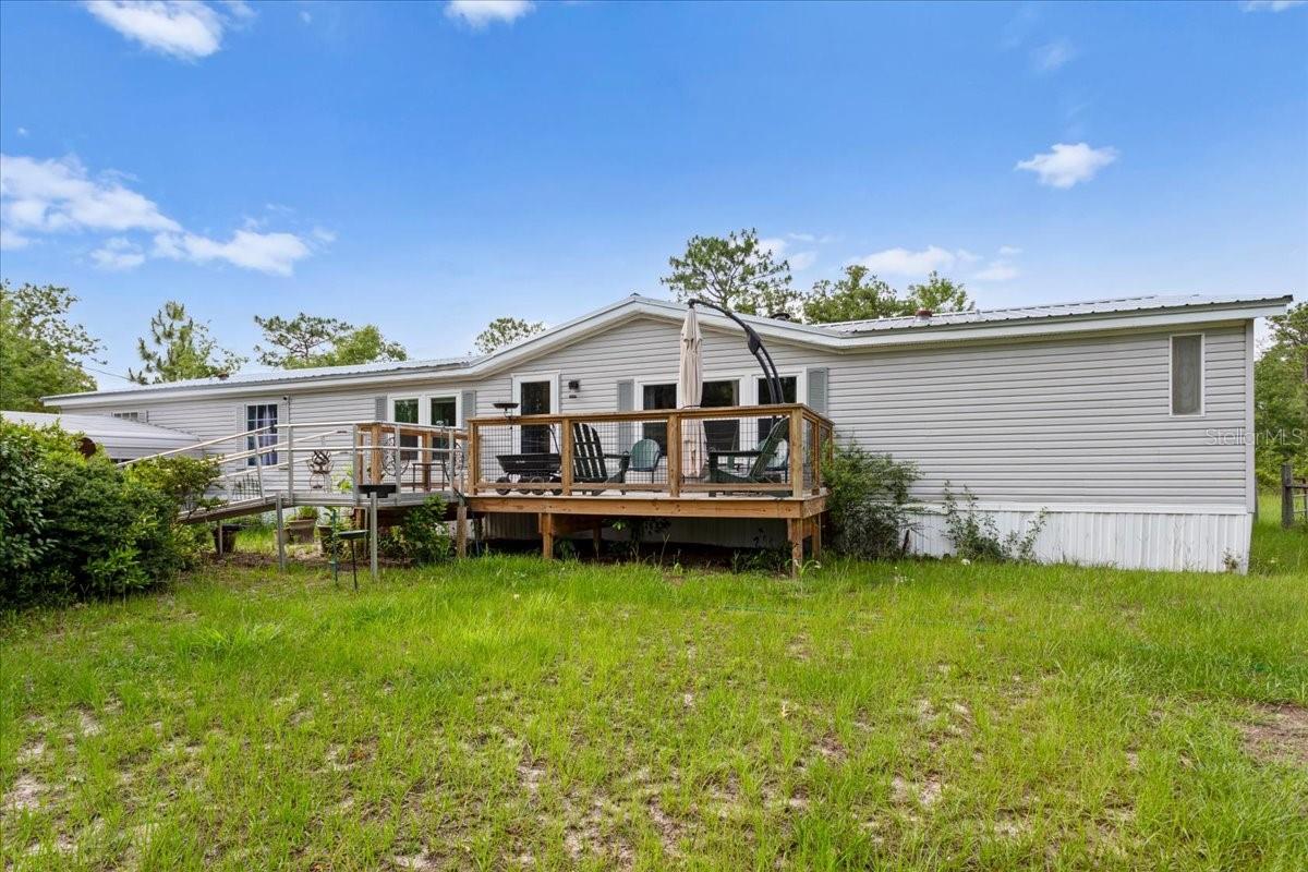 Welcome to your slice of country living in High Springs! Situated on over 5 beautiful acres, this spacious 4-bedroom, 2-bath mobile home offers the perfect blend of comfort, functionality, and outdoor space. Inside, you’ll find two separate living rooms, giving plenty of room to spread out or entertain. The large open kitchen features abundant cabinet space!  Enjoy peaceful mornings on the front porch and unwind in the evenings on the back porch while taking in the privacy, wildlife, and open surroundings. The home also features an accessible entrance, multiple carports for convenient covered parking, a large storage shed, and an additional smaller shed for all your tools, hobbies, or outdoor equipment.   With plenty of open yard space, the possibilities are endless - gardening, animals, recreation, or simply enjoying room to roam. Conveniently located minutes to Ginnie Springs, Gilchrist Blue Springs, Poe Springs, and more!  Short drive away you'll find historic downtown High Springs, and with an easy commute to Gainesville or Lake City, this property also benefits from lower Gilchrist County taxes and fiber internet availability for modern convenience in a peaceful setting.