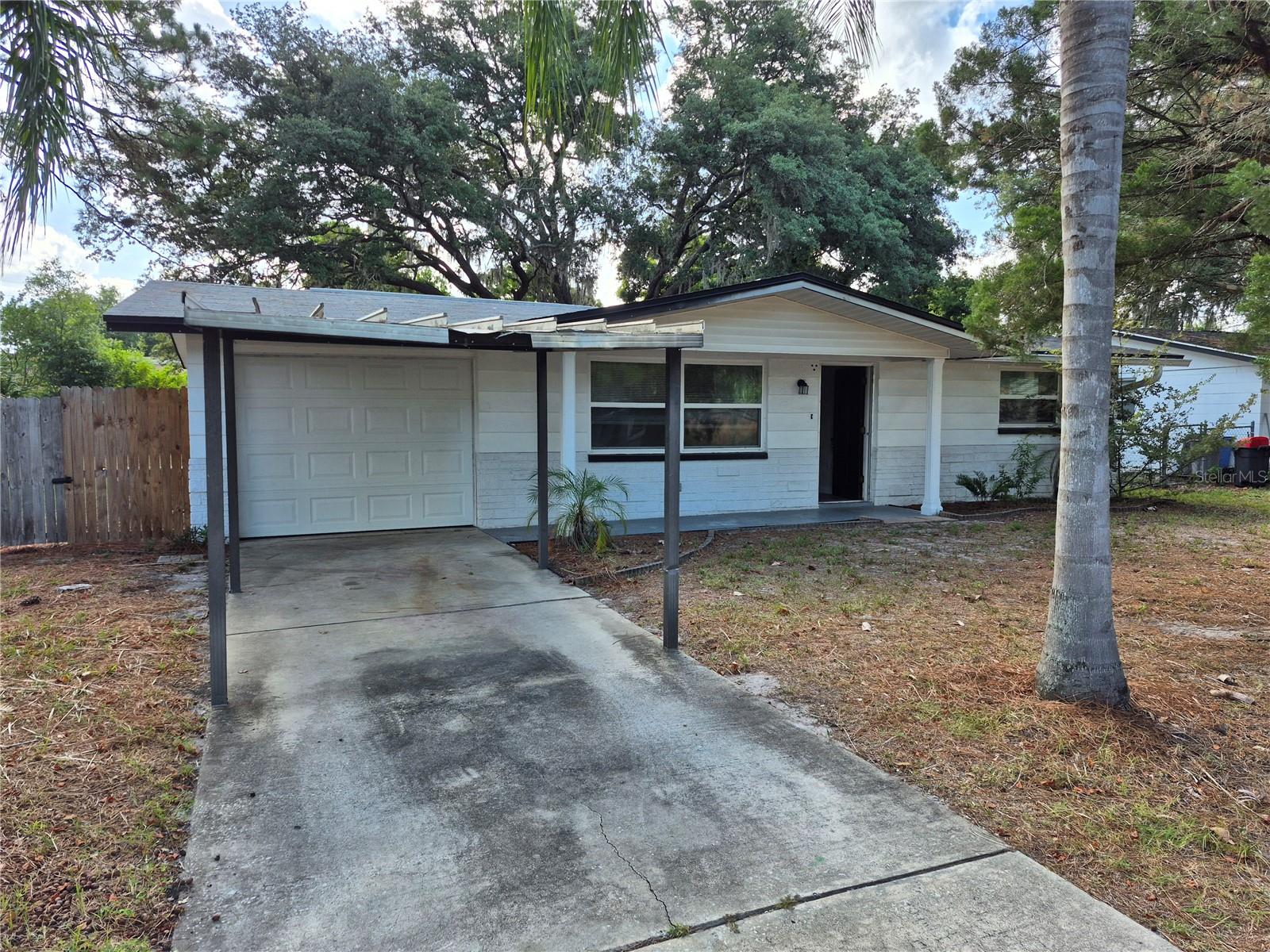 Welcome to New Port Richey! Nestled on a sprawling, fully fenced 1/3-acre lot, this charming 2-bedroom, 1-bath home offers a rare combination of privacy, functionality, and outdoor space. Tucked away in a quiet, peaceful setting, the property features a wide double-gate entrance, providing easy access for trailers, boats, work vehicles, recreational equipment, or simply enjoying the convenience of a large, accessible yard.

Inside, you'll find a bright and inviting living area filled with natural light, creating a warm and comfortable atmosphere throughout the home. The well-appointed kitchen offers modern appliances, ample cabinet storage, and plenty of counter space for everyday cooking and entertaining.

Both bedrooms are generously sized and feature durable luxury vinyl plank flooring, while the updated bathroom provides a clean and modern feel. The attached one-car garage offers secure parking and additional storage.

The true highlight of this property is the expansive backyard. Whether you're looking for room to store your toys, let pets roam freely, create a garden oasis, host family gatherings, or simply relax and enjoy the peaceful surroundings, this oversized fenced yard delivers endless possibilities. Properties with this much usable outdoor space and easy gated access are increasingly hard to find.

Conveniently located near shopping, dining, parks, schools, and everyday conveniences, this well-maintained home offers the perfect balance of quiet living and accessibility. Don't miss your opportunity to enjoy the space, privacy, and flexibility this unique property has to offer.