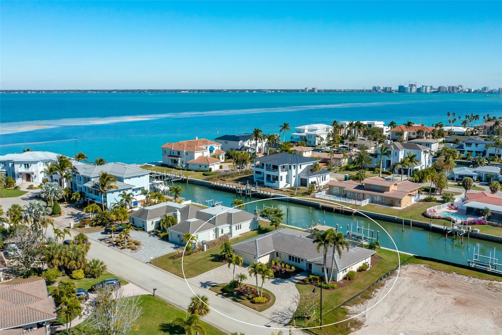 Country Club Shores - Completely renovated 3-bedroom, 2-bath canal-front home just three houses from the Bay. Updates include a new flat tile roof (2025), Carrier A/C and A.O. Smith water heater (2024), Pebble Tec pool and paver deck (2024), and newer seawall, dock, and 16,000 lb. boat lift (2.5 years). Enjoy Bay views from the 18 foot x 16 foot Trex dock with lighting and water, plus a 3 foot x 36 foot Trex dock with power and water. Interior features NuCORE waterproof flooring, plantation shutters, Silestone quartz countertops, and new Bosch and GE stainless appliances. The primary suite includes a walk-in closet with built-ins, dual sinks, whirlpool tub, and large shower. Split floor plan with guest bedrooms featuring walk-in closets; one includes a built-in office area. Move-in ready and ideally located for boaters seeking the best of Longboat Key waterfront living.
