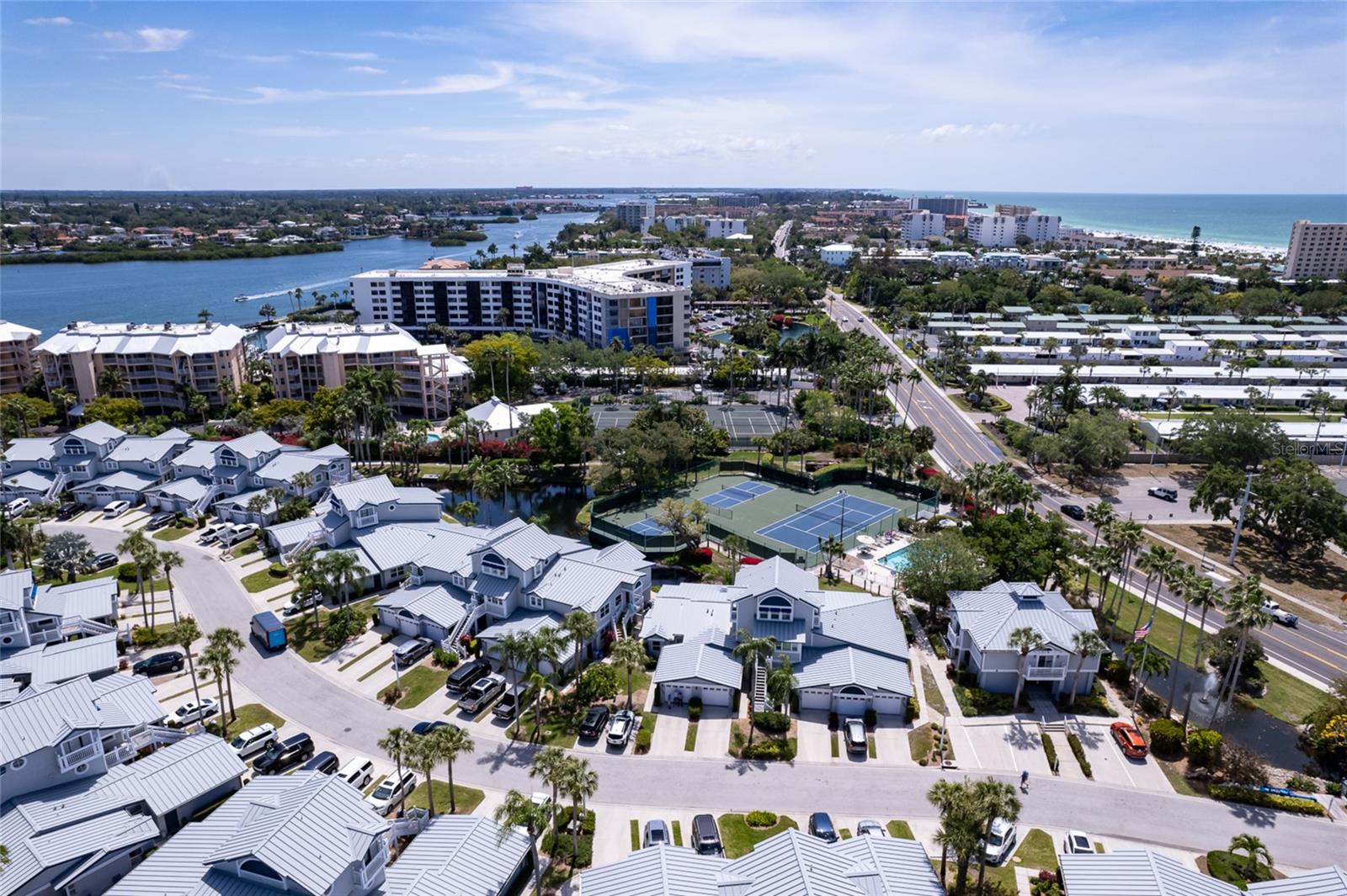 Welcome to your slice of Paradise on Siesta Key! This beautifully renovated 2 bedroom, 2 bath, 1 car garage end unit condo is located in the highly sought after Gulf & Bay Club Bayside, offering private, deeded beach access to the world-famous Siesta Key Beach. Best of all, the property has No Hurricane Damage, providing peace of mind for full time residents, and investors alike. Enjoy the tranquil views of the pond, tennis and Pickleball courts, and the community pool from this light filled unit. Vaulted ceilings and No Unit above enhance the sense of space and privacy. The home has been thoughtfully updated with porcelain tile throughout the living areas, and a stunning fully renovated kitchen featuring Quartz countertops(including the breakfast bar), custom wood cabinetry, and stainless steel appliances. A built in desk with cabinetry creates an ideal home office or workspace. The spacious owner’s suite includes a walk in closet and an updated en-suite bathroom with new vanity, Quartz countertops, and tiled walk in shower. Adjacent to the living room, an enclosed patio offers versatile flex space, perfect for additional seating, dining, or simply enjoying your morning coffee while soaking in the Florida sunshine. Gulf & Bay Club Bayside is a resort style community offering deeded beach access, two heated pools, tennis and Pickleball courts, outdoor grilling areas, a fitness facility, and a fishing dock on the Intercoastal Waterway. With one week minimum rentals allowed and an optional on site rental office, this condo presents an excellent investment opportunity. Furnishings available under a separate contract. Ideally located just steps from the white sands of Siesta Key Beach and short distance to Siesta Key Village’s restaurants and shopping, this is a rare opportunity to own a beautifully updated condo in one of the island’s most desirable communities.
