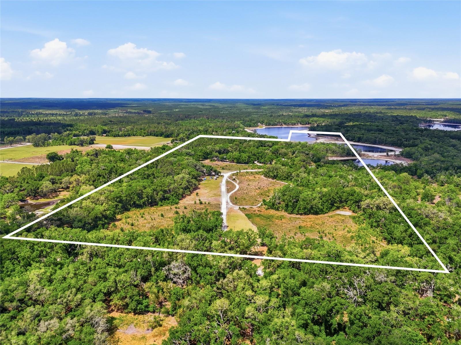 A truly extraordinary and incredibly rare opportunity awaits with this one-of-a-kind 66-acre multi-family estate, privately nestled in a peaceful and picturesque country setting. Whether you’re searching for a high-income-producing investment, a private family compound, an unforgettable hunting and fishing retreat, or a legacy property to enjoy for generations, this remarkable estate offers unmatched versatility, privacy, and endless potential. Surrounded by natural beauty and thoughtfully designed for both comfort and functionality, the property features five residential buildings strategically positioned throughout the acreage to create a sense of privacy and independence. Approximately 57 acres showcase a beautiful mix of open land and wooded surroundings, while an additional privately owned 9-acre portion of Lake Adam provides stunning water views, peaceful lake access, and a breathtaking backdrop rarely found in today’s market. The property is also conveniently located near the famous Suwannee River, making it ideal for outdoor enthusiasts who enjoy boating, fishing, hunting, and year-round recreation. A large open area along the entrance road creates incredible flexibility for future expansion and development opportunities, whether your vision includes additional residences, RV sites, gardens, livestock, recreational amenities, event space, or an expanded retreat-style setting. With over 9,100 square feet of permitted building area, the property is uniquely suited for a wide variety of uses including long-term rentals, short-term vacation rentals, employee housing, multi-generational living, or a private estate compound. Built between 1997 and 2019, the residences feature durable commercial-style modular metal construction with full insulation and quality interior finishes, offering the perfect blend of low-maintenance durability and comfortable living. Each residence is individually equipped with its own private well, septic system, and electric meter, creating convenience, efficiency, and true independence for both owners and tenants. Unlike traditional rental communities, each home enjoys approximately one to two acres of private yard space, providing residents with a spacious and peaceful environment to relax and enjoy the beauty of country living. Community-style amenities further enhance the property’s appeal, including a screened-in swimming pool and private lake access that invite endless relaxation and outdoor enjoyment. Properties offering this level of acreage, infrastructure, privacy, water frontage, and income-producing potential are exceptionally difficult to find. Whether your dream is to create a thriving rental portfolio, establish a private family retreat, develop a destination getaway, or secure a long-term investment with limitless possibilities, this truly remarkable property is ready to make that vision a reality.