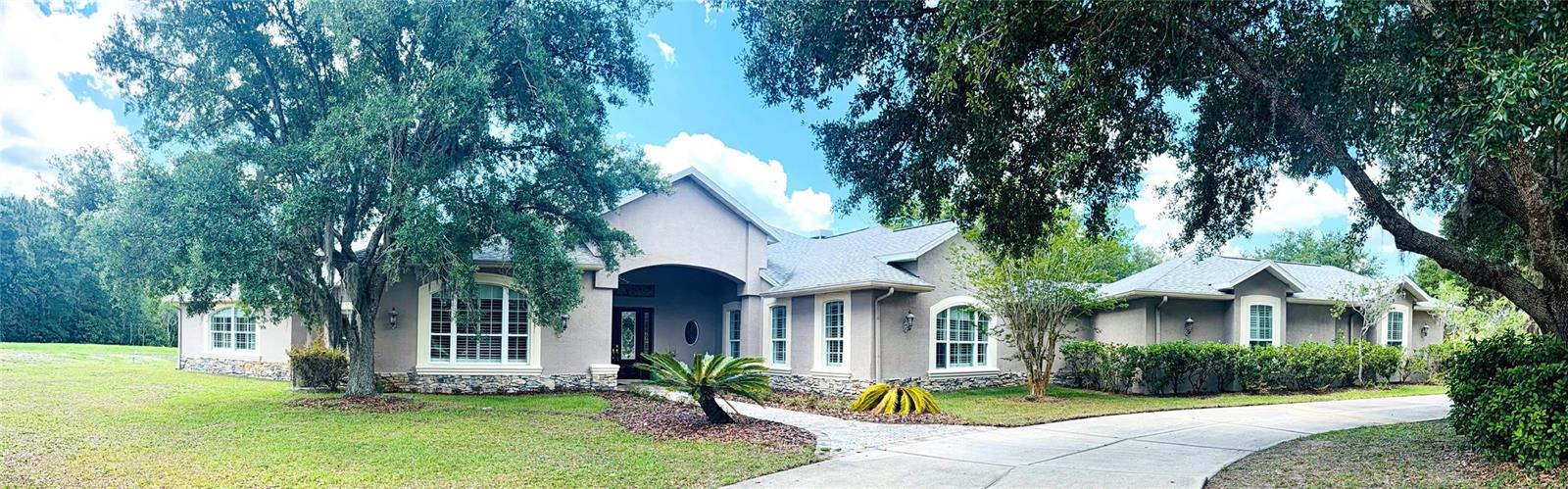 Welcome to the Equestrian Community of Pasco Trails! This estate is fully fenced with a private gated entrance that leads to a circular driveway with a 5,564 s/f pool home sitting on 9.75 acres of property.  Enter the home through the leaded glass front doors into the vast foyer with a direct view to the lanai, pool and backyard. To your left is an oversized family room and your own personal master wing that includes a private office/ bedroom, sitting area, 2-sided fireplace, wet bar, en-suite bath and exercise/flex room with access to the pool area. The master bath is incredible with a private water closet, multi-head shower, dual vanities and heated jetted soaking tub. The master also has a large walk-in closet with secure gun room. The three additional bedrooms are on the opposite side of the home and each with its own en-suite bath, one with pool access. There is a double desk space with storage in the hall leading to the 3 additional bedrooms, a great landing spot for doing homework or working on a project. The kitchen will impress even the most discerning chef in the family. The massive island has tons of storage including a wine rack, cooktop with a beautiful stainless-steel hood and convenient warming drawer. Plenty of counter space, two dishwashers, double built-in convection ovens and a separate microwave. The walk-in pantry has room for all the staples and utensils every cook wants and needs. The Living room with gas fireplace is spacious and also has direct access to the lanai. The formal dining room is large enough to host any large holiday gatherings. The excessively large mud room/laundry room with laundry room sink, built in ironing board is ideal for backpacks, shoes and plenty of room for an extra refrigerator!  The laundry room leads to a spacious 4 car garage. The 40 X 20 pool with spa and outdoor kitchen are meant for entertaining with a wonderful view of the property.   There is a detached garage with drive-through ability to house the lawn equipment, cars and would make a great workshop. This house comes with a 2023 new roof, 2 new water heaters, water softener, two new 5 ton A/C units, 3 electrical panels, central vacuum and so much more.  Just minutes to the Suncoast Parkway or I75; both will take you to shopping, dining, Tampa International Airport, entertainment and the beautiful Suncoast beaches.