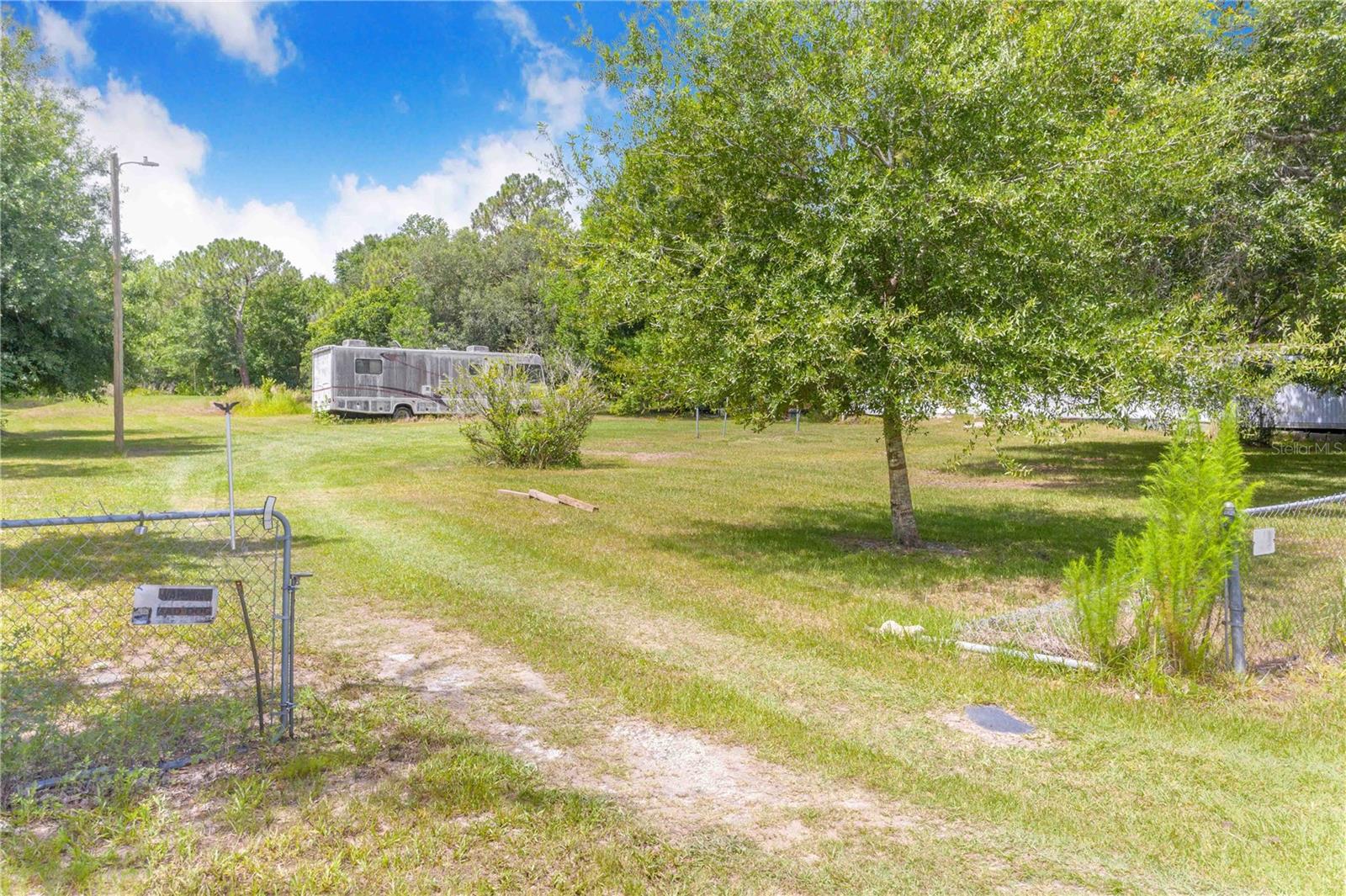 Welcome to country living in the heart of Central Florida! This beautiful 4.93-acre property offers the perfect blend of privacy, natural beauty, and convenience. Surrounded by majestic Florida pine and oak trees, this secluded piece of paradise is becoming increasingly rare as Central Florida continues to grow.The property is improved with an existing well, septic system, and power, providing an excellent opportunity to save on future development costs and potential impact fees. An older mobile home is located on the property; however, no title is available and it is being sold as-is with no assigned value. There is also an outbuilding that offers excellent storage for tools, equipment, recreational vehicles, or hobbies.Build your dream home and enjoy the peaceful country lifestyle while still being conveniently located near shopping, dining, schools, medical facilities, and all of Central Florida’s world-famous theme parks and attractions. Centrally located, you’ll appreciate the easy access to both Florida’s East Coast and West Coast beaches, making day trips in either direction a breeze.Whether you’re looking for a private homestead, weekend retreat, or investment opportunity, this property offers endless potential. Bring your vision, remove the existing mobile home, and create the forever home you’ve always dreamed of on this beautiful piece of Old Florida.Don’t miss this rare opportunity to own nearly 5 acres in one of Florida’s fastest-growing regions!