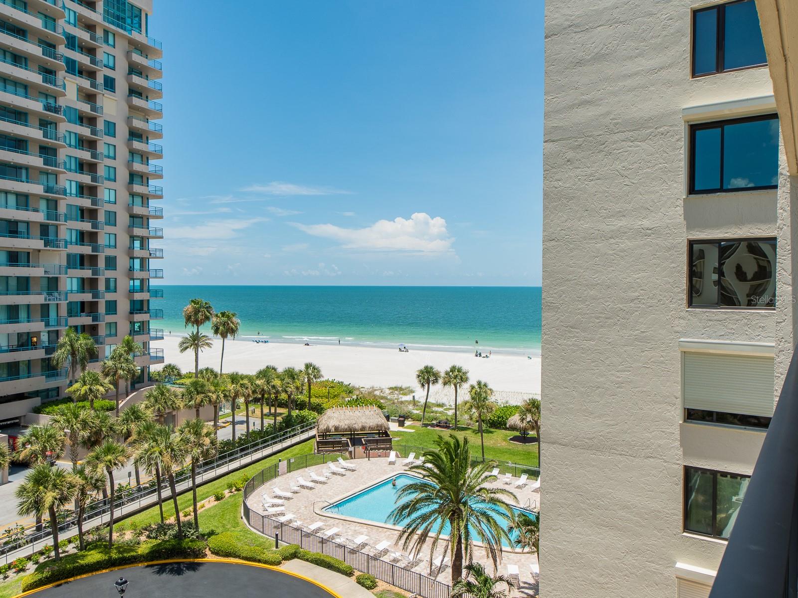 Welcome to the highly desirable Sand Key, where Gulf-front living is at its finest! , featuring direct access to the pristine Gulf beaches, a sparkling pool, outside grilling area, community club room and tiki hut tables perfect for relaxing and enjoying the stunning views. Enjoy breathtaking sunsets every evening and the soothing sound of ocean waves from your balcony. This unit features 2 bedrooms with balcony access and 2 full bathrooms. The primary suite includes a spacious closet and an ensuite bathroom for your comfort. Well-maintained with custom built-in shelves in the living area and bamboo floors throughout. Conveniently located near the Jolley Trolley and the Shoppes of Sand Key, offering a variety of shopping and dining options. Just a short drive, walk or bike ride over the Sand Key Bridge to the vibrant Clearwater Beach. Make this your perfect forever or vacation home—schedule your tour today!