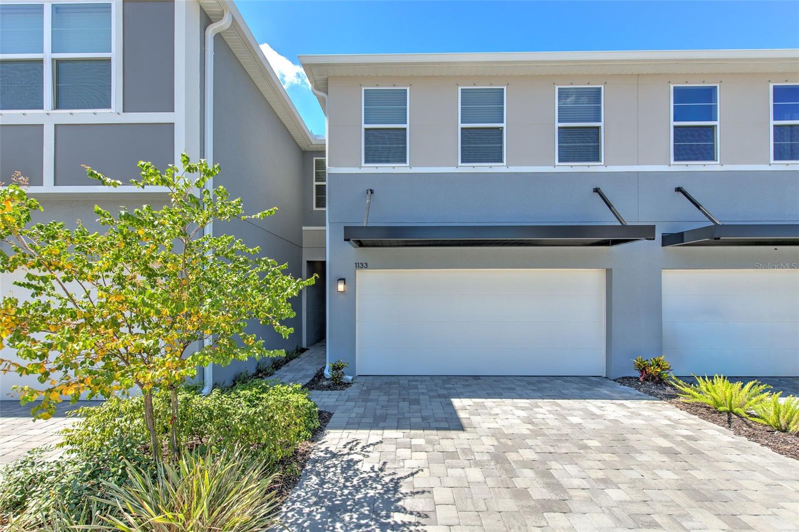 BETTER THAN NEW | STUNNING UPGRADES | PRIME BRANDON/VALRICO LOCATION on a PREMIUM WATER VIEW LOT! Why wait to build when you can move right into this barely lived-in, almost-new townhome loaded with upgrades and designer touches throughout?  This beautiful 3-bedroom, 2.5-bath townhome with a spacious 2-car garage offers the perfect combination of style, comfort, and convenience.
From the moment you arrive, the paver driveway and elegant glass-paneled front door create incredible curb appeal. Inside, you’ll love the bright, open floor plan featuring tile flooring throughout the downstairs living areas and recessed lighting that creates a clean, modern feel.
The kitchen is truly a showstopper—featuring upgraded step and stagger gray cabinetry with soft-close doors and drawers, crown molding, gorgeous Calacatta quartz countertops, a stunning glass tile backsplash, stainless steel appliances, a walk-in pantry, and additional under-stair storage for maximum functionality.  The spacious living and dining areas flow seamlessly to peaceful pond views—the perfect setting to enjoy your morning coffee or end your day unwinding while taking in the peaceful sights and soothing sounds of nature, quiet surroundings, and beautiful sunset views. A thoughtfully designed drop zone just inside the garage entrance creates the perfect landing space for bags, shoes, and everyday essentials—adding convenience to daily living. Upstairs, a large loft provides flexible space ideal for a second living area, media room, home office, playroom, workout space, or cozy retreat. The owner’s retreat offers an unexpected luxury with TWO walk-in closets and a beautiful ensuite bath featuring dual sinks and a large shower.  Secondary bedrooms include ceiling fans for comfort and walk-in closets, while the secondary bath offers dual sinks and a tub.  You’ll also appreciate the oversized upstairs laundry room with additional space for storage and functionality—making everyday tasks easier and keeping everything conveniently located near the bedrooms.  Additional upgrades include epoxy-painted garage floor, separate laundry room with shelving, ceiling fans in all bedrooms, pest control tubes in walls, abundant storage throughout.  Located in the highly desirable Bloomingdale area, you’ll enjoy a convenient location close to shopping, dining, entertainment, and major commuter routes while still coming home to comfort and peaceful water views.  This isn’t just a place to live—it’s a place to enjoy your life.  Spend less time on maintenance and more time enjoying peaceful water views, relaxing evenings, and everything the Florida lifestyle has to offer.  This is low-maintenance Florida living at its finest—schedule your private showing before this opportunity is gone!