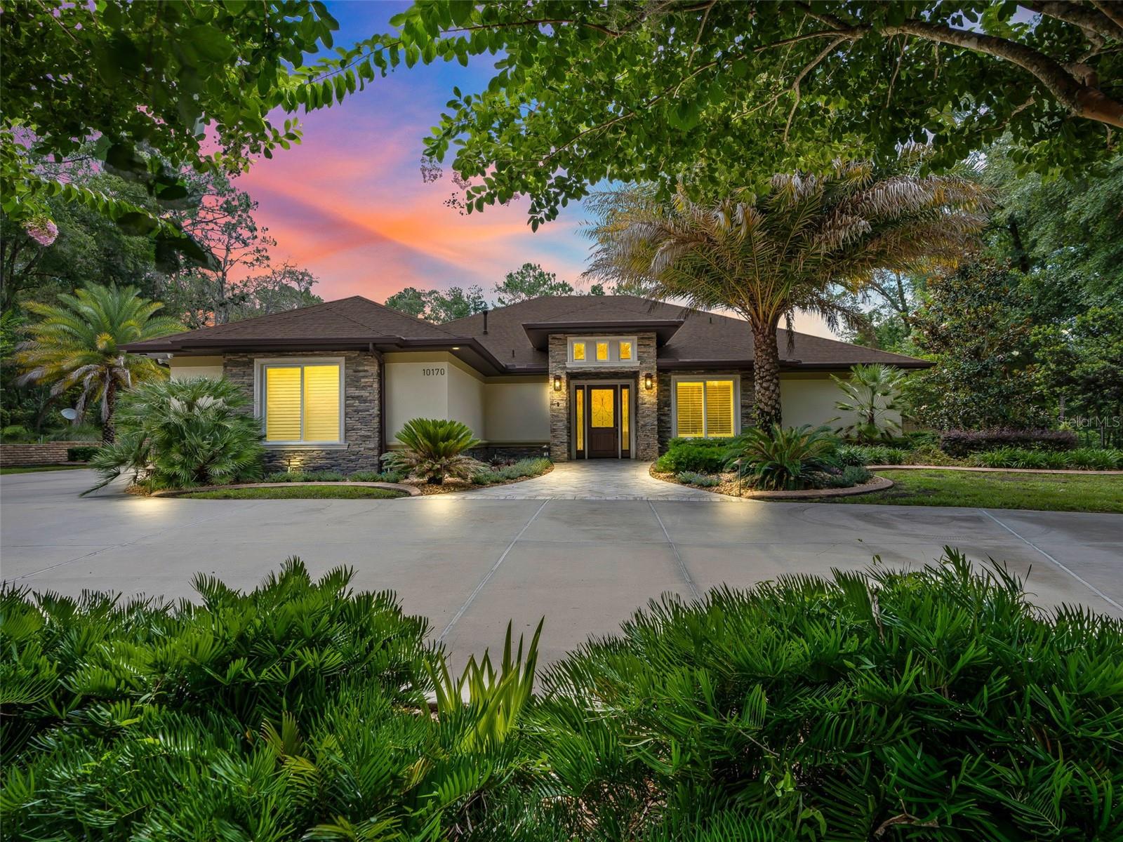 When only the best will do! Custom-built with no expenses spared in 2021- this home was designed & constructed for discerning homeowners. Situated on 1+ acre in Rainbow Springs Woodlands with private access to Rainbow Springs - this impressive property offers a main residence with 3 bedrooms, 3 full bathrooms + an office & incredible pool & outdoor living space; and a 66' x 40' insulated & air conditioned RV garage with a full apartment. The main home welcomes you with a circular drive & luscious landscape leading up the chevron travertine walkway to the covered porch. The leaded glass front door leads inside where you will find travertine flooring that carries throughout the home. You will appreciate tall ceilings, crown molding, plantation shutters, solid core doors, surround sound, & an abundance of recessed & accent lighting. The open kitchen is an entertainer's dream w/stunning ogee edge granite, custom soft-close cabinetry, high-end stainless steel appliances including 6 burner range, dbl wall ovens, warming drawer, microwave drawer and built-in refrigerator. Adjacent is a full size closet pantry across from the sizable laundry room with plenty of storage, utility sink & built-in ironing station. The primary suite is expansive with access to the pool deck, an ensuite bathroom with granite & tile walk-in shower, jacuzzi tub with granite surround, dual sink vanity + sit-down vanity, built-in linen storage cabinet, TV behind the mirror & walk-in closet with custom built-in system. The dedicated office offers a double door entry & overlooks the manicured front yard. The opposite side of the home offers a second bedroom with an adjacent bathroom while the third bedroom offers an ensuite bathroom that doubles as a pool bath with access to the pool deck. Quad pocketing sliding glass doors open to the travertine lanai with tongue & groove wood ceiling, attached outdoor TV, summer kitchen with sink, built-in grill with rotisserie, storage & bar with built-in seating. This space is also insulated and has AC ducts to be turned into additional living space, if desired. Beyond, the heated saltwater pool awaits & features deck jets, decorative inlaid tile, a waterfall spa & Pentair smart remote controls. Surrounded by travertine, built-in hardscape & gorgeous colorful landscaping with lighting & built-in speakers. Built-in LED lighting enhances the summer kitchen, spa & built-in planter. Beyond, the detached garage awaits with ample space for boats, RVs, trailers, trucks, toys & more. Boasting spray foam insulation, full concrete block construction, air compressor lines, multiple 50 amp outlets, & a separate workshop space, laundry area & half bathroom. The apartment in the back of the garage offers 560 sqft of living space with quality finishes. There is a full living, dining & open kitchen space complete with stainless steel appliances. The bedroom offers an ensuite bathroom with a walk-in shower & a walk-in closet. Additional features incl: steel garden shed with ramps, irrigation, landscape lighting, concrete block pool equipment house, oversized 38kw Generac standby generator with 1,000 gal buried propane tank with monitoring system, whole property camera surveillance and security system, oversized gas water heater, exterior with lighting & outlets for holiday lights, gutters & downspouts with underground drainage. Please enjoy the attached 3D & video tours, & schedule your private viewing to experience this exceptional property in person.