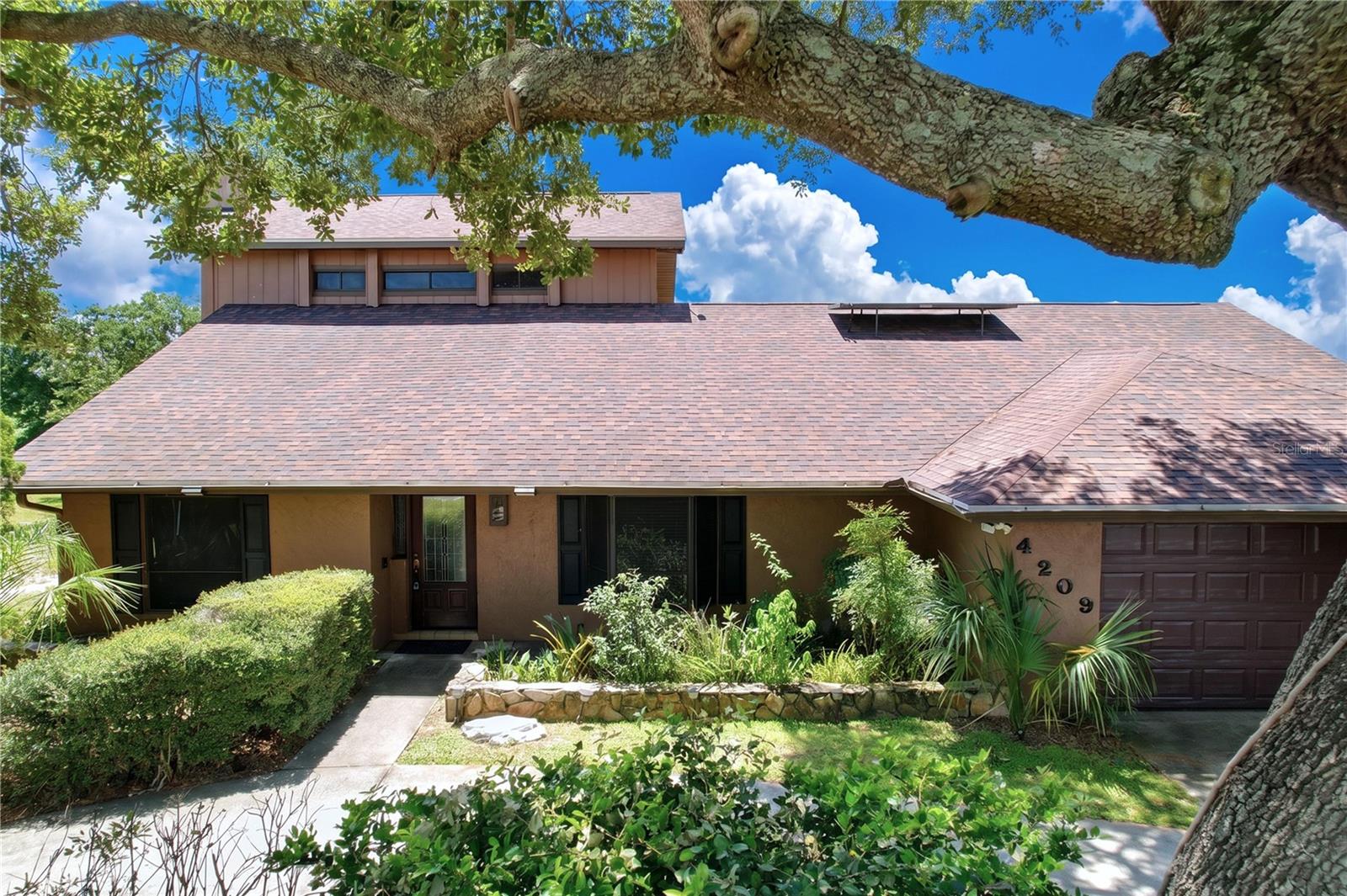 Welcome home to this beautifully maintained two-story residence offering 2,430 square feet of comfortable living space, thoughtfully designed for both everyday living and entertaining. Featuring 3 spacious bedrooms, 3 full bathrooms, and an abundance of character, this home offers the perfect blend of timeless charm and modern updates.

Upon entering, you'll be greeted by a formal living room with soaring ceilings and eye-catching decorative wood slat ceilings that create an inviting sense of warmth and openness. Just beyond, the formal dining room showcases a charming bay window, providing the perfect setting for holiday dinners and family gatherings. The inviting family room features a cozy wood-burning fireplace and flows seamlessly into the updated kitchen, while beautiful hardwood flooring extends throughout the living room, family room, and kitchen.

The kitchen is sure to impress any home chef with its updated cabinetry, granite countertops, and an impressive gas range that makes preparing meals a true pleasure. Sliding glass doors between the kitchen and family room open to an expansive 27' x 15' Florida Room complete with its own mini-split air conditioning system and a convenient summer kitchen with sink, creating an ideal space for year-round entertaining.

The spacious first-floor primary suite offers a private retreat with sliding glass doors leading to a peaceful garden patio, a generous walk-in closet, and an ensuite bathroom featuring dual granite vanities, a relaxing soaking tub, and a separate walk-in shower.

Upstairs, you'll find two oversized guest bedrooms, each boasting its own large walk-in closet and private balconies, providing comfortable accommodations and personal outdoor space. A full hallway bathroom conveniently serves both bedrooms.

Additional updates and features include a new architectural shingle roof installed in April 2021, a solar water heater installed in 2011, and a recently replaced propane tank (May 2026) that services the chef's gas stove. The home has also been professionally maintained with continuous pest control service since 2005 and preventative termite treatment completed in February 2025, providing added peace of mind for the next owner.

If you've been searching for a home that offers generous living spaces, quality updates, exceptional entertaining areas, and meticulous maintenance, this one deserves a place at the top of your must-see list. Schedule your private showing today!