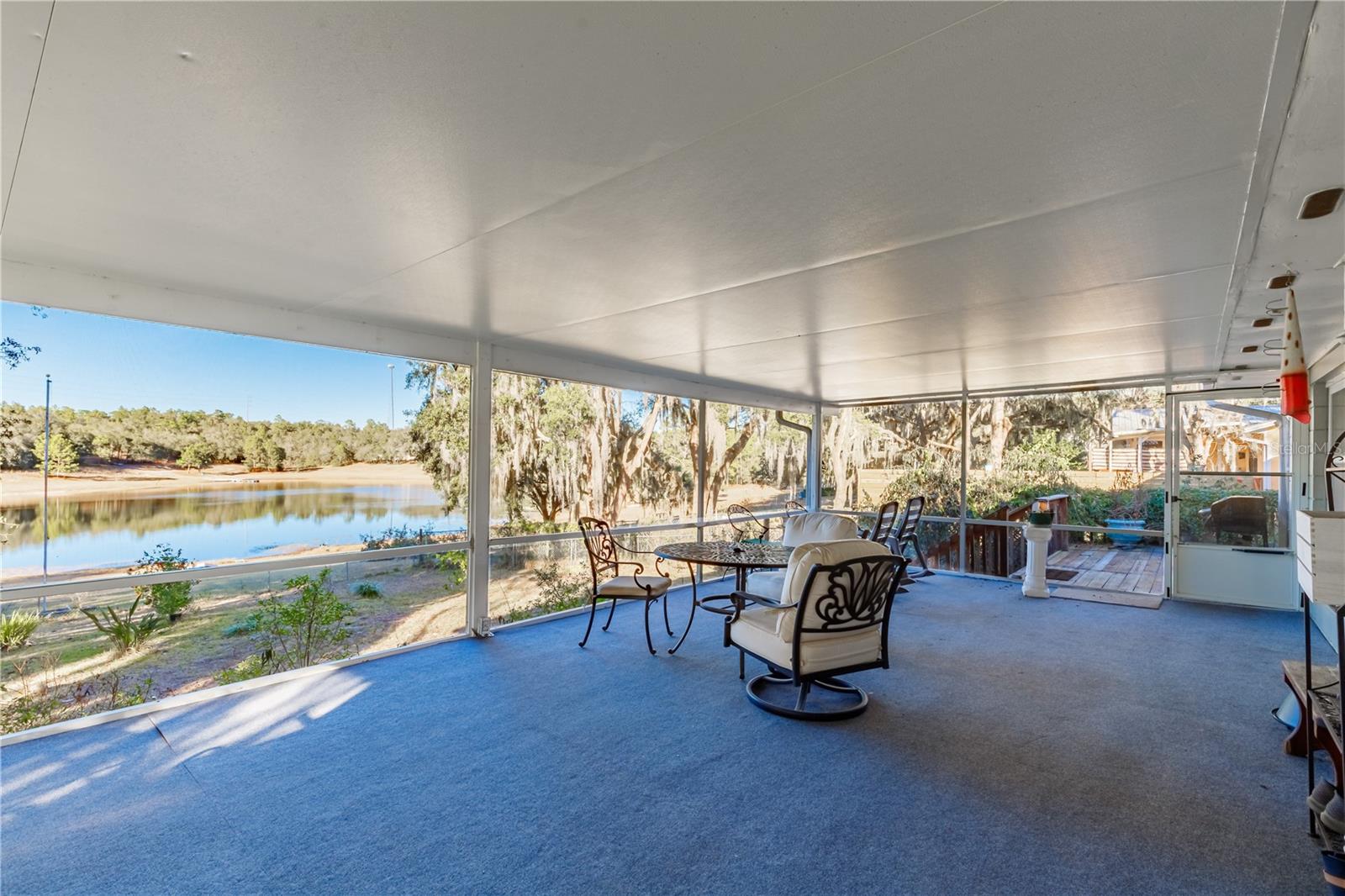 Wake up to peaceful lake views in this beautifully updated 3-bedroom, 2-bath concrete block home on Lake Loch Lommond. Designed with an open floor plan, the home centers around a stunning stone wood burning fireplace, creating a warm and inviting focal point for everyday living and entertaining. Enjoy breathtaking lake views from the living room, dining area, and primary bedroom, filling the home with natural light and serene water scenery. The living room opens to a large screened room, perfect for relaxing year round, while the primary suite features its own private deck overlooking the lake, an ideal spot for morning coffee or evening sunsets. The kitchen offers a large island with additional storage and electrical, a spacious pantry closet, and new stainless steel appliances installed in 2025. Updated tile flooring runs throughout most of the home, complemented by a remodeled primary bathroom and an updated second bath. Outside, the fully fenced backyard provides a safe and enjoyable space for pets, play, or outdoor gatherings. This lakefront home combines comfort, functionality, and scenic beauty in a setting that feels like a private retreat while still being ideal for everyday living.